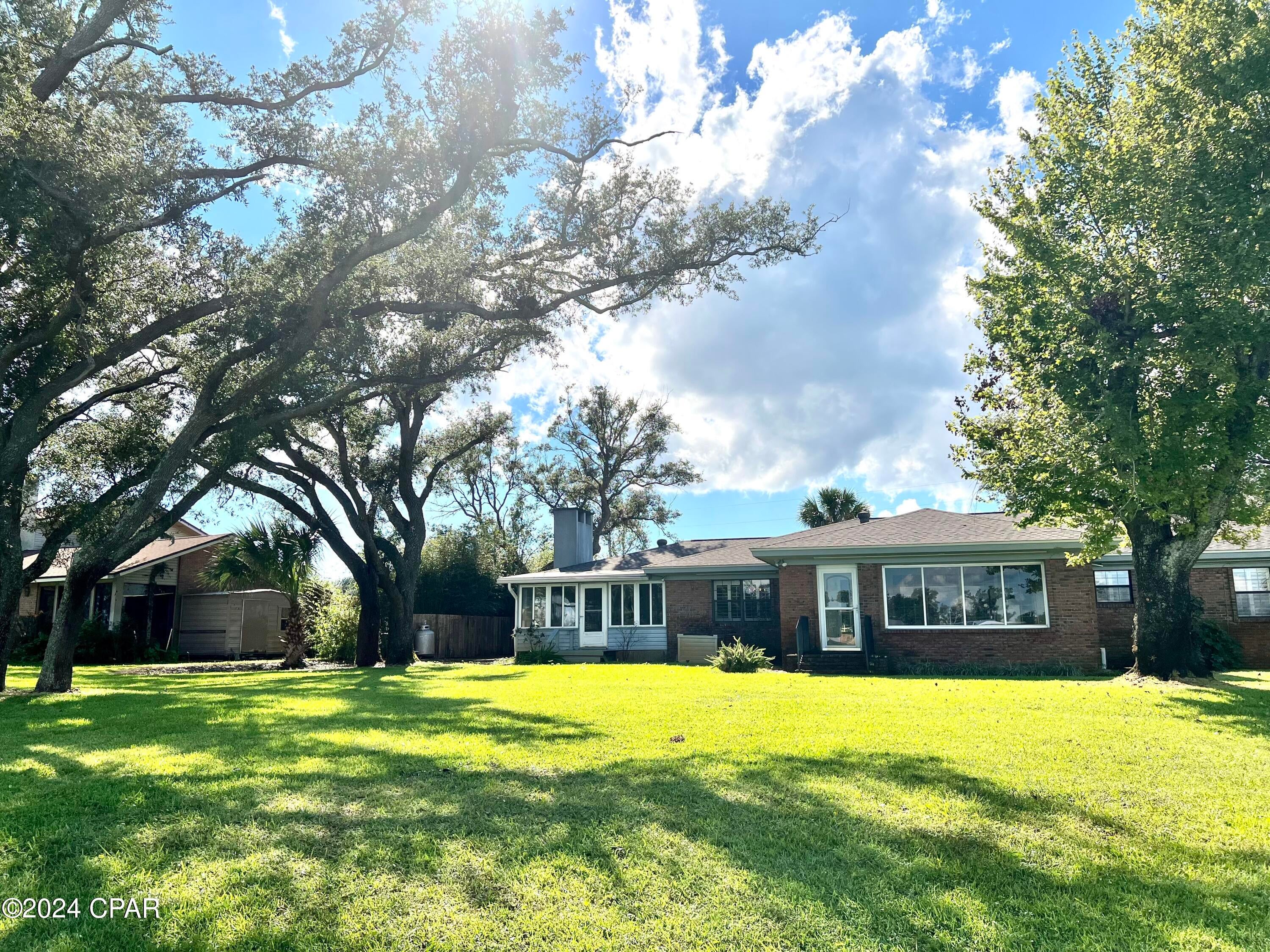 This is a beautiful home on Posten Bayou conveniently located off of 23rd street in a quiet neighborhood. This charming home has gorgeous views and easy access for fishing and water sports. Tie your boat up and enjoy a day at the island. There are 3 bedrooms, a formal living area as well as a nice den and Florida room. Original hard wood floors throughout the home. There is a separate laundry area and a two car garage with an additional covered parking area for another vehicle or boat. Florida room with water view and new mini split ac. This home has been freshly painted and is move in ready. Lawn maintenance is covered and included in rent so that tenants can enjoy the beauty!