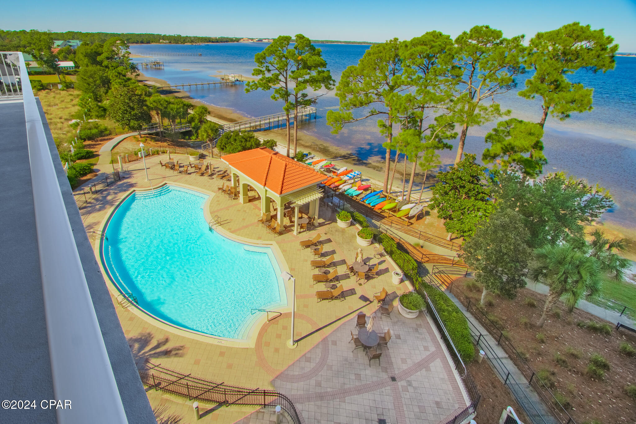 BAYFRONT LIVING AT MAGNOLIA BAY! Welcome to your coastal oasis at Magnolia Bay! This exceptional 3-bedroom, 3-bathroom condominium  nestled on the serene bayfront, offers a lifestyle of luxury and convenience. Featured are  two master bedrooms and private bathrooms, with an added bonus of a generously sized bonus room, perfect for a second bedroom or your home office. This condo features stainless steel VIKING appliances, custom granite countertops, tile and luxury vinyl plank flooring throughout, a custom marble wall under the kitchen bar area, plantation blinds and custom drapes, newer hot water heater , and newer HVAC and dishwasher. The open concept design seamlessly leads to an expansive, wrap around, corner balcony, inviting you to enjoy bayfront views, including those mesmerizing sunsets! This bay front condo is a coastal living haven, just a short boat ride away from the emerald waters of the Gulf of Mexico.  This gated community boasts a wealth of amenities for your pleasure to include a waterfront fitness room, a community room complete with a pool table and a pool that is heated during several months. For outdoor enthusiasts, a pier and kayak rack are available, ensuring you can make the most of the bay at your leisure. This unit comes with one covered parking space.  Don't miss the chance to experience bay front living in this splendid coastal condominium! As always, dimensions are approximate. Buyer to verify if deemed important.