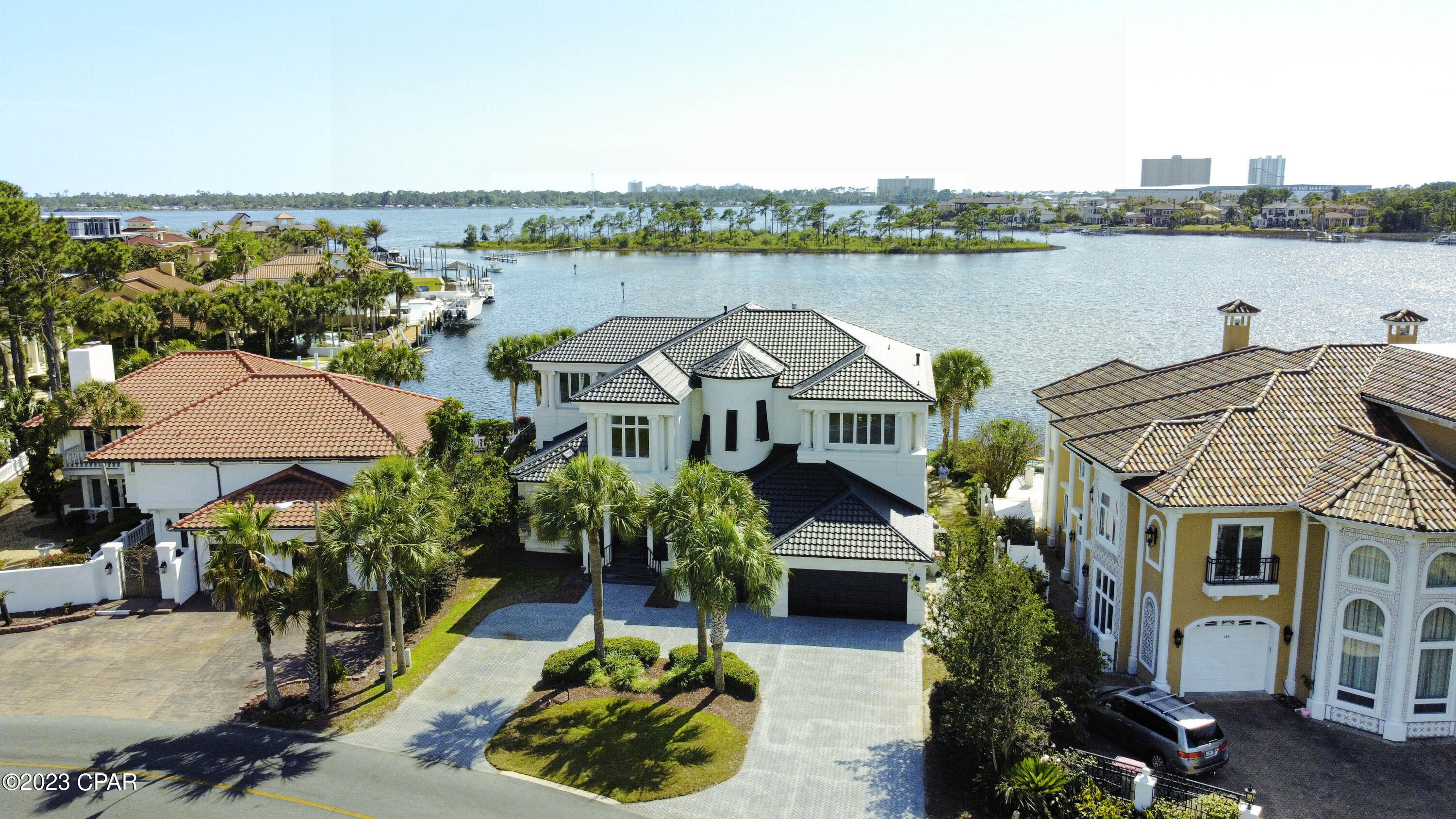 CURRENTLY UNDER CONTRACT, SELLER WILL CONSIDER BACKUP OFFERS. This passage describes a modern American home designed to evoke a sense of wonder, with exquisite finishes and breathtaking views of the Grand Lagoon from all angles. The property has 106 feet of deep-water frontage, a backyard dock, and a heated pool that offers indoor-outdoor living. The owners recently installed a changing room for your convenience when you are lounging around at the pool. The chef's kitchen features a waterfall black-honed granite center island and other high-end features like double ovens and a subzero. The main floors are adorned with marble of various depths and colors, while the master and second levels have contrasting black wood floors. The 3-car garage provides ample parking space and a circle drive with room for more parking as needed. 

Upstairs is a second master with a balcony, a game area, and additional bedrooms and guest suites with sitting rooms, balconies, and custom closets. This property's location is in the gated community of Bay Point, a guarded community with easy access to St Andrews Bay and the Gulf of Mexico. The site is ideal for fine dining, yachting, tennis, and golf. If you like to get involved in social clubs, we have so many to choose from, like The Yacht Club, Bay Point Women's Club, etc. This community is a lifestyle, and you will love all it offers.

The owner replaced the roof recently, installed new hurricane shutters on the outside windows, and installed a whole house generator—so many additions since they have owned the property. I have a list on file.