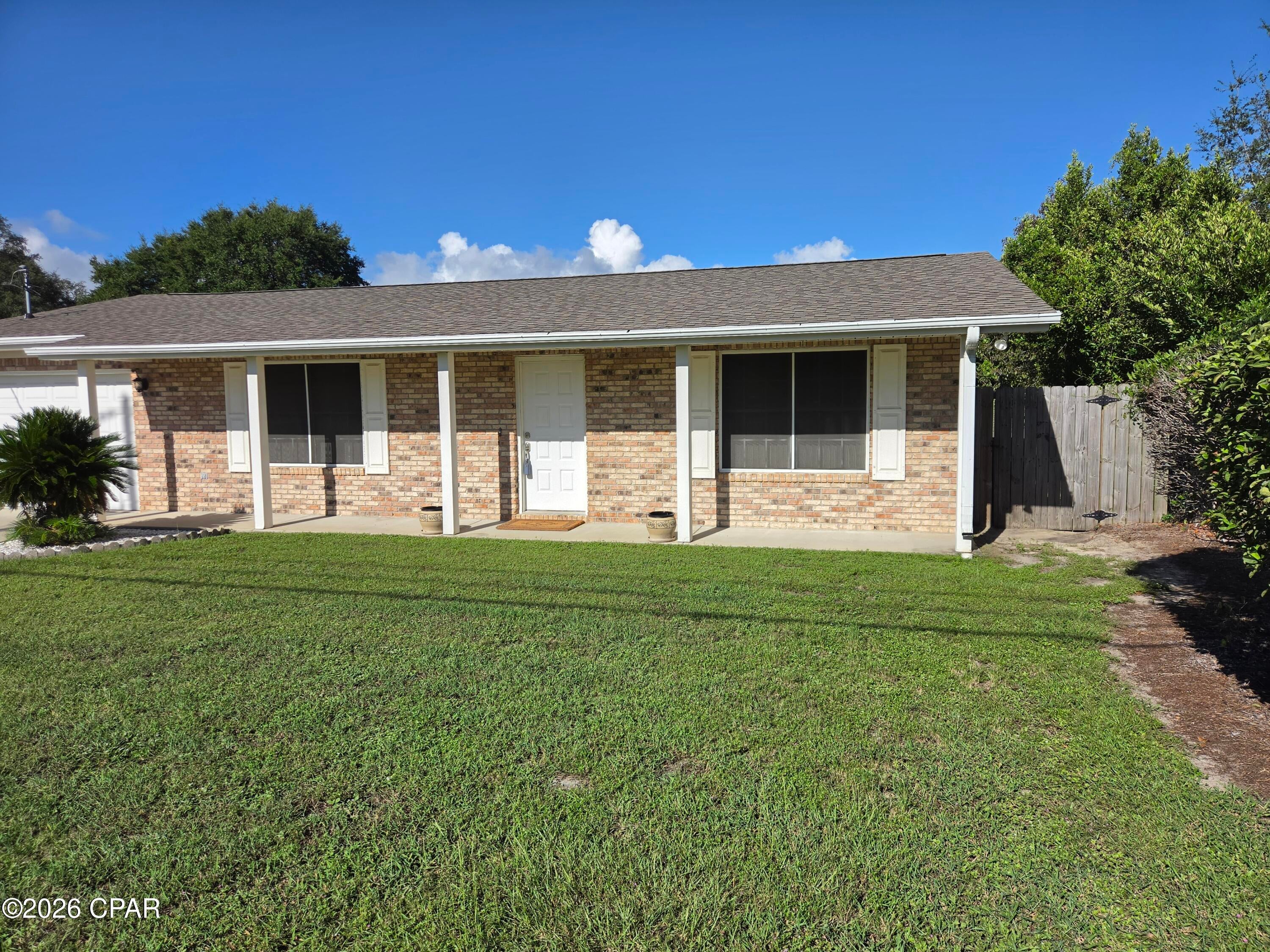 This home in the St. Andrews area is ready to move in. This 2 bedroom, 2 bath house features an attached garage, covered front porch, screened in back porch, and the back yard has a privacy fence. It was built in 2000 and been well maintained. It is flat, no steps, new roof in 2018 and leaf guards on the gutters, and the hot water heater was replaced in 2024. The big eat-in kitchen has a ton of cabinets, plenty of counter space, recessed lighting, stainless steel double sink, a wall oven, wall microwave, dishwasher and a refrigerator with ice and water through the door. All the appliances are Kitchen Aid. The garage has a sealed concrete floor painted gray with sprinkles for a neat appearance. Both bedrooms have carpet, and the living room and hall bathroom has new luxury vinyl plank flooring. There are 2 windows in the kitchen that overlook the privacy fenced back yard. The 12x12 screened back porch is a quiet place to relax. About 4 blocks is a cute park on St. Andrews Bay to watch the sun go down. Less than a quarter mile is St. Andrews Marina that has a variety of restaurants, shopping, free boat launch and parking. Come check it out!