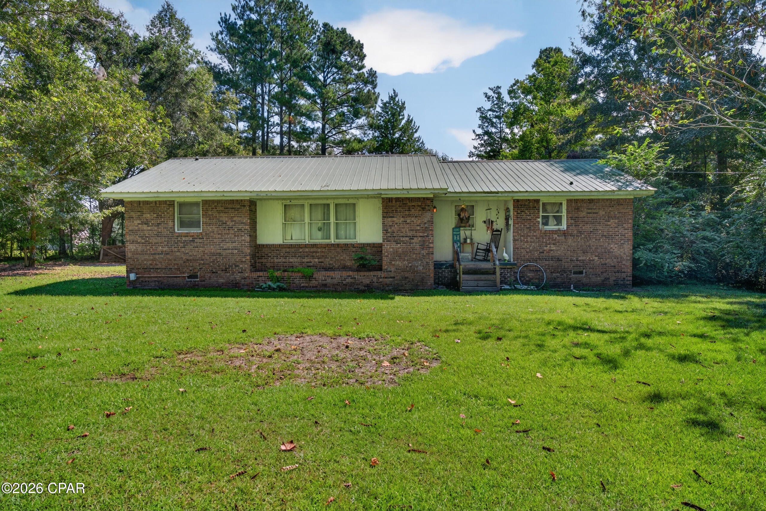 Tucked away down a quiet private road just outside the Chipley city limits, this 3-bedroom, 2-bathroom brick home offers 1,528 square feet of living space on 0.79 acres. Inside, you'll find a spacious living room, a separate dining room, and a nicely sized kitchen. The primary bedroom features an adjoining bathroom with a separate shower, while two additional bedrooms and a full bathroom provide comfortable accommodations for family or guests. Outside, the home features a metal roof, an attached two-car carport, and two storage sheds, providing plenty of room for vehicles, tools, and outdoor equipment. The spacious lot offers room to enjoy the outdoors, with wooded areas along the sides providing a sense of privacy. Conveniently located just outside the city limits, this property offers a peaceful setting while remaining close to shopping, dining, and other amenities in Chipley.