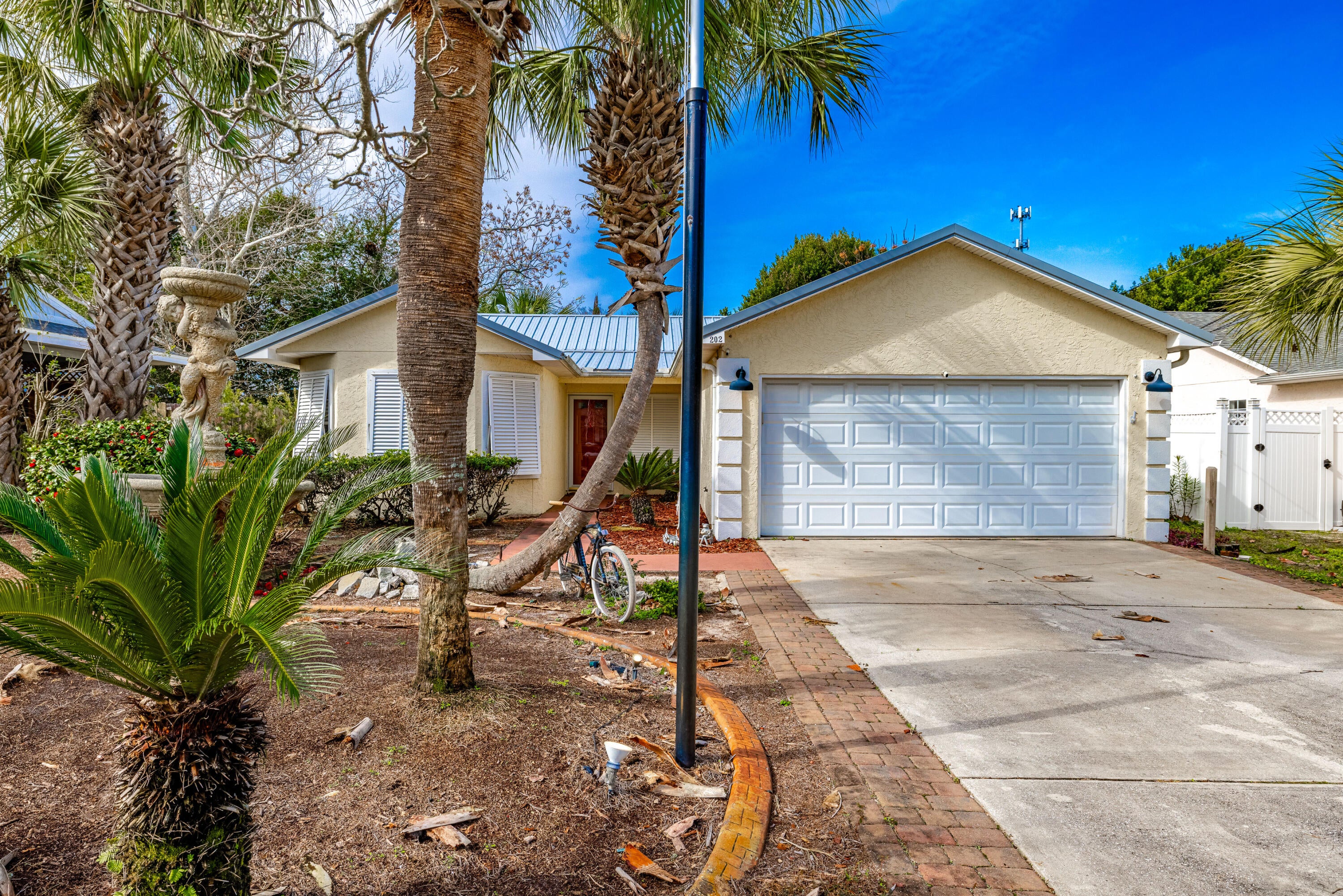 This Inviting 3-bed, 2-bath home is located within a few blocks from the beach, boasting 1,306 sq ft of heated and cooled space. This home Features a durable metal roof, 2-car garage, storm shutters, storage building, and a charming covered patio all without an HOA. Enjoy your privacy in this large backyard with a privacy fence, and most importantly NO HOA!! Inside, you'll find a modern kitchen that flows into the dining area with quartz countertops, updated cabinetry, stainless steel appliances, and stylish tile backsplash. The great room offers ample space, while the master bedroom dazzles with a private updated bathroom with updates such as a double vanity, quartz countertops, and updated cabinets. Additional bedrooms provide plenty of space for family and guests. Along with the updated additional bathroom to accommodate them.  Other highlights include updated garage floors, and a spacious backyard. This home is the epitome of coastal living and is a must see!