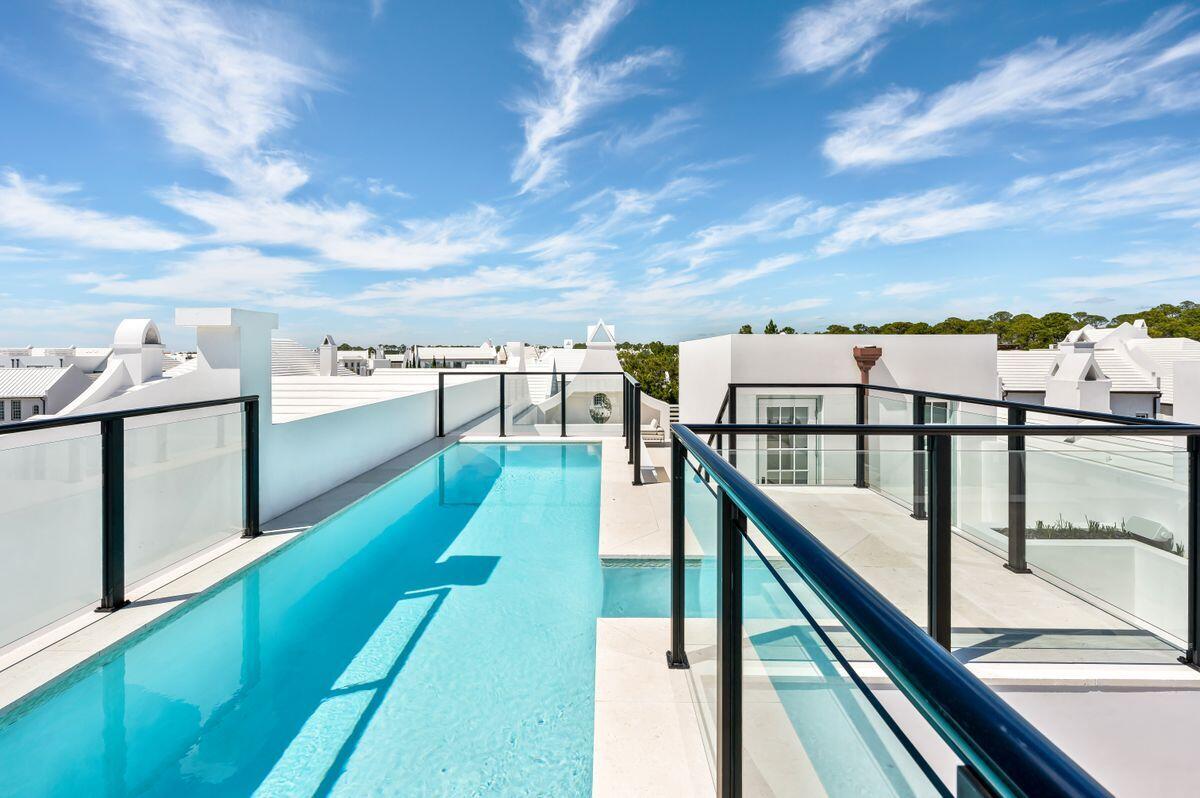 Sophisticated architectural styling beautifully paired with an unparalleled living experience perfectly characterizes this exceptional Alys Beach new construction. Ideally sited equidistant to Caliza Pool & Restaurant, Zuma (fitness/pool/spa/cafe), the tennis center, the entrance to the nature trails, and the Alys retail amphitheater. The newly completed and ultra-exclusive Alys Beach Club is a straight jaunt toward the gulf. This custom home was designed by Stackable/Mracek and built by Galvas Construction, featuring an exceptional 2,200 square feet of outdoor space including a 16-ft. rooftop fireplace and a south-facing rooftop pool with panoramic views of Alys set against the gulf. The creative design and extreme structural engineering of this home are one-of-a-kind in all of Alys. The result is the uniqueness of a 9-ft.-by-27-ft. rooftop pool that is five-feet deep, a full outdoor kitchen with luxurious al fresco dining, living, lounge and storage spaces. The courtyard features a stunning 20-ft. shell-stone water wall topped and flanked with gorgeous plantings. The courtyard design cleverly creates a three-story skylight flooding the common areas and en suite bathrooms with natural light. Relax and entertain with expansive sunset views and a Sonos sound system that includes the rooftop, master suite and interior common areas. The front elevation features a gas lantern-lit beveled entry below a Juliet-balcony and latticed porthole through which to view the dancing flames of the rooftop fireplace. The second-story bay lends way to the perfect rooftop perch to enjoy Alys's stunning white architecture set against the blue of the gulf. 

Inside, this well-planned home is just as innovative, with 2x2 shell-stone transitioning to rich double-matte finish black walnut plank flowing up the stairs and across the second-floor lounge into luxury bedrooms and en suite bathrooms. The design echoes the use of symmetrical grain black walnut in the wine bar of the lounge as well as the kitchen cabinet uppers and island which are grounded by matte black lower cabinets. The black suede island and white quartz countertops create a dynamic gourmet kitchen that is both practical and stylish. A two-car garage, wet room, spacious laundry, spare bunk room/office and deeded beach access round off the added benefits of this outstanding residence, which is set to become a local landmark. With the added attraction of the owner's only beach club, 30A living, and upscale shopping and dining a very short walk away, this home delivers a highly coveted lifestyle. This never-before-occupied home is being delivered fully furnished and stocked for its new owners.