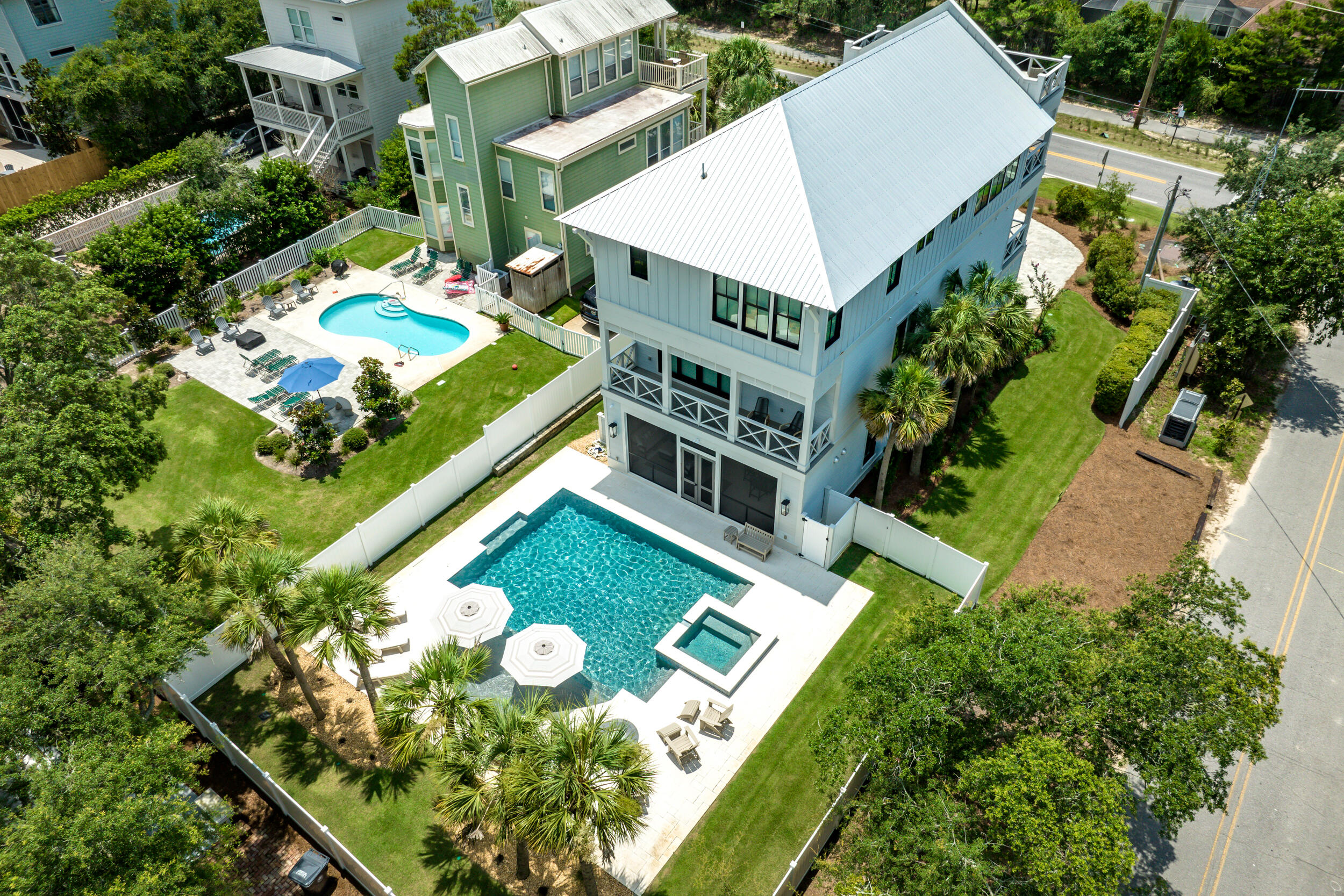 Step into a stunning 2023 newly constructed, never rented home directly on 30A, designed for luxurious coastal living and effortless entertaining. Nestled on a spacious corner lot, this thoughtfully designed three-story retreat boasts one of the largest private pools on 30A, a rooftop terrace with panoramic Gulf and Camp Creek Lake views, and nearly 1,840 sq ft of outdoor porches and living space. Whether you're relaxing or hosting, every detail of this home is elevated and intentional.

An elevator provides easy access to every level, from the expansive first-floor entertainment areas to the top-floor main living space, where 18' vaulted ceilings, exposed rustic white oak beams, and custom oversized windows frame breathtaking Gulf and dune lake views. The open-concept living room is anchored by a striking floor-to-ceiling fluted tile fireplace, a 65" TV, SONOS soundbar, and a pair of sliders that lead out to a large covered deck and rooftop terrace. A spiral staircase offers additional access to the 4th-floor rooftop, ideal for sunset cocktails or morning yoga.

The gourmet kitchen is a showpiece with a massive 130" x 60" charcoal suede Silestone island, paneled oversized refrigerator/freezer, Thermador appliances, Blanco Silgranite sink, Zellige tile backsplash, and Kelly Wearstler designer pendants. A built-in wet bar completes the space, making entertaining seamless.

The first level includes a spacious game room with barn door entry- easily converted into an additional bedroom- with a full bath featuring a gorgeous concrete trough sink and walk-in shower. Slider doors lead to the screened-in outdoor kitchen and living area, which includes a NatureKast 60" grill, Blaze refrigerator, and an 80" TV overlooking the show-stopping custom Gunite pool and spa, designed with sundeck, bubblers, spa jets, PebbleTec finish, and Hayward automation.

A built-in drop zone near the pool provides the perfect place to stash beach towels and outdoor gear after a day in the sun. The primary suite, tucked privately at the back of the home, is a true sanctuary featuring a wood accent wall, beamed ceiling, stylish pendant lighting flanking the bed, and slider doors that open to your backyard oasis. The primary bath offers a spa-like experience with a freestanding soaking tub, custom inset cabinetry, Silestone quartz countertops, and beautiful tilework throughout.

On the third floor, the junior primary suite rivals the main suite in luxury, with its own beamed ceiling, wood accent wall, and designer finishes. All bathrooms throughout the home include Delta fixtures, under-cabinet lighting, and high-end tile selections.

Additional features include:
- 10' ceilings on every level
- Two laundry rooms for convenience
- Sierra Pacific FeelSafe hurricane-rated windows and sliders
- Three Carrier Infinity HVAC systems with WiFi and Ideal Humidity
- Automated Alta Bliss shades in all bedrooms, game room, dining area, and stairwell
- Full home SONOS speaker system in kitchen, living room, decks, porches, and primary bath
- Smart wiring, a security panel, and outdoor video surveillance for peace of mind

This one-of-a-kind home perfectly blends modern coastal elegance with comfort and practicality- all directly on Scenic Highway 30A. Whether you're entertaining guests, enjoying quiet mornings by the pool, or taking in the Gulf breeze from the rooftop deck, this property is built to impress at every turn.