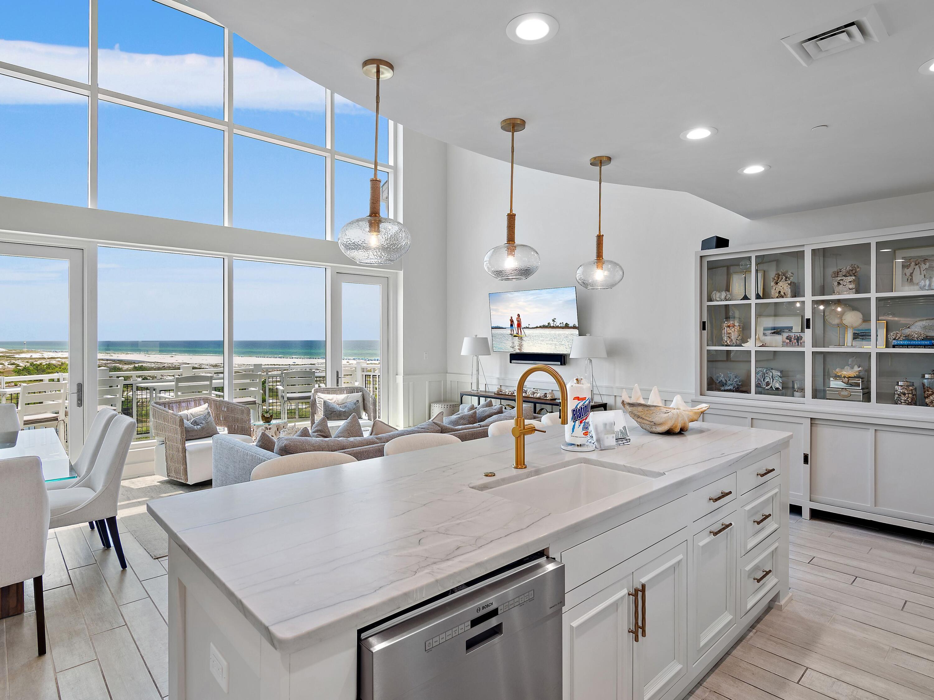 This gulf-facing condominium in WaterSound Beach breaks away from traditional coastal design and delivers a dramatic architectural statement centered entirely around light, space, and sweeping views. Positioned high above the rare coastal dune lakes, this luxury residence offers unobstructed Gulf and lake vistas through soaring two-story windows that flood the interior with natural light. The main living area features 20-foot ceilings and an open layout that seamlessly connects the sitting area, dining space, and a newly reimagined kitchen—each framed by breathtaking coastal scenery. Step onto the private balcony to feel the Gulf breeze and take in the ever-changing water views, from sunrise to sunset. Completely renovated to the highest standard, the condo showcases fresh coastal finishes, custom lighting, and new paint throughout, creating a crisp, modern aesthetic. Three new HVAC systems provide comfort and efficiency year-round. The main level includes a guest bedroom and an updated bathroom with a tiled shower, ideal for visitors. The chef's kitchen is both stylish and functional, featuring new custom cabinetry, quartz countertops, and premium appliances, including a Viking refrigerator and range, plus a Bosch dishwasher. A built-in bar creates a natural gathering spot for evening cocktails, while the dining area comfortably seats six.  A mezzanine loft overlooks the living space below, offering a flexible bonus area with a sleeper sofa and TVperfect for additional guests or a relaxed lounge. The open railing preserves sightlines to the Gulf, keeping the views front and center. On the lower level, a guest suite with an updated walk-in shower bath provides privacy and comfort. Just beyond the laundry area, the primary suite is a true retreat, featuring its own sitting area, a completely redesigned spa-style bathroom with a freestanding soaking tub, seated vanity, and fully tiled walk-in shower. The primary suite also opens to a private balcony, ideal for morning coffee or quiet evenings with a book. Offered fully furnished with a proven rental history, this residence is perfectly suited as a luxury investment property, second home, or full-time coastal residence. A detached garage provides valuable storage for golf carts, beach gear, and bicycles. Residents enjoy access to WaterSound's premier amenities, including private beach access, multiple pools, golf, tennis and pickleball courts, a wellness center, dining, and boutique shoppingoffering a refined coastal lifestyle unlike anything else on 30A.