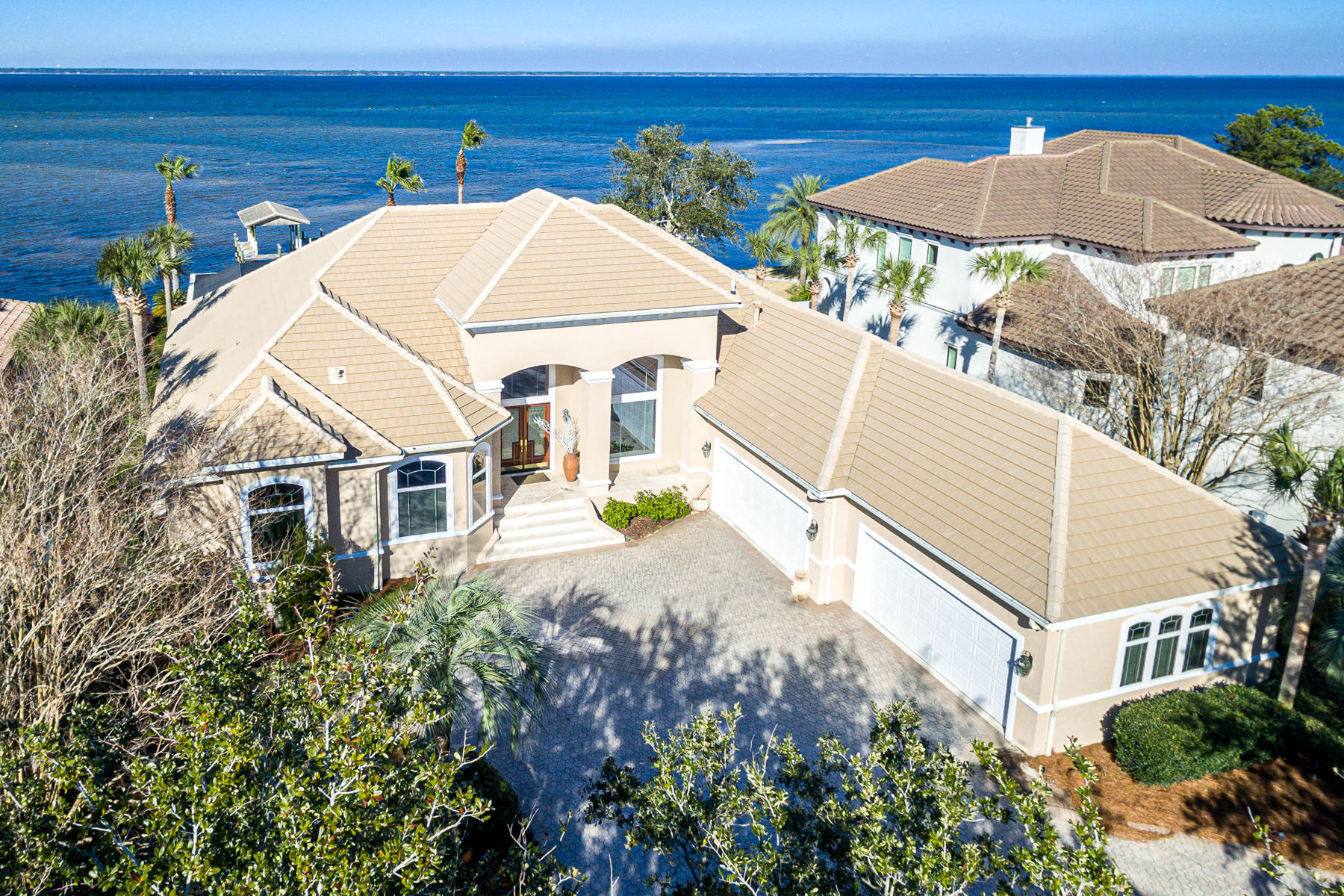 Still showing property and accepting back up contracts until contigencies have been met.
Rarely on market, bay front, single-level living in prestigious Regatta Bay.  Over 100 spectacular feet of bay frontage includes private dockage and is equipped for lift equipment.  Large windows and an open-layout frame calm bay waters and blue skies for a dramatic entry.   High ceilings and updated lighting are ready for your decorative touches. A convenient screened-in lanai features a  pool, spa, and summer kitchen. The luxurious chef's kitchen combines modern conveniences and open styling for the ultimate gathering space .  Timeless granite counters and backsplash, a center island with gas cooktop, downdraft, Bosche dishwasher, Jennaire refrigerator, double ovens, warming drawer, built-in desk and a huge walk-in pantry will satisfy the most discriminating cook. Centrally located between the family room, living room, and formal dining, the kitchen streamlines entertaining. A walk-through wet bar includes an icemaker and wine cooler. For privacy and comfort, two living both include fireplaces and access to the lanai.  The master suite is spacious and well appointed with a tray ceiling, sitting area, fireplace, and access to the lanai. The bath is an at-home spa retreat with custom cherry cabinetry, a large walk-in shower, and double closets. Floors in the main living areas are travertine, with carpet in the master and two guest bedrooms. A dedicated office provides custom hardwood cabinetry.   A third guest room is waterfront and has travertine floors, could be used as a hobby room, art studio or exercise room. A large heated and cooled bonus room above the garage is perfect for a game room, theater, or storage. A circular driveway and 4-car garage provide ample parking. Additionally, this home features plantation shutters, security system, central vacuum, and 8-ft doors. Regatta Bay is an exclusive, guard-gated golf community in East Destin with an acclaimed 6894 yard golf course, golf club, in-club dining, two tennis courts and pickle ball courts. Golf cart to the beach, shopping or restaurants. Call for your appointment to see this fine home.