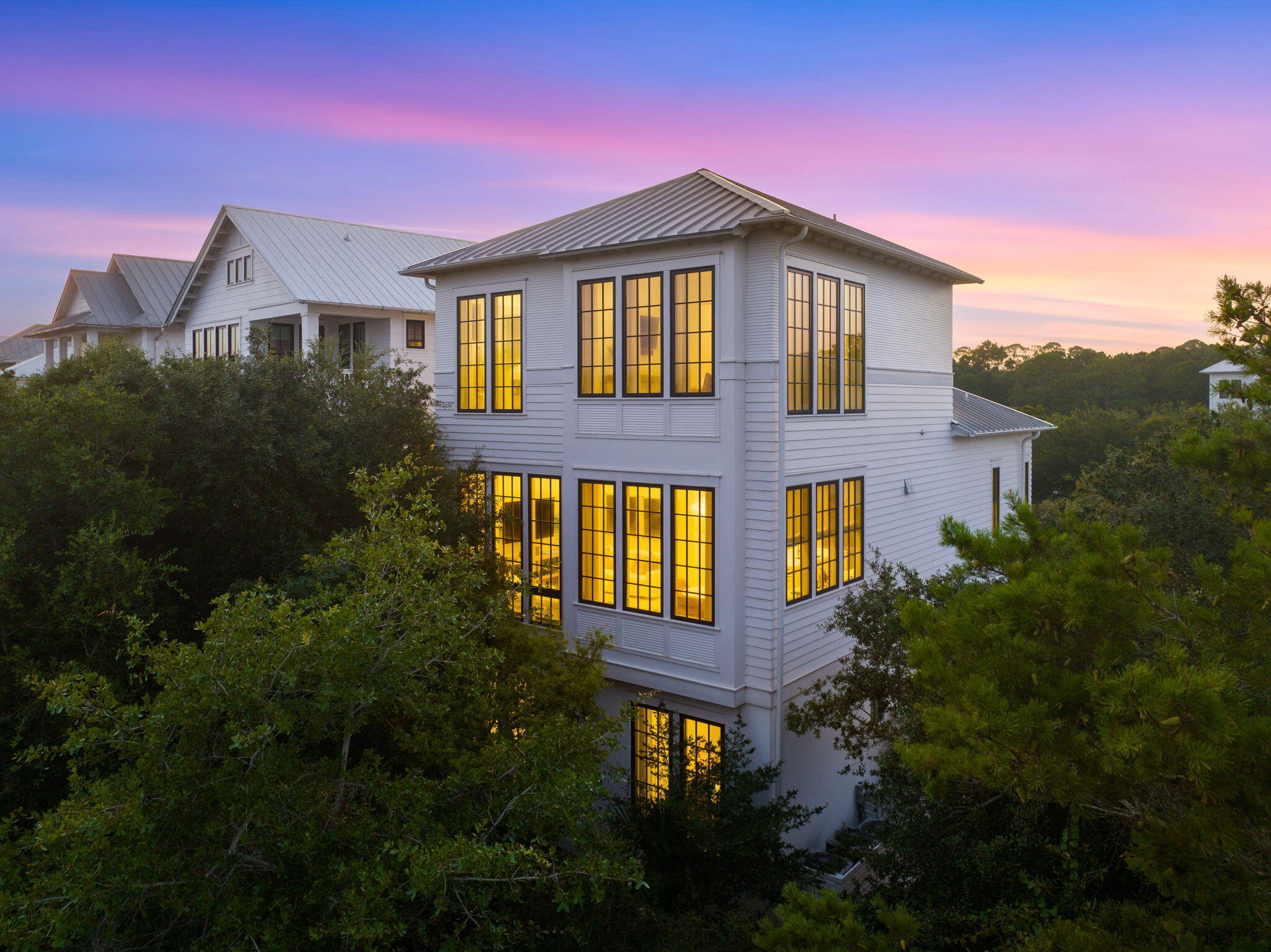 Primely positioned behind the gates of SeaNest Village in Seagrove Beach, sits 191 Sand Oaks Circle. Exclusively offered as one of only forty-seven homes within the village, this custom built 2018 residence was craftily designed by architect, Brian Stackable, and masterfully appointed by design firm, Colgan Simon. A combination that together has created the epitome of modern coastal luxury.

Upon entrance to the home, your eyes are drawn to the beautiful white oak wood floors, 10' ceilings, solid-core 8' doors and private elevator. The reverse floor plan grants access to a one-car garage, a reimagined entertainment space, and guest suites along the first level. You'll notice the media room has created additional living space for the home and features a fully-functional wet bar and kitchen-aid appliance package. Creating a perfect escape for a football watch party, or home theater experience. 

Mirrored guest bedrooms lie along the back-side of the residence offering custom built in cabinetry and overflowing with natural light from the floor to ceilings windows. Each of the bedrooms offer a private ensuite experience with tiled glass door walk-in shower, and quartz countertops. 

The laundry space completes the first floor and grants ample storage along with direct access to the paver lined backyard, outdoor shower and seating area with fire table. 

Along the second level of the home you'll find the open concept main living space bathed in natural light from the window walls to perfectly highlight the wooden beams, 12' ceilings and custom lighting package. The Chef's kitchen was crafted for a culinary artist and features an expansive kitchen island with waterfall quartz countertops, breakfast bar seating, a high-end stainless steel appliance package with gas oven, Venetian plaster vent hood, wall lined custom cabinetry, with integrated wet-bar, and working pantry. Perfectly planned with entertainment in mind, you'll seamlessly move from the kitchen to the living room to find sonos surround sound, custom floating shelves, and abundant seating arrangements.

An additional guest primary bedroom can be found on the second level with work space opportunity and private ensuite that features floating dual vanity countertops, custom shelving, and walk-in steam shower. As well as a convenient powder room with custom poured concrete sink. 

On the final level of the home you'll find the true primary escape lined with floor to ceiling windows that perfectly capture the peek-a-boo Gulf-views, and create a sense of open-ness and peace in the home. The primary suite also showcases a true- walk-in closet with custom shelving and second laundry, a spa-like ensuite with walk-in glass door shower, rain water feature, dual vanity sinks with waterfall quartz countertops, and private water closet. 

With every detail fully executed to the summation of luxury design, 191 Sand Oaks Circle stands distinguished in every fashion. Including the resort style amenities available in this private community such as the multi-tiered infinity pool, deeded beach access for owners and accessibility to Point Washington State Park. **Additional images coming**