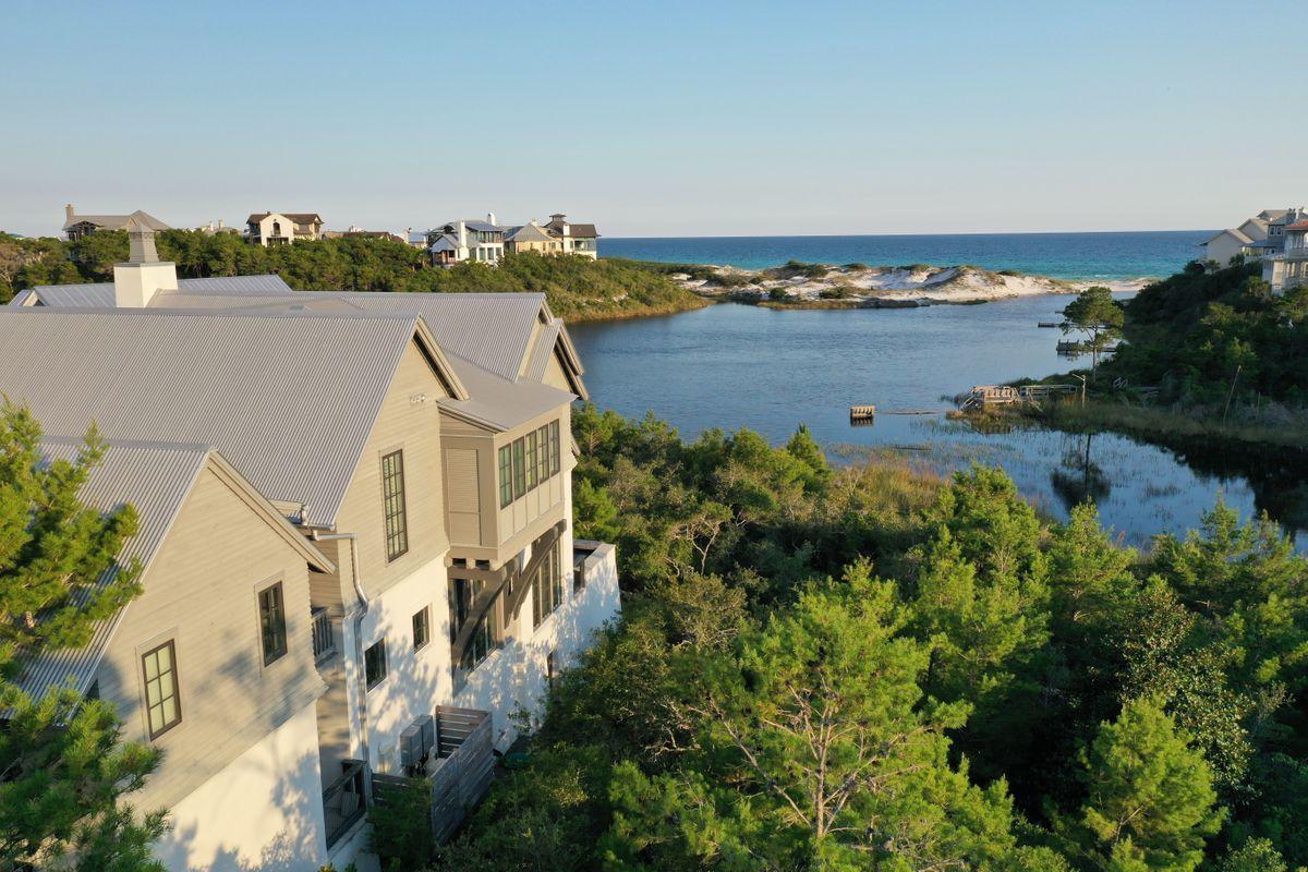 Nestled within the gated Draper Lake Coastal Village, this sophisticated lakefront home offers high-quality construction and designer finishes with killer views of the Gulf of Mexico and Draper Lake. Designed by Domin Bock Architects, the first level of this home features an open floor plan with 12-ft ceilings featuring exposed beams in the main living area, oak flooring, a wet bar, and a chef's kitchen with Wolf and Sub-Zero appliances. Four sets of French doors in the main living area frame a picturesque outdoor living area with an infinity edge pool that appears to spill into the lake. An upstairs porch provides a private place to enjoy unparalleled vistas. This five bedroom home offers a guest bedroom downstairs, a master suite with his and hers closets, two additional bedrooms upstairs, media room and a completely separate guest suite in a carriage house over a one-car garage.

Draper Lake Coastal Village residents can take advantage of several neighborhood amenities, including multiple pools, nature trails, and an observation tower. Enjoy living in a private community with no short-term rentals and in close proximity to everything iconic 30A has to offer. Draper Lake Coastal Village is rental restricted to no rentals less than 30 days.