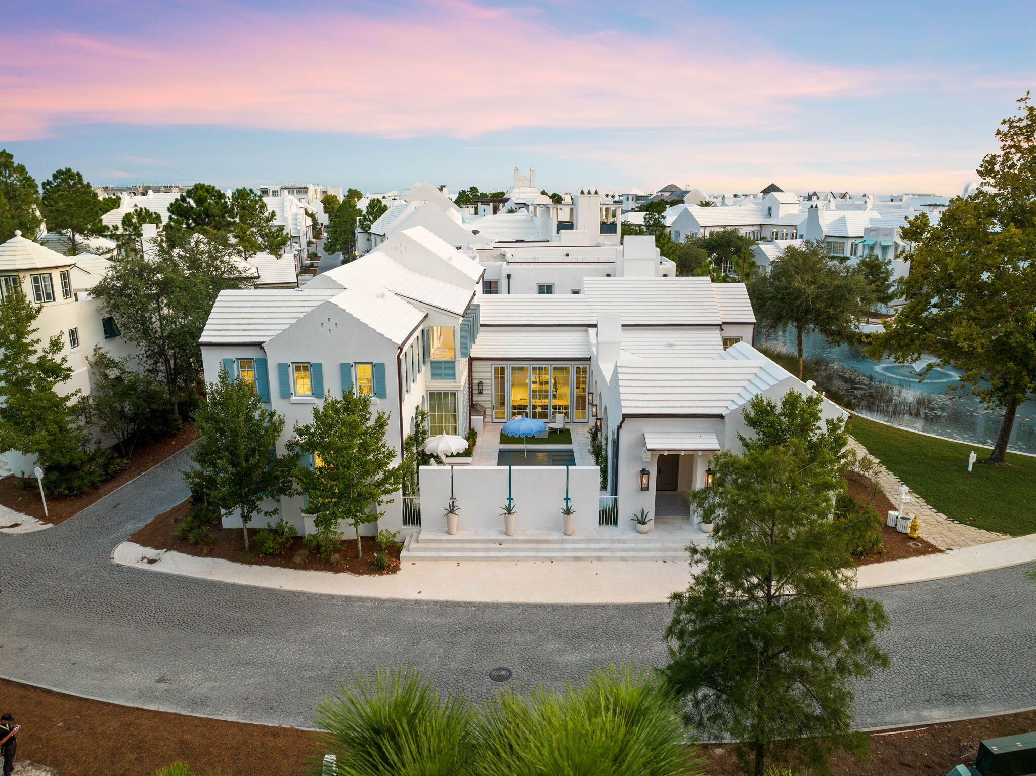 Nestled within the especial community of Alys Beach, 285 N Somerset Street stands as a timeless masterpiece of coastal luxury and elegance whilst channeling the captivating blend of Greek-inspired architecture, artistic elegance, and fortified construction. Upon initial approach, the cobblestone drive and gas lantern-lit entry lead way to the true four-season living corridor lined with bi-fold doors while providing seamless access to the main residence which spans over five thousand square feet in addition to the courtyard, dedicated outdoor dining area, and separate guest quarters. Bordered by lush vegetation overlooking the preserve area to the North, Lake Marilyn frontage to the West, and anchored by one of the largest private pools within the community, the courtyard provides a true oasis perfectly positioned to capture the coastal breeze and famed Emerald Coast sunsets providing a new palate of mesmerizing hues each and every night. An outdoor kitchen outfitted with a Twin Eagles Grilling station, a sunning deck, and a turfed conversation area are also nestled within the courtyard.

Upon entering the main residence, attention is immediately drawn to the array of hand-selected exotic finishes and expertly curated interiors planned by the acclaimed Dallas-based team at SHM Architects and executed by the esteemed design team at Avrea and Company. Soaring pecky cypress-lined ceilings, Venetian plastered walls, a floor-to-ceiling window wall providing abundant natural light, and a fully equipped wet bar accented with stunning Zellige tilework define the living area.

Abutting to the living area, the gourmet kitchen boasts custom cabinetry with Rocky Mountain Hardware, an oversized island with waterfall marble tops and integrated seating, a walk-in pantry, and a custom-crafted dining table with seating for ten. The luxury appliance suite includes dual Sub Zero refrigeration, an Officine Gullo range imported from Italy, and dedicated wine refrigeration.

Accessed by a pivoting door that doubles as a work of art, the first-floor main suite encompasses a sitting area, direct access to the courtyard, and a sumptuous ensuite with dual vanities, custom tiled wet room with steam generation, soaking tub , heated marble floors, separate water closet, and an expansive walk-in wardrobe. Two powder rooms, a laundry area, and a two-car garage complete the first level.

Situated on the second level, the sprawling bunk room was configured with family gatherings in mind offering sleeping accommodations for eight in addition to the attached ensuite with the custom three-fixture vanity, contrasting blue tiled wet room, and separate water closet. Two additional fully equipped guest suites are also found on the second floor along with the shuttered outdoor patio overlooking the courtyard and preserve.

Reigning on over one hundred and fifty acres along Scenic Highway 30A, the master-planned community of Alys Beach affords residents with a culmination of amenities including access to the sugar white sand and iconic turquoise-hued waters, the distinguished Caliza pool, the Zuma wellness center, a twenty-two-acre nature preserve, an exclusive beach club, and the vibrant town center with world-class dining and shopping venues. The meticulously planned interiors coupled with the peerless finishes and prime homesite placement offering a heightened sense of privacy make 285 N Somerset Street a unique and compelling opportunity for investors and full-time residents alike. Inquire today to coordinate a private viewing and start living the coastal lifestyle you deserve.