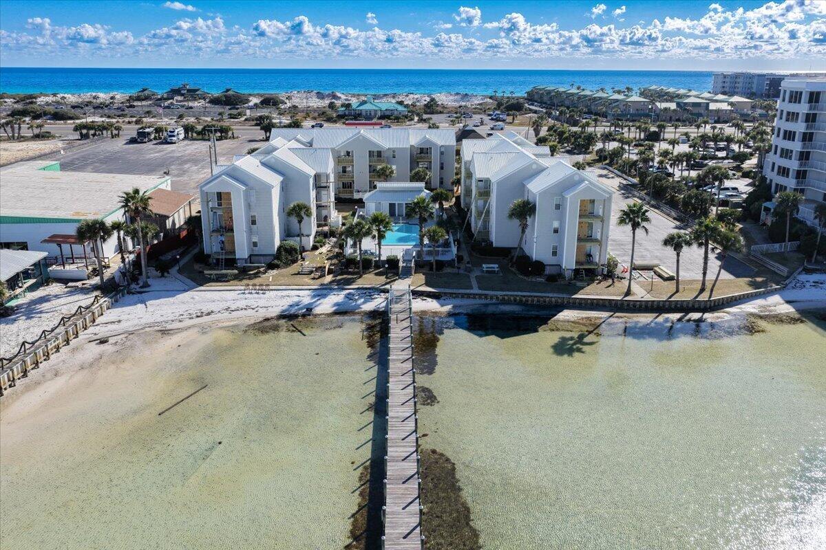Discover the perfect blend of coastal living and investment potential in this 2-bedroom, 2-bath condo on Okaloosa Island. This second-floor unit offers views of the Choctawhatchee Bay and the community pool from the private balcony. The open floor plan features LVP flooring in the main living areas and tile in the bathrooms. The kitchen includes stainless steel appliances, and the washer and dryer convey. Sold turn-key, this condo has SHORT-TERM RENTAL potential. Community amenities include a bay-front in-ground pool. Low maintenance ownership with HOA fees covering water, sewer, internet, and landscaping. New balconies have recently been installed. Located on Okaloosa Island across from John Beasley Beach Park and adjacent to Gulf Islands National Seashore.