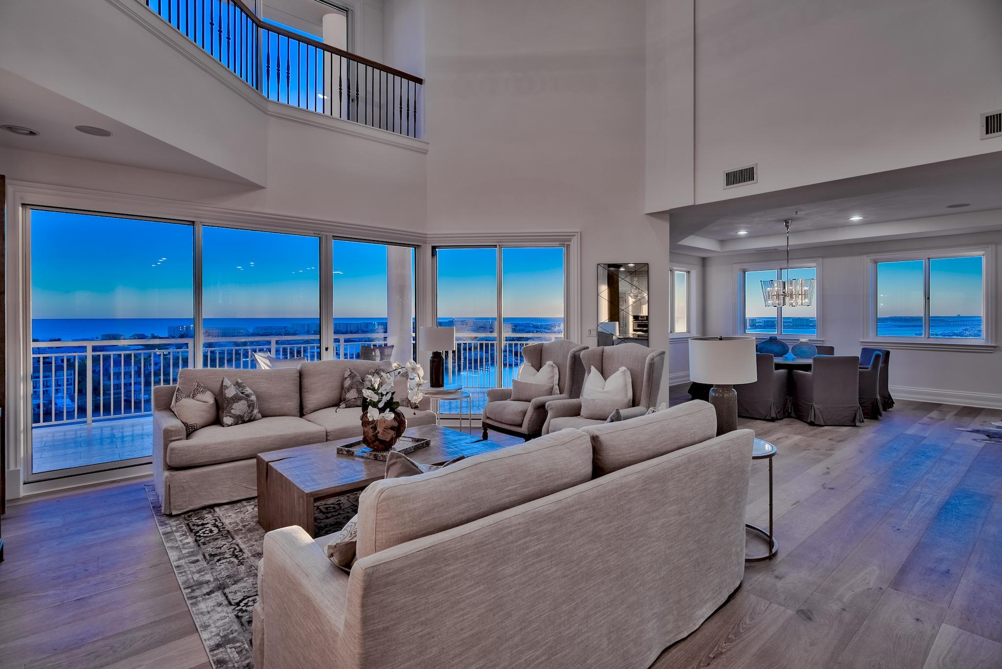 Stunningly and completely renovated top-floor penthouse with a 70-ft boat slip in Grand Harbor, Destin's exclusive condominium community with 500 ft of private waterfront and deluxe amenities. This west-end corner unit occupies the most desirable location in the building, offering complete privacy and an incomparable vantage of the Gulf of Mexico, the Harbor, and the Destin Bridge. Every inch of this 4,800-sqft redesign by acclaimed Swift Construction was carefully considered. The warm white designer kitchen with quartz countertops, rustic wood base cabinets, and metallic backsplash is light, bright, and classic. All baths are stylish and serene with high-end tiles and fixtures. New hardwoods throughout accent a strikingly reconfigured stairway. White-sand walls, natural wood accents, and custom, see-through light fixtures allow west and south facing waters to take center stage. Two stories of deep terraces and dramatic ceiling heights with large expanses of glass command one-of-a-kind views. Dual master suites offer harbor views, balcony access, and spa-like baths with soothing materials, luxury finishes, and large, walk-in showers. A new, custom-designed serving bar with dual wine fridge adds entertaining space to the dining room. A media room is pre-wired for future entertainment needs. A dedicated office features pocket doors for privacy. This unit includes a mudroom for boating and fishing equipment storage. Rental restricted Grand Harbor offers premier amenities including 2.5 acres of land space, a heated, waterfront pool, private boardwalk, conference room, fitness facility, parking garage, gated entry, and a traffic light at its entrance. 4 bedrooms, media room, and office have been virtually staged to provide perspective on the size of the space.