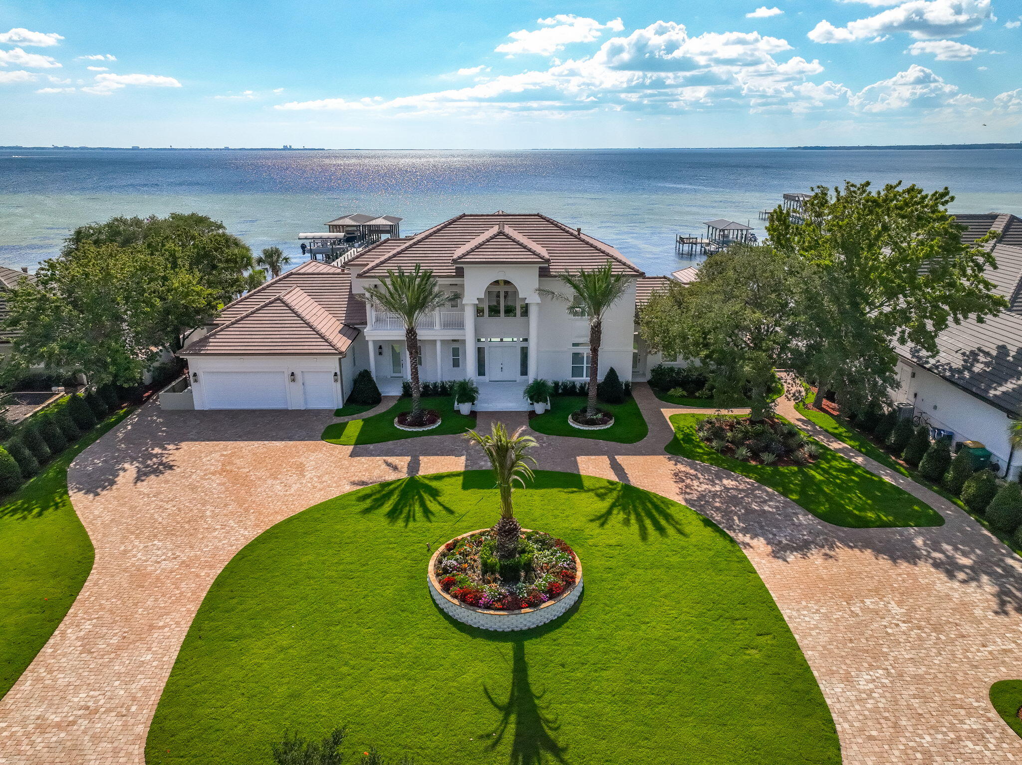 Welcome to 6 Sunset Beach Place, an extraordinary bay front estate in the gated community of Sunset Beach within Bluewater Bay. Set on nearly an acre of land with 151 feet of pristine waterfront overlooking beautiful Choctawhatchee Bay, this 6 bedroom, 6.5 bath dream home offers 6,424 square feet of luxury living. Every detail has been professionally designed and no expense spared with over $1.8 million in thoughtful renovations blending timeless architecture with modern sophistication.
Almost every room provides gorgeous panoramic views of the bay. This home features new engineered hardwood and designer tile flooring, 12-foot ceilings on the first level and 10-foot ceilings on the second level, solid wood interior doors, arched openings, and plantation shutters throughout. The expansive open-concept layout includes a chef's kitchen with white oak cabinetry, marble countertops, Thermador professional appliances, an imported French oven, and a butler's pantry with custom built-ins and quartz accents. A coffee and wine bar and prep kitchen provide added convenience for entertaining.
Elegant living spaces flow seamlessly to the outdoors, where expansive patios and balconies capture stunning bay views. The sparkling pool and hot tub with new PebbleTec finish offers a more natural texture that delivers enduring elegance and durability.  A brand new outdoor kitchen, complete with a premium Coyote grill and appliances, sets the stage for unforgettable outdoor dining. Featuring elegant Taj Mahal quartz countertops, sophisticated Synergy wood details, and convenient remote-controlled awnings, it's the ultimate setting for any gathering while the fire pit and 12-color programmable pool lighting add to the ambiance. The air conditioned pool house offers a full bathroom, changing area, and shower.  
Every mechanical system has been upgraded, including five HVAC units, new water filtration and soft water systems, a Generac generator, impact-rated sliding glass doors, and a new concrete tile roof. The insulated and air conditioned oversized 3-car garage features new doors, epoxy flooring, and abundant attic storage.  Expanded parking added offering plenty of space for family, friends, and entertaining guests.  Smart technology enhances comfort and security with a full camera system, doorbell, sound system, and smart lighting throughout.
Designed by Amy Killebrew of Sinkler Designs, the home showcases $320,000 in custom ArtisanBilt cabinetry, Taj Mahal quartz, marble finishes, and designer fixtures. Two new gas fireplaces, located in the living area and primary suite, add warmth and charm. 
The west wing offers a private kitchenette and entrance, ideal for guests or multigenerational living.
Outside, the reimagined landscape adds a southern tropical oasis featuring gorgeous palm trees, plants and trees designed for privacy and low maintenance.  Professional lighting, brick pavers, and custom gates. 
Enjoy bayfront living with a shared dock and boat lift, perfect for days spent on the water.
Sunset Beach is an highly sought after neighborhood known for its serene lakes, fairways, and bayfront homes. Residents enjoy access to a private clubhouse, pool, and beach overlooking the bay, along with the amenities of Bluewater Baytennis courts, a marina, boat launch, and championship golf. Ideally located near the Mid-Bay Bridge, this home offers quick access to Destin's sugar-white beaches, fine dining, and entertainment while remaining just minutes from Niceville's top rated schools and Eglin Air Force Base.
6 Sunset Beach Place is more than a homeit's a statement of refined coastal living in one of the Emerald Coast's most desirable communities.