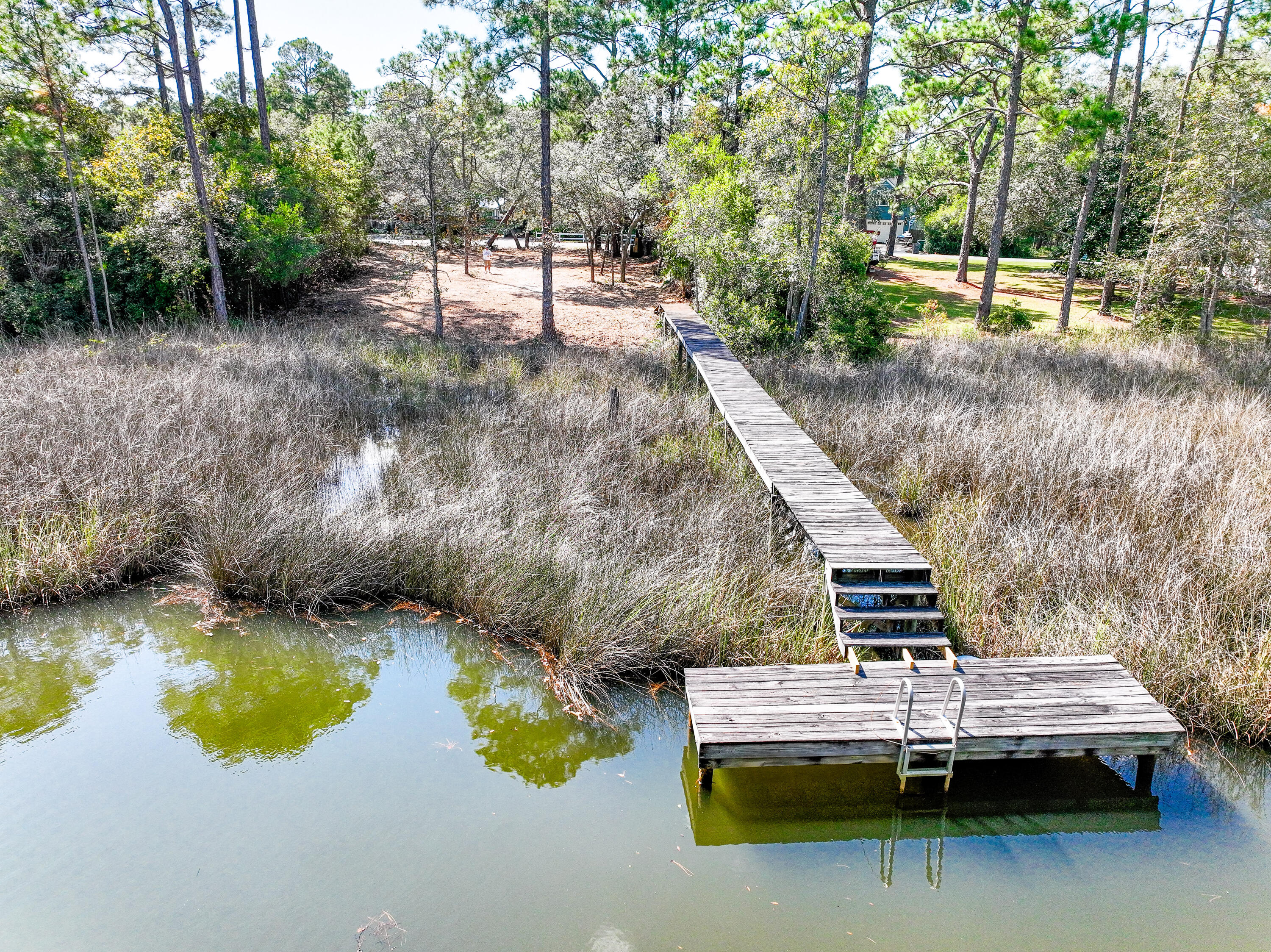 Discover your slice of waterfront serenity in the exclusive community of Bayâ¯Pineâ¯Shores. This rare half acre+ homesite is nestled along a tranquil canal with direct access to Choctawhatcheeâ¯Bay, ideal for building your primary residence or a dreamy vacation retreat.

Picture mornings on your private dock (with an estimated 4'+ water depth) casting a line, paddling a kayak, or boarding your SUP. The peaceful bayou offers a perfect backdrop for boating, fishing, and water adventures.

Location is key: you're minutes from the sugarâ'white beaches, vibrant shopping, fine dining and the full lifestyle found along Scenicâ¯Highwayâ¯30A. The lot has been recently cleared for easy visualization of your future home â' come walk the grounds & imagine your life here!  Buyer to verify all information. Flood Zone AE
