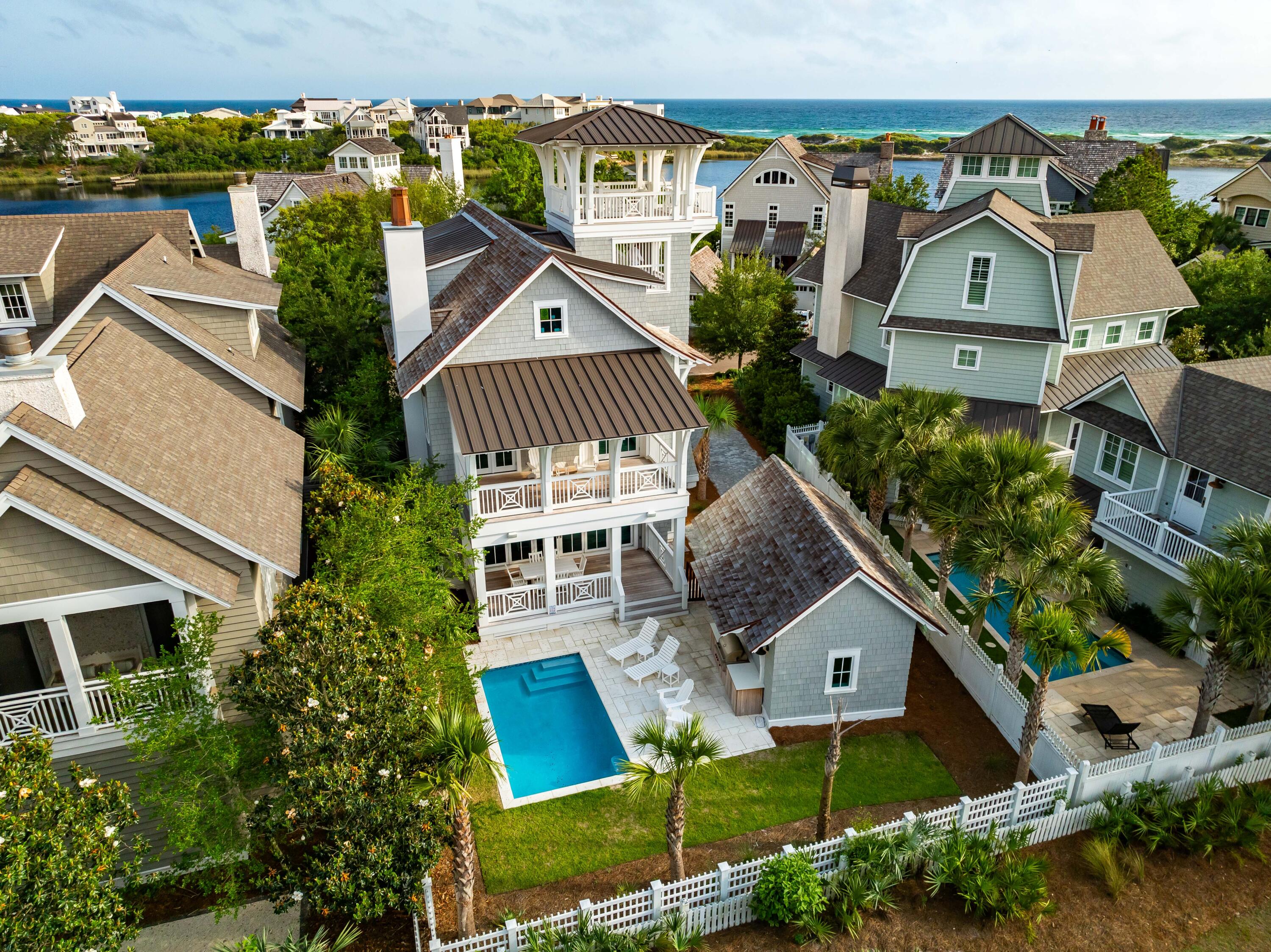 Revel in coastal sophistication at this exceptional 5BR/5.5BA residence encompassing nearly 3,300 square feet with a private pool, elevator, and detached one-car garage nestled in the prestigious Peninsula district of the gated WaterSound Beach community. This newly constructed masterpiece offers a rare blend of charm and functionality, boasting panoramic views of both the serene Camp Creek Lake and the shimmering waters of the Gulf of Mexico.
Crafted with meticulous attention to detail, this home is a testament to modern coastal architecture. Notice the seamless integration of elements from the geometric detailing on the balconies to the cedar shake siding and roof shingles to the over 1,800 Sq Ft of Ipe decking on all outdoor porches. From the moment you arrive, you'll be captivated the seamless integration of indoor and outdoor living spaces. Step onto one of several expansive porches, including wraparound porches on both the first and second levels and a remarkable 4th-floor observation tower where breathtaking sunsets become a nightly ritual. 
The interior of the home is no less stunning with multiple rooms wrapped in shiplap, beamed and vaulted ceilings, abundant windows bathing the home with natural light, and designer touches evident throughout in the lighting fixtures and high-end furnishings. The bright and airy great room is the heart of the home with a gas fireplace with marble surround, Cypress ceiling beams, and Nano doors that open to a welcoming dining porch overlooking the pool. The beautifully crafted kitchen is a culinary haven with commercial grade appliances, marble countertops, a Moroccan-style backsplash, floor-to-ceiling cabinetry, and Oyster shell chandeliers over the generously sized island. One guest suite is located on the first level with three more including the primary suite on the second level, and another on the third level. Each ensuite features artfully tiled walk-in showers and luxury detailing in both the fixtures and cabinetry. Both the second and third levels include a landing space perfect for a media room or office space.
Designed for both comfort and entertainment, the outdoor pool area beckons with its tranquil ambiance and borders a lovely community park, ensuring utmost privacy for your gatherings. This property is located moments from the community trail to Camp Creek Lake and bridge to private community beach access. The driveway can easily accommodate four cars along with additional parking available in the one-car garage. The thoughtful design of this property makes it well suited to a variety of uses from an investment property to a personal retreat.
The gated WaterSound Peninsula community is located south of Scenic Highway 30A offering homeowners a rare sense of seclusion yet with easy access to area activities. Amenities include swimming pools, a puttering park, community green spaces, a state-of-the-art fitness center, and private boardwalks along the rare coastal dune lakes and leading to the beach and to one of the most beautiful stretches of coastline in the country. Owners also have the opportunity to join the Watersound Club by The St. Joe Company featuring: private beach access, beach services, pools, restaurants, a bar with gulf views, two private golf courses (Camp Creek and Sharks Tooth) and the brand new Lifestyle Center at Camp Creek.