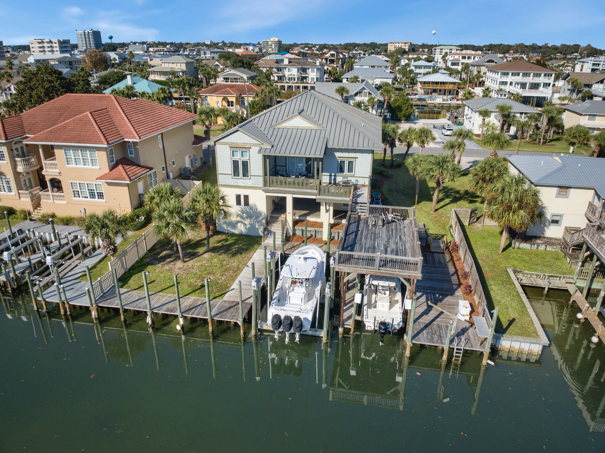 This home is located on Holiday Isle and offers the unique advantage of two private access points to the beach. Notably, Holiday Isle is one of only two areas in Destin that allow vacation rentals. 

Additionally, it's just minutes by boat to the Destin Pass, Choctaw Bay, Crab Island, and the Gulf of Mexico, making it an ideal location for those who enjoy coastal living and boating.

This home boasts bright and spacious living areas, along with outdoor decks that provide the perfect setting for casual living and entertaining. An expansive 4-bedroom, 5-bath canal-front coastal villa which features a spacious kitchen and living room on the main living level, adorned with granite countertops, stainless steel appliances, and beautifully sculpted ceilings. The rear porches and entertainment deck all have a southern exposure, providing an ideal setting for hosting gatherings and entertaining.

The ground level is equipped with a canal-front game room that includes a wet bar, as well as an independent studio apartment featuring a full bath, kitchenette, and a tackle room. The dock offers ample space to accommodate four vessels, including two upland slips and bulkhead docking for your water toys. One slip has a boat lift, partially covered by the second-level deck. 

Dockage is  capable of accommodating deep draft vessels. There is also a jet ski davit on the bulkhead dock, along with a convenient fish cleaning station.

The spacious open carport accommodates multiple vehicles and offers a refreshing breeze year-round. This property is undeniably an attractive choice for either a vacation retreat or a permanent residence. A truly a stunning home for a vacation retreat or permanent residence.