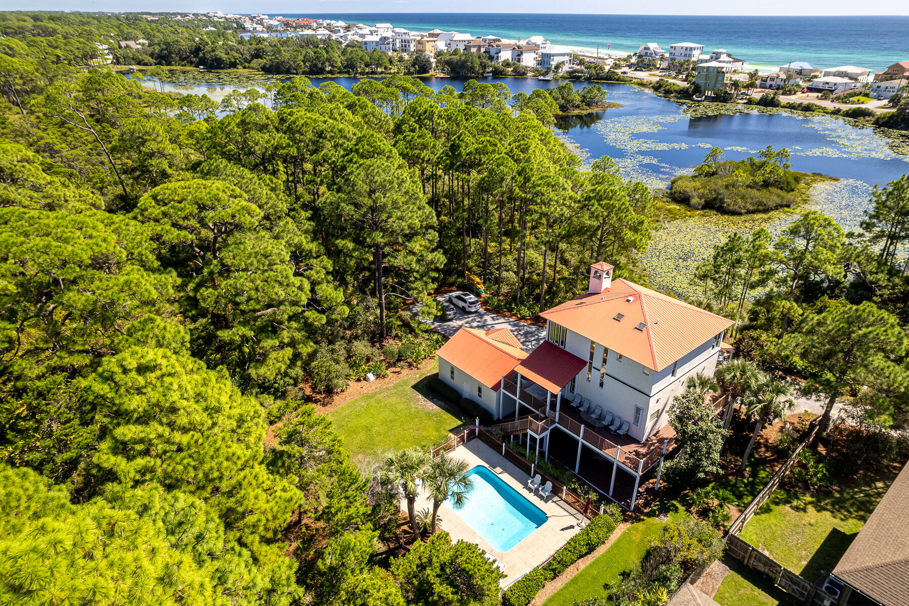 108 Woodward Drive offers an exceptional blend of three story construction and unspoiled vistas spanning Allen Lake and the Gulf of Mexico, making it a rare gem in today's real estate market. Despite its close proximity to the renowned white sand beaches of 30A, this residence boasts a serene and secluded ambiance that is truly second to none. This home features four bedrooms, four bathrooms, an inviting inground pool, a wrap-around porch, and a detached garage. A key aspect that makes this property stand out is its sprawling approximate 5.5-acre parcel of land. This sizeable lot presents a wealth of development opportunities, thanks to its zoning for neighborhood infill. With this zoning, you have the potential to create an additional vacant lot for investment or future expansion, making this property a great choice for those with an eye for investment possibilities. The main living quarters are housed on the second and third floors, providing commanding views and a sense of elevated luxury. The master suite is particularly impressive, featuring its own private living spaces complete with a cozy fireplace and a spacious study that can serve as a tranquil retreat or an inspiring workspace. The carefully crafted architectural elements, including arched accents, large windows that invite natural light, and built-in bookcases, give this home a character that is truly one-of-a-kind, blending the perfect balance of contemporary coastal design with timeless charm.
The bottom level of the house opens up exciting opportunities as it offers a separate living area, complete with its own kitchen and living spaces, as well as three additional bedrooms and two bathrooms. This space can be utilized for various purposes, whether it's accommodating guests, creating an in-law suite, or even converting it into a rental unit for potential additional income.
With its location just 600 feet from the public beach access, you'll have the white sandy beaches of 30A within easy reach, allowing you to relish in the coastal lifestyle to the fullest. A short stroll in the same direction brings you to the renowned Stinky's Fish Camp and a variety of other Dune Allen attractions and dining selections. The possibilities are endless, making this home not only a stunning residence but also a prime investment opportunity in one of the most coveted areas of the Florida Gulf Coast.