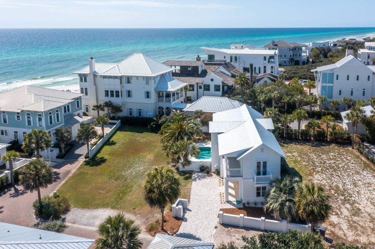 Privacy and luxury come together in this Melodia Lane retreat with peek-a-boo gulf views and thoughtful new updates throughout. Nestled in the small, gated community of Melodia south of Scenic Highway 30A in Seagrove Beach, this four-bed, three-and-a-half-bath home offers more than 2,700 square feet of living space over two floors. The first floor hosts multiple bedrooms including the owner's suite with pool views and porch access. There is a bunk room on this floor as well as private guest accommodations and ample closets for storage. On the second floor, the living room and kitchen flow seamlessly into one another. The living room offers a custom oak fireplace and balcony access, where you can take in peek-a-boo views of the Gulf of Mexico, and the kitchen has been meticulously outfitted with a full Viking appliance package, marble herringbone backsplash, large island with seating and brass cabinet pulls. This floor offers a formal dining room flanked by windows, laundry room and powder room. Notable updates touch every part of the home including a new roof, new flooring, new exterior pavers, a new privacy fence, WIFI switches, Nest and Ring. Heated pool complete the exterior space. Enjoy private beach access just steps away and close proximity to shopping, dining and recreation in WaterColor, Seaside and on 30A and beyond.