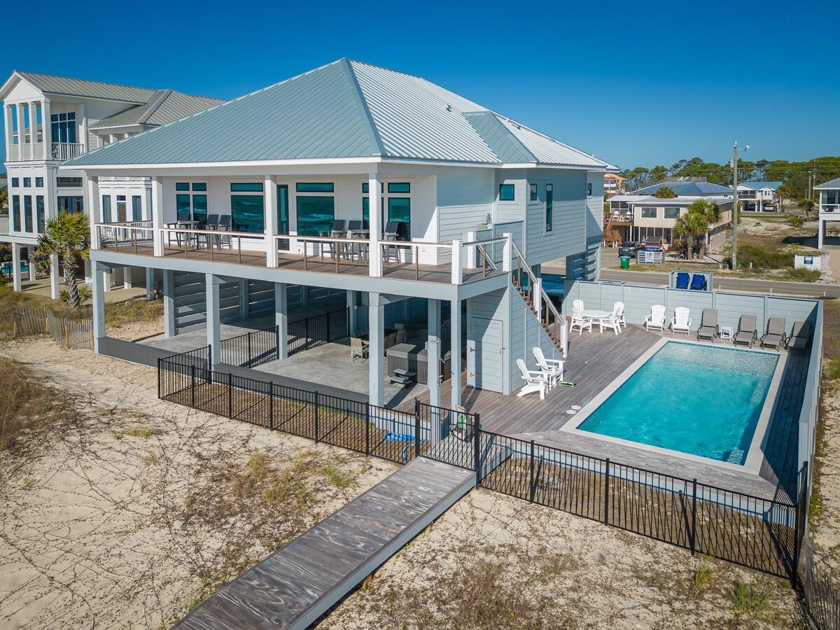 New construction luxury Gulf front single level home custom built for large families and short-term rental income. The gross rental income for One More Night in 2023 (its first full year of rentals) was over $321,000 which included two owner week stays in peak season. This 6 bedroom, 6 and ½ bathroom home, with 100 feet of Gulf frontage, features thoughtful details to be enjoyed by owners and renters alike. Beginning on the main living level, everything comes in sets of two to accommodate large group stays without feeling crowed: two Gulf front master suites with king beds, walk-in closets, and large master bathrooms featuring double vanities and enclosed water closets; two junior suites with king beds and bathrooms; two bunk rooms (one with queen and twin size bunks and one with full and twin size bunks) with bathrooms; two separate living areas (one Gulf front and one between bunk rooms with snack bar) so adults and kids can have their own space; two French door refrigerators; two dishwashers; two dryers; and a double oven! The décor is clean and durable with quartz countertops, luxury vinyl tile flooring, beautifully tiled showers, natural wood shiplap walls, and tongue and groove ceilings. Natural light and Gulf views are abundant from windows throughout the house with tall ceilings and 8' solid core doors. This house comfortably sleeps and accommodates 18+ people with room for everyone to spread out - inside and outside. The kitchen is oversized with cabinets floor to ceiling and the house has indoor dining seating for all 18 (10 seat dining table and 8 seats at the kitchen bar). Unlike many beach houses, this house has more than enough storage closets and cabinets. While the inside is amazing, the outside of the home may be even better. The 55'x10' deck, overlooking the beach named 2023's best beach in America by Dr. Beach, is breathtaking with expansive views to the east and west as far as the eye can see. The beach level pool deck and living area provide a whole other place to spread out and enjoy the out of doors. One half features a very large (35'x12.5') elevated heated pool with tanning shelf, privacy fence, and decking to soak up the sun. The other half is covered, offering a respite from the sun's rays when needed, and features a spa, entertainment area, outdoor seating, dining table, TV, and cooking area. Both overlook the Gulf with direct access to the beach via a private boardwalk. An enclosed ½ bathroom with hot and cold shower make staying downstairs all day a breeze. Boaters, fisherman, and RVers were not forgotten. There is ample parking for boats (including boats with towers) and RVs (with a 50amp power supply). A large storge room exists for storage of beach toys and bicycles. Finished in the summer of 2022, the exterior of the home is built with materials designed to last. All decks are constructed with Cumaru (aka Brazilian Teak) which is known to have a 50+ year useful life. All siding and privacy fencing is constructed with Hardie cement board and the roof is standing seam metal. The house was designed to include a passenger elevator which can easily be added later. The elevator room is currently being used as a large owner's closet. The house is sold fully furnished and ready to occupy or rent. It is under rental management with Cape & Coast Premier Properties. It is a must see!