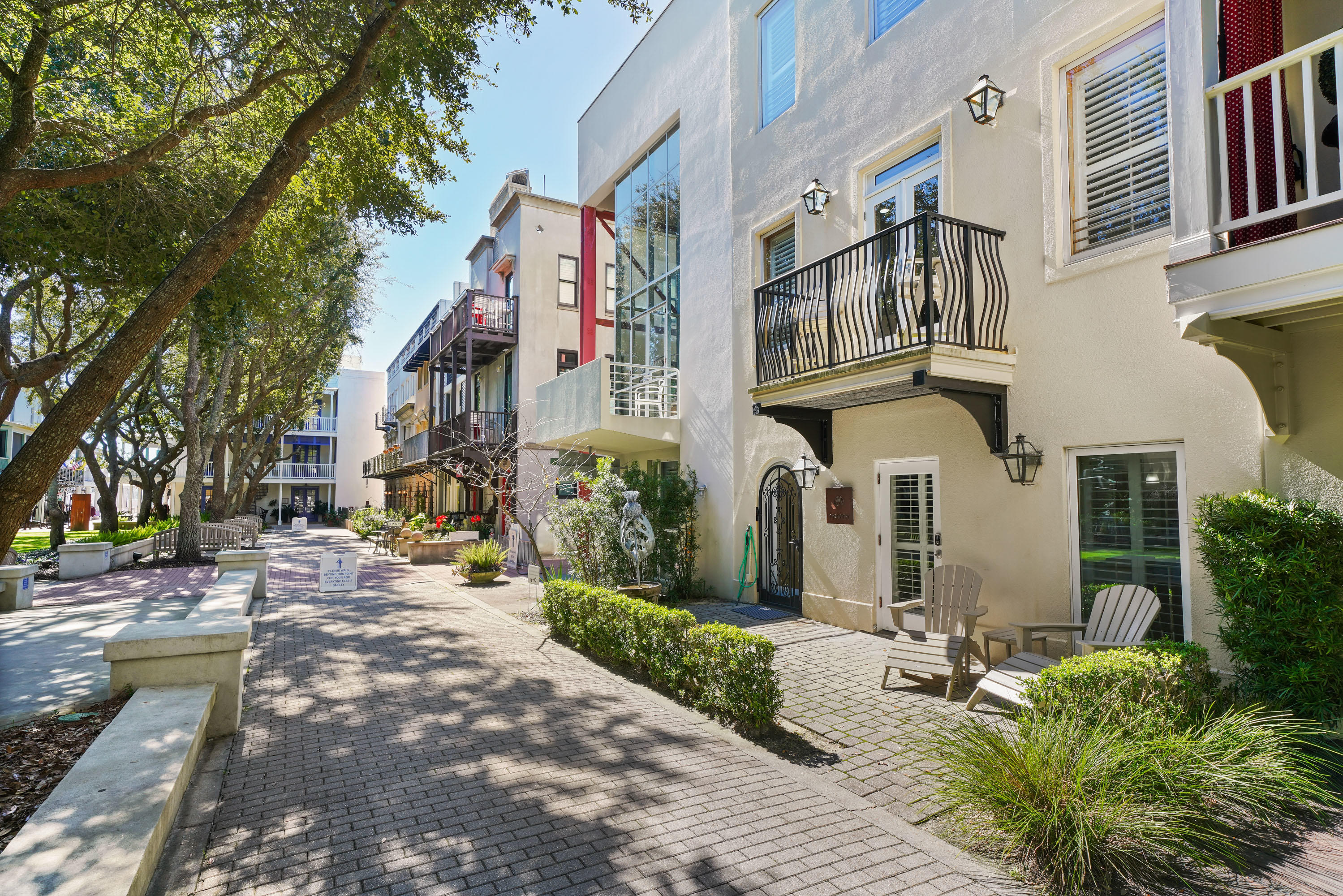 BOTHY- Located in Ruskin Place, Seaside's prized Artist's Colony, is this exceptional townhome! Reminiscent of Jackson Square in New Orleans, these townhomes surround a beautiful landscaped park lined with bench seating shaded under mature oak trees. Bothy's three levels offer a ground floor comprised of a self-contained apartment with living room, full kitchen, master bedroom, bunks and two baths. Lock off from the upper floors and rent separately or combine with the upper levels. A private entrance takes you to the second level great room. Abundant light streams throughout the open floor plan. The inviting & spacious living area with its high ceiling & wet bar is decorated to reflect the casual and comfortable beach lifestyle. Off the living area is a 21' x 10' terrace equipped with  outdoor dining and a gas grill for dining alfresco. The kitchen is equipped with a Viking gas stove, Northland refrigerator and separate Northland freezer, tile backsplash and quartz counters for a timeless look. French doors in the dining room open onto the front balcony overlooking the peaceful tree lined park. A clever sideboard houses a murphy bed for extra guests. The 3rd floor reveals a spacious master suite along with a luxurious bath fitted with Kohler rain shower system, freestanding Tyrrell & Laing soaking tub for two and custom vanity with double vessel sinks. From the master suite, French doors open onto a private terrace. The second master suite has a vintage style ensuite bath. A spiral staircase over a glass floor leads to a roof top terrace to enjoy the ultimate sunset views over the gulf.  Lastly, the covered carport houses two ample storage areas for beach toys and bikes. Rent the main floor separate or combined for a three-bedroom vacation rental sleeping 12 comfortably. Bothy is convenient to the lively town center shops, restaurants and beach.