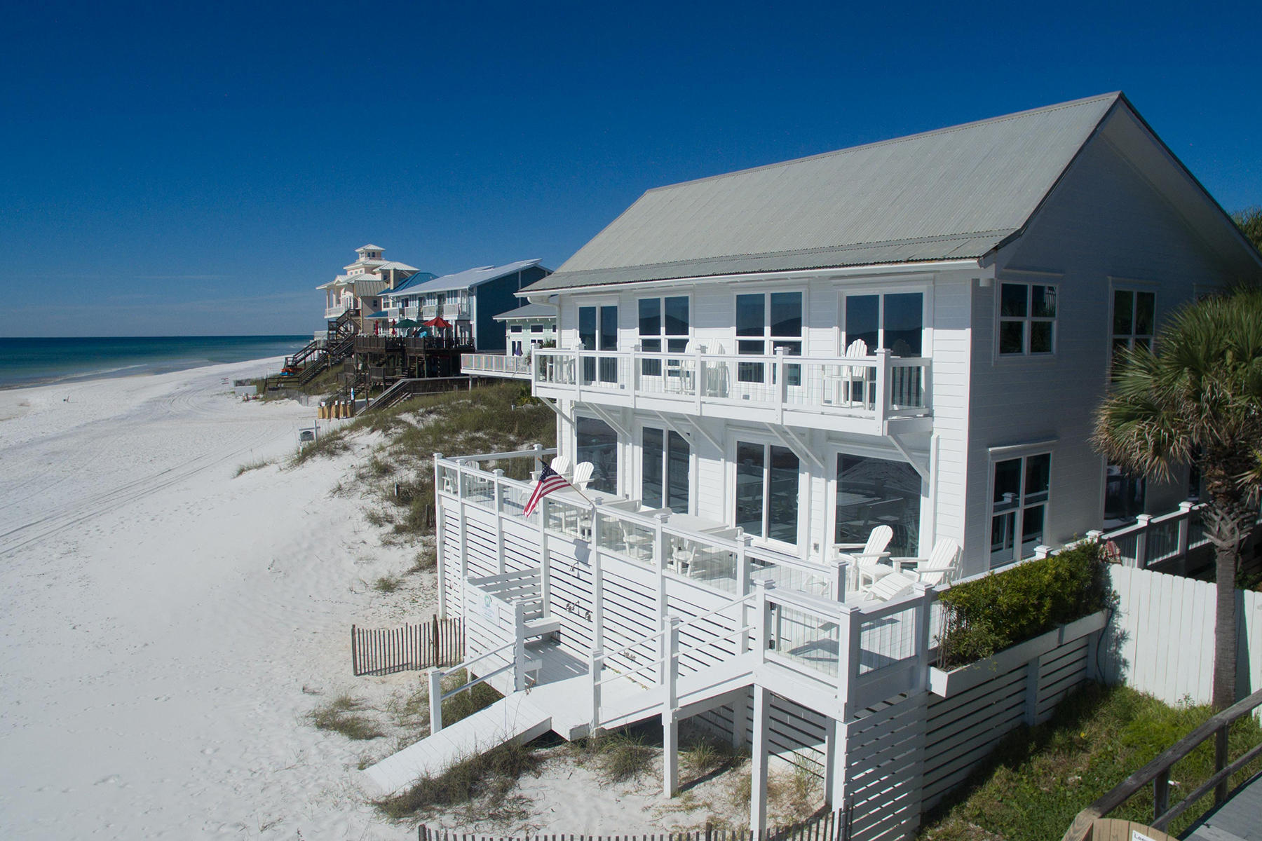 Set in a prime gulf front location, this traditional beach house encapsulates waterfront living with incredible gulf views from almost every room. Presiding on 71 feet of pristine beach frontage from its elevated position, this desirable vacation home offers a beach lifestyle that everyone can enjoy. Ideal as a second home or vacation rental, this well-appointed beach cottage has impact doors and windows, hardwood flooring and a wrap-around deck on the entire first floor. The first floor living and dining area share breathtaking gulf views with picture windows. Custom Kraftmaid cabinets, stainless steel appliances, and quartz countertops complete the gourmet kitchen. Additional wet bar conveniently provides ice and refrigerated drinks for toasting each sunset. The second floor has four bedrooms; two with Gulf views and access to the private balcony for enjoying the gentle sound of waves on the sandy beach below. Tasteful decor and ample storage complete the appeal of this stunning beach house.