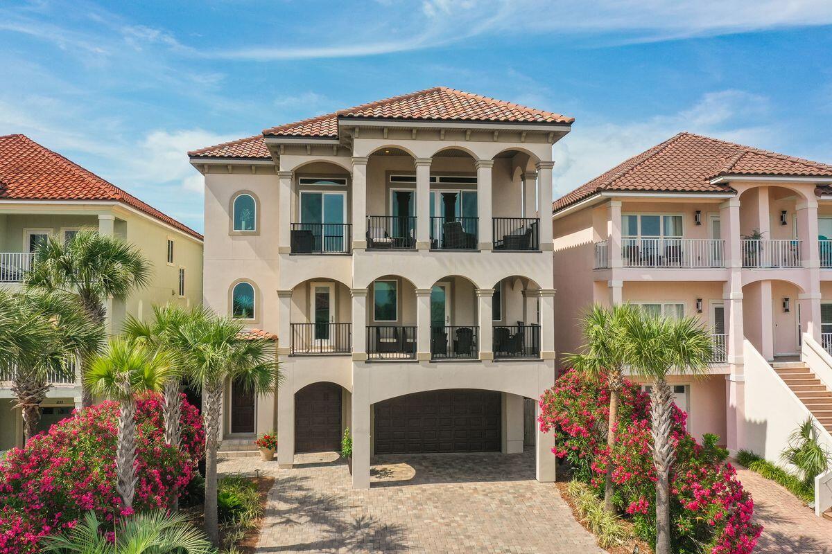 Built in 2017, this immaculate home enjoys gated security, deeded beach access and all the benefits of living in the community of La Valencia Beach Resort. The reverse floor plan takes full advantage of the stunning gulf views with three floors of living space and an elevator to get you there. Lime oak flooring on the upper floors, 10-ft. or 12-ft. ceilings, extensive built-in storage, impact-resistant windows and under/over cabinet lighting provide added benefits. Relax and entertain in the third-floor great room around the feature gas fireplace or step out onto the covered lounge deck and show off those breathtaking views. It's the perfect spot for sunset cocktails before moving into the formal dining area for a social feast. The gourmet kitchen with a 6 burner gas range, double ovens and stunning quartz & granite countertops is a well-planned space for home chefs to create memorable cuisine. Sharing the same rooftop views, the master suite includes a sumptuous ensuite bath with dual vanities and walk-in closet. Down one level, there's versatile recreation space in a family room that includes a beverage nook, seating area, kitchen and drinks cooler. Three beautifully proportioned bedrooms include a second master suite. The first floor has a family room with a sleeper sofa for guests that could easily become an extra bedroom. A studio kitchen with refrigerator is well-located for delivering chilled drinks straight to backyard lounge chairs and the outdoor kitchen. There's bunk room potential in the private office space and a three-car garage plus separate golf cart garage. This coveted beach community is a golf cart ride from shops and restaurants on the west end of Panama City Beach. Rosemary Beach and 30A entertainment and lifestyle are two miles away. Whether it's a full-time residence, second home or vacation property, owners have the privilege of enjoying an owners only pool. Owners and guest a like always enjoy tennis courts and a beautiful gulf-front pool and deeded beach. La Valencia Beach Resort is truly a hidden gem.