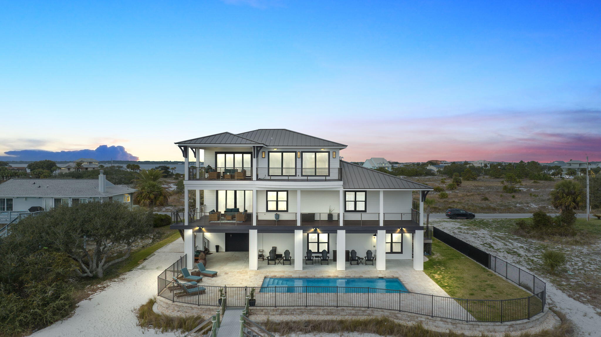 Welcome to the luxurious Little Sabine waterfront retreat, nestled on beautiful Pensacola Beach. This exquisite property offers an unparalleled coastal living experience, with breathtaking views of the bay, sound, and the Gulf of Mexico.

For water enthusiasts, the private boat dock and boat lift are exceptional amenities. The boat lift can support up to 20,000 pounds and a 40 ft boat, providing easy access to explore the bay or venture out to the Gulf of Mexico. Additionally, there are docks and shore power available for a 55 ft yacht, as well as two jet ski lifts. Whether you're an avid boater or simply enjoy being on the water, this retreat caters to your desires.

The outdoor living spaces have been thoughtfully designed to maximize your enjoyment of this magnificent location. You can lounge by the sparkling pool on hot summer days or relax in the shade of the covered patios located on each level of the home. Omni pool controller with gas heater allows you to enjoy the pool all year round These outdoor spaces allow you to immerse yourself in the serene waterfront ambiance and create lasting memories with family and friends.

As you step inside, you'll be captivated by the meticulously designed interior, where no expense has been spared to create a blend of elegance and comfort. The spacious open floor plan seamlessly connects the living, dining, and kitchen areas, providing an ideal setting for relaxation and entertaining. Gain access to all levels easily with your home elevator.

The gourmet kitchen is a chef's dream, featuring top-of-the-line Gaggenau appliances, custom cabinetry, and a center island with ample seating. Whether you're preparing a casual meal or hosting a grand gathering, this kitchen provides the perfect space to showcase your culinary skills. Adjacent to the kitchen, the dining area boasts panoramic windows that invite abundant natural light and offer breathtaking views of the water, enhancing your dining experience.

Completely remodeled in the last two years from top to bottom and exterior has been repainted within the last 6 months. Lutron remote electric shades on all doors and windows bringing ultimate comfort. Multi zone surround sound and theater throughout home & mesh WI-FI installed on interior, exterior and dock. Home features 2 geothermal HVAC systems and 2 instant hot water heaters. 

The master suite is a true sanctuary within this retreat offering luxury and tranquility. With its panoramic views, spacious walk-in closet, and a spa-like ensuite bathroom complete with double vanities and a walk-in shower, the master suite provides a perfect retreat at the end of each day. Three additional spacious bedrooms, each with their own ensuite bathrooms, ensure comfort and privacy for both family and guests.

Located in the highly sought-after Pensacola Beach area, this bayfront oasis provides the perfect combination of seclusion and convenience. You'll have access to pristine white sandy beaches, vibrant local restaurants, and a myriad of recreational activities. Whether you prefer relaxing by the shore, exploring the local cuisine, or engaging in outdoor adventures, this location caters to all your desires.

In summary, the Little Sabine waterfront retreat on Pensacola Beach offers a luxurious and unparalleled coastal living experience. From the stunning views of the bay, sound, and the Gulf of Mexico to the meticulously designed interior and thoughtful outdoor living spaces, this retreat embodies the epitome of elegance, comfort, and serenity.