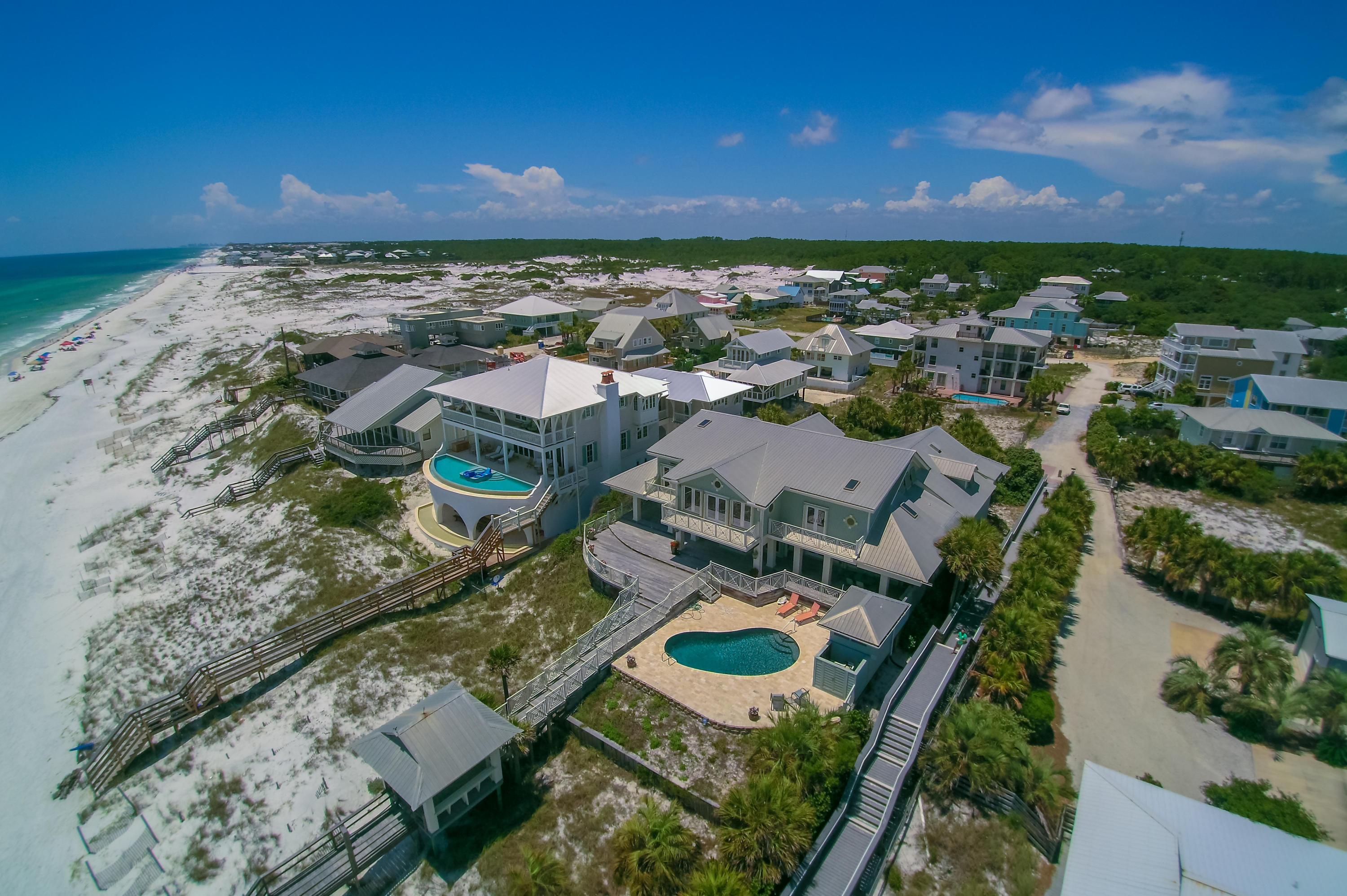 Exceptional value, PRICED TO SELL! Newlyremodeled with luxurious new interiors and finishes, 59 Auburn Drive is now priced to sell! This expansive Gulf-front Grayton Beach residence is a rare and notable property. Spanning an impressive 100 feet on the Gulf and over 425 feet in lot depth, this home is projected to generate +$300,000 annual rental revenue, with established 2017 bookings +$278,000. Fully renovated in 2016, the large residence offers a desirable large and open plan, adjacent to a fully appointed carriage house above of most spacious garage. A carefully curated selection of designer furnishings, white pecky cypress paneling, and marble top counters and vanities throughout, present a style of opulent coastal elegance. Two master bedrooms found in the main house, one on each level, extend the gorgeous views of the Gulf. The lovely master suite on the main level leads to an adjoining private office. The stunning spacious master bath features a huge closet, dressing area and a steam shower. The second level of this home also features an impressive guest suite, bunk room and two additional bedrooms. The extremely spacious living room, open to the dining area and breakfast alcove, feature soaring ceilings  & a 2-story cut limestone vent-less fireplace.  A combination of windows and doors open up the entire southern wall, providing endless views of the Gulf. Wood flooring is throughout. The high-end gourmet kitchen is complete stainless steel KitchenAid appliances, including double  refrigerators, warming drawer, trash compactor, and microwave.  Found under an expansive butcher block island is a Bosch dishwasher, along with a Whirlpool dishwasher. This kitchen fulfills a chef's dream with a commercial FiveStar gas range and dual ovens, as well as a wet bar and wine refrigerator.  The outdoor living is quite exceptional, the pool overlooking the gulf on a spectacular deck of coral stone and ipe, with cabana & grill area. The carriage house offers a quiet get-away, with open bedroom/living and a fully equipped kitchen.