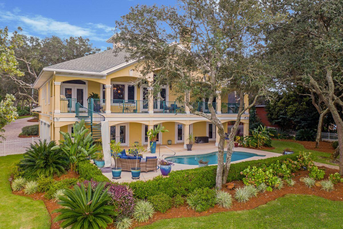 Outside of the bustle of beach activity but only 20 minutes from putting your toes in the sand is this 4,072-sq.-ft. home situated on a .65-acre lot directly on Lake Lorraine in Shalimar. This three-bedroom home in Lake Lorraine Gardens offers 180-plus feet of water frontage and direct bay access with its own private dock boasting boat and jet ski lifts. Privacy abounds from this Old Florida-style home, which has been meticulously maintained and features a private heated pool and brick paver patio area with a fire pit overlooking the water. The elevated entrance of the home showcases a grand foyer entrance that opens up to the living, kitchen and dining spaces which provide beautiful water views and an abundance of natural light, beautiful crown molding, natural gas fireplace and built-in shelving. The kitchen is generously sized with granite countertops and ample storage. The owner's suite on the second floor also offers water views and a balcony as well as a spacious en suite with dual vanities, a bathtub and a separate shower. On the first floor, there's a spacious game room with lounge space, bar and dining area that opens up to the backyard oasis. Two additional bedrooms plus flex space provide ample accommodation and space that could be used as an office or gym. Additional features of the home include a mix of tile and oak flooring throughout the upstairs and bamboo downstairs, a Control4 system, bar with 200+ bottle wine cooler, closets by California Closets, low voltage lighting front and backyard, ample privacy and Lutron automatic window shades. A few notable updates have been done as well, including new roof in 2018, new HVAC in 2017, and just this year there's been a new water heater, driveway pavers, lift station pump, seawall, fence and new sod and irrigation. Lush landscaping surrounds the home, which includes a two-and-a-half space garage and extended semi-circle driveway. Enjoy serenity with no HOA dues in your own expansive paradise.