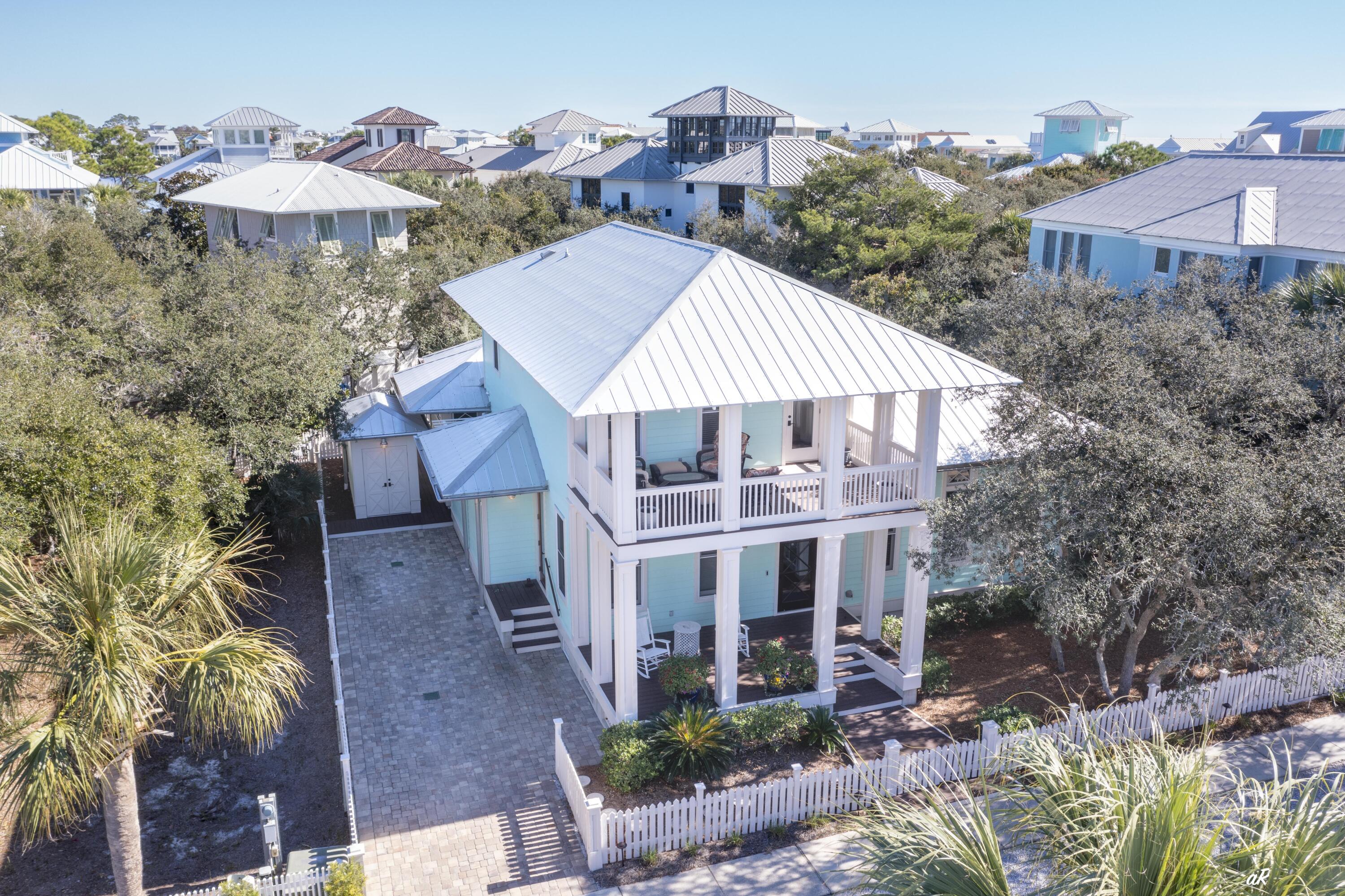 This southern cottage-style beach house, masterfully designed by renowned AIA architect Gary Justiss, is nestled in the serene, private gated community of Carillon Beach. Offering a blend of exclusive privacy and contemporary elegance, this home offers an unmatched living experience near the sea.

The house boasts three nicely appointed bedrooms and four baths, providing ample space for family and guests alike. The master suite, conveniently located on the first floor, features elegant design and comfort, making it a perfect retreat after a day spent by the ocean. The living spaces are graced with tall ceilings that enhance the airy and open feel.

Living spaces extend seamlessly outdoors to the spacious porches, offering a view of the surrounding landscapes and the perfect setting for relaxation or entertaining. The outdoor area further enhances the leisurely beach lifestyle with a convenient outdoor shower, ideal for rinsing off after a beach day, and a bike shed to store beach gear.

Adding to the function and charm of the property, an outbuilding is currently utilized as a combination mancave and greenhouse. This additional structure offers potential for various uses, adapting to the homeowner's lifestyle needs.

The ample backyard, set against a backdrop of lush greenery and coastal breezes, features raised bed planters for gardening enthusiasts. This space is also suitable for accommodating a pool, offering potential for an idyllic outdoor oasis tailored to leisure and entertainment.

Each detail in this home speaks of thoughtful design and high-quality craftsmanship. This beach house embodies a lifestyle perfect for those seeking a permanent residence, a holiday home by the sea, or an investment property.