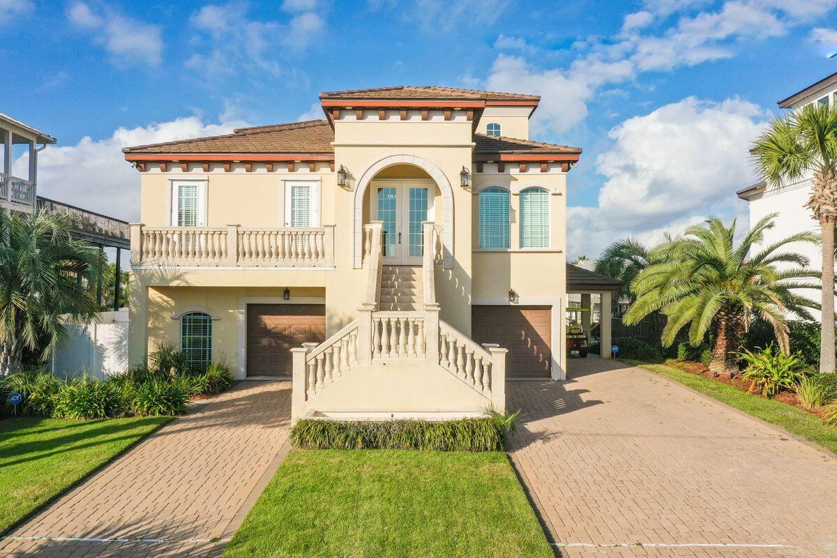 Remarkable outdoor spaces across four levels characterize this Holiday Isle home that features stunning views of the Gulf of Mexico and Destin Harbor. A four-bed, five-and-a-half-bath home with more than 4,900 square feet of living space, this coastal retreat is built for a water enthusiast's lifestyle with an 80-ft. deepwater boat dock and lift. Built in 2006 and never placed on a rental program, this home has a recently-added lap pool with spa and is only a short walk to beach access. Concrete block construction with a concrete tile roof, three levels of this smart home-enabled property are accessible via private elevator. The open kitchen and owner's suite reside on the main level of the home, which features 25-ft. ceilings, along with formal living and dining areas, an informal living room with a double-sided fireplace and wet bar, and an office. The next level features a game room, home theater, wet bar, pool bath and bedroom with en suite bath and access to pool and deck area. The third floor includes a den, library shelving and two bedrooms with en suite baths. Four levels of outdoor decking provide the perfect location for viewing fireworks, watching the sunset or simply unwinding with water views at the end of the day. Enjoy a vacation lifestyle every day with unparalleled outdoor living that includes the heated lap pool with spa, extensive decking, outdoor kitchen, fishing station with cleaning area, tackle room, outdoor shower, golf cart storage (golf cart negotiable) and a two-car garage. A neighborhood water taxi will chauffeur you to your favorite restaurant or club on the harbor, making this a truly all-inclusive spot to call home.