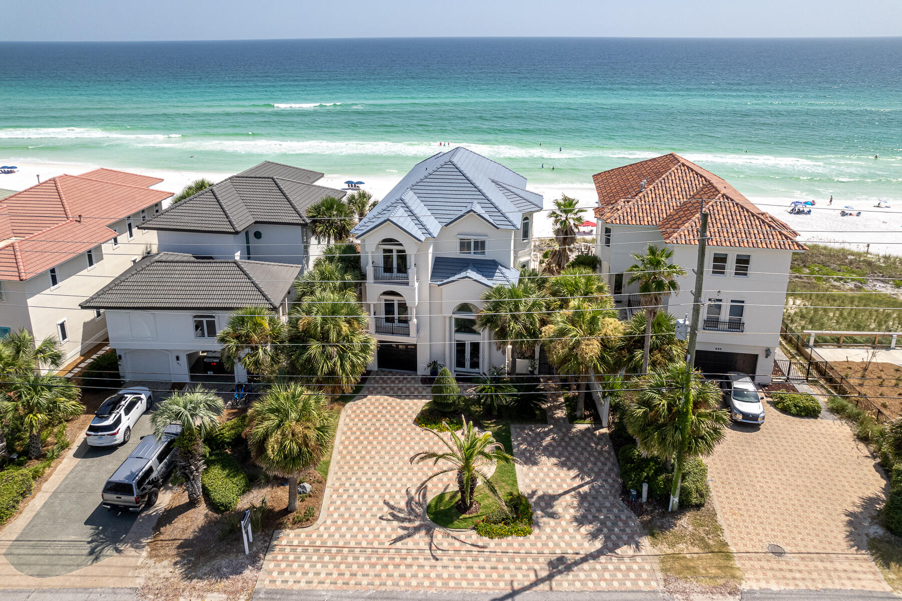 Perfectly crafted renovation on the gulf is ready for your unforgettable family retreat or lucrative short-term rental. Never rented under the current or previous owner, and renovated in 2023, this meticulously maintained beach front home is sold fully and professionally furnished and is located outside an HOA! Coastal comfort meets classic elegance with a touch of glam, inside and out, all set overlooking your private beach, perched on one of Destin's highest elevations. Drive in on whimsical pavers to your freshly painted façade and two car garage. Meander through lush landscaping and to the gated side courtyard for this visit's first glimpse of turquoise waters and snow-white sandy beaches. Breathe in warm salt air, no crowds in sight. Just behind you, three levels of deep gulf front balconies capture your full attention. Electronic full-house hurricane shutters are raised for your arrival, giving you a peak of inviting interiors. You can't wait to enjoy a soak in the recently installed hot tub, but the home's interiors are calling. Enter the front door through striking glass doors to a 24' entry and cobalt blue Artscape, illuminated by a cascading beaded-glass chandelier. Pause and smile for a moment but don't miss the first-floor private lockout. With its own fully equipped kitchen plus living and dining, the separate quarters can be rented or enjoyed separately. An alluring black marble staircase calls to the main floor but take the full house elevator if you like. Main floor kitchen/dining/gathering takes family center-stage. The kitchen invites a crowd to gather at the dining bar or at the contrasting natural wood island. You crank up some Tom Petty on the Sonos sound system. Custom white cabinetry stretches to high ceilings and highlights designer Thermador appliances including a glass cook top, warming drawer and paneled refrigerator. Stylish dark granite countertops beg for wine tasting and will forgive a spill or two. The crowd expands to the open concept living/dining but can't-stay-away-from gulf waters so some retreat to the balcony for sunset. At days end, guests retire to one of four additional guest suites or to the downstairs lock-out, all served by private sophisticated sparkling-white tiled baths. The hosts rise to the third floor main ensuite which sits high over the gulf, claiming privacy and expansive gulf views, plus its own sitting room. The main bedroom master bath embraces a touch of Hollywood glam and invites a candle-lit soak for two. If you are looking for a didn't miss a thing, checks all boxes, dream retreat, you've found your way home. Call for a private showing.