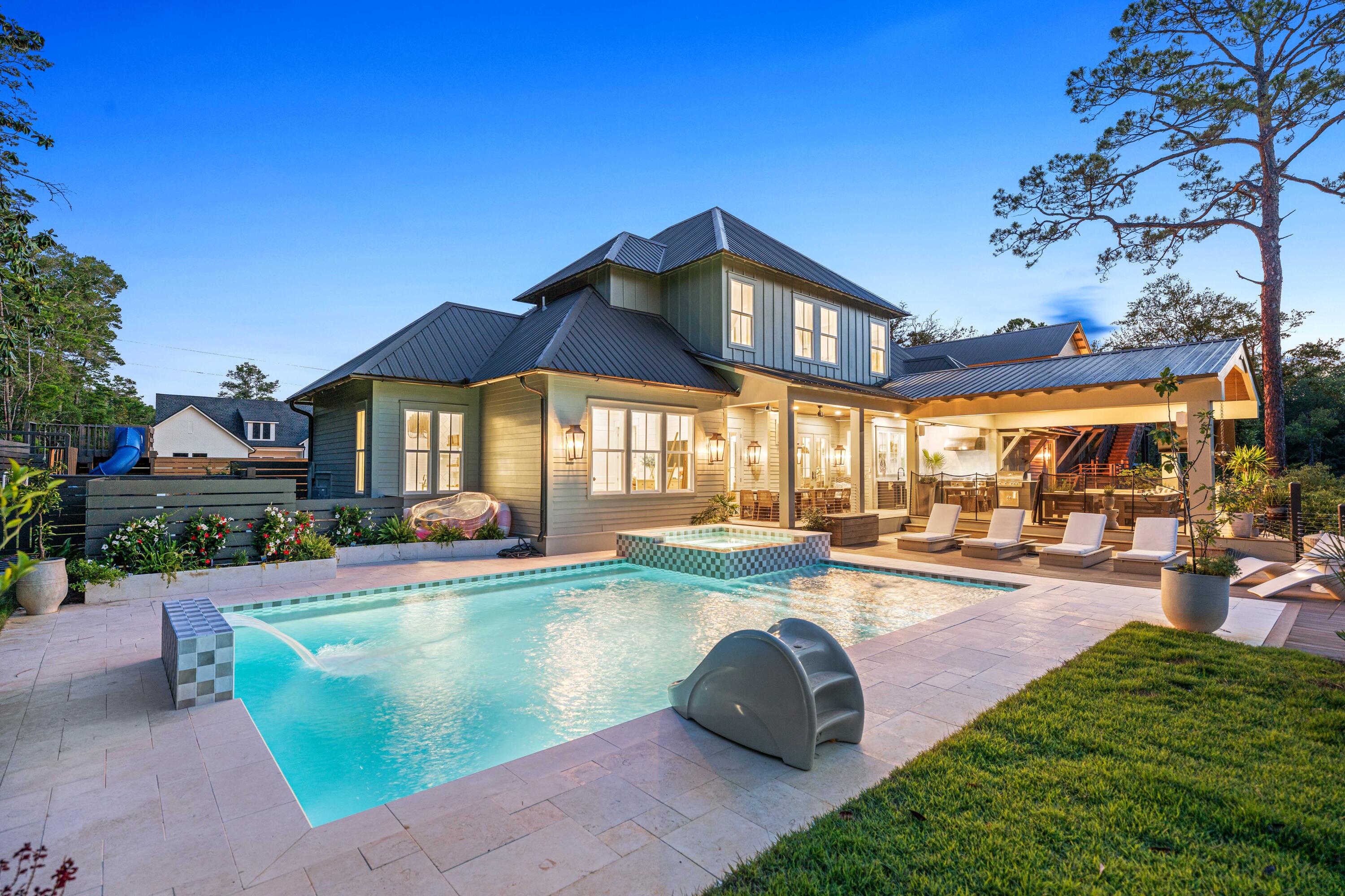 **GORGEOUS CUSTOM WATERFRONT HOME WITH ADJACENT VACANT LOT INCLUDED TOTALING MORE THAN AN ACRE** Tucked away in a lush, secluded setting, this one-of-a-kind estate features a backyard oasis with a designer-tiled pool equipped with both a heater and a chiller, ideal for year-round enjoyment. Surrounded by mature landscaping, this outdoor space offers tranquility and beauty, perfect for entertaining or unwinding in total seclusion. Step outside to more than 1,200 square feet of TimberTech decking that connects indoor and outdoor living spaces. A private dock with boat lift, currently holding a 28-foot vessel with motor down, provides direct Bay access for boating, fishing, or paddleboarding. The water depth measured 50'' in June 2025.