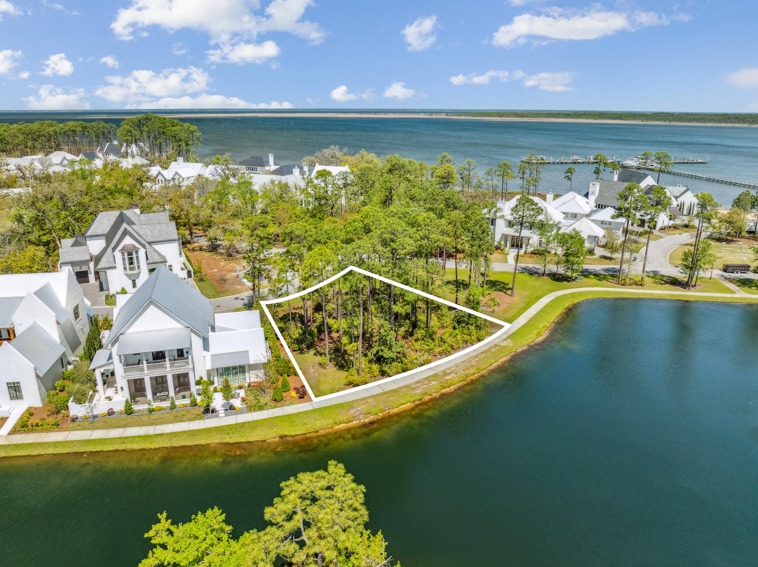 Rare opportunity to acquire a prime vacant homesite in the coveted waterfront community of Churchill Oaks! Located on a desirable corner lot, this expansive lakefront property offers breathtaking views in every direction—including a glimpse of the bay through the surrounding nature preserve—and comes with the option to purchase a 50-foot private boat slip in the community's deep-water marina. Notably, there is no lot to the north, providing enhanced privacy and a clear, unobstructed landscape. Design and build your custom dream home in one of South Walton's most sought-after bayfront communities. A preliminary design study by Matt Savoie is included with the property. Renderings can be found under the Documents tab. Nestled amidst native vegetation and the serene waters of Hogtown Bayou, Churchill Oaks embodies a lifestyle of luxury and natural beauty. Once you pass through the stately gated entrance, you'll be greeted by magnificent coastal homes that highlight southern architecture, all shaded beneath majestic oak trees. This 40-acre community features 87 homesites and some of the finest amenities in South Walton. The latest addition to the community is a deep-water private marina, which includes 36 private boat slips (available for purchase separately), paddleboard storage decks, a fish cleaning station, shoreline stabilization, and more. The Churchill Oaks Clubhouse is an exceptional 8,000-square-foot amenity perched on a point overlooking the bay, offering stunning views. The clubhouse features three pools, an exercise room, outdoor bar, fully equipped media room, commercial-grade kitchen, bath and locker rooms, and ample gathering spaces for residents and their guests to enjoy.