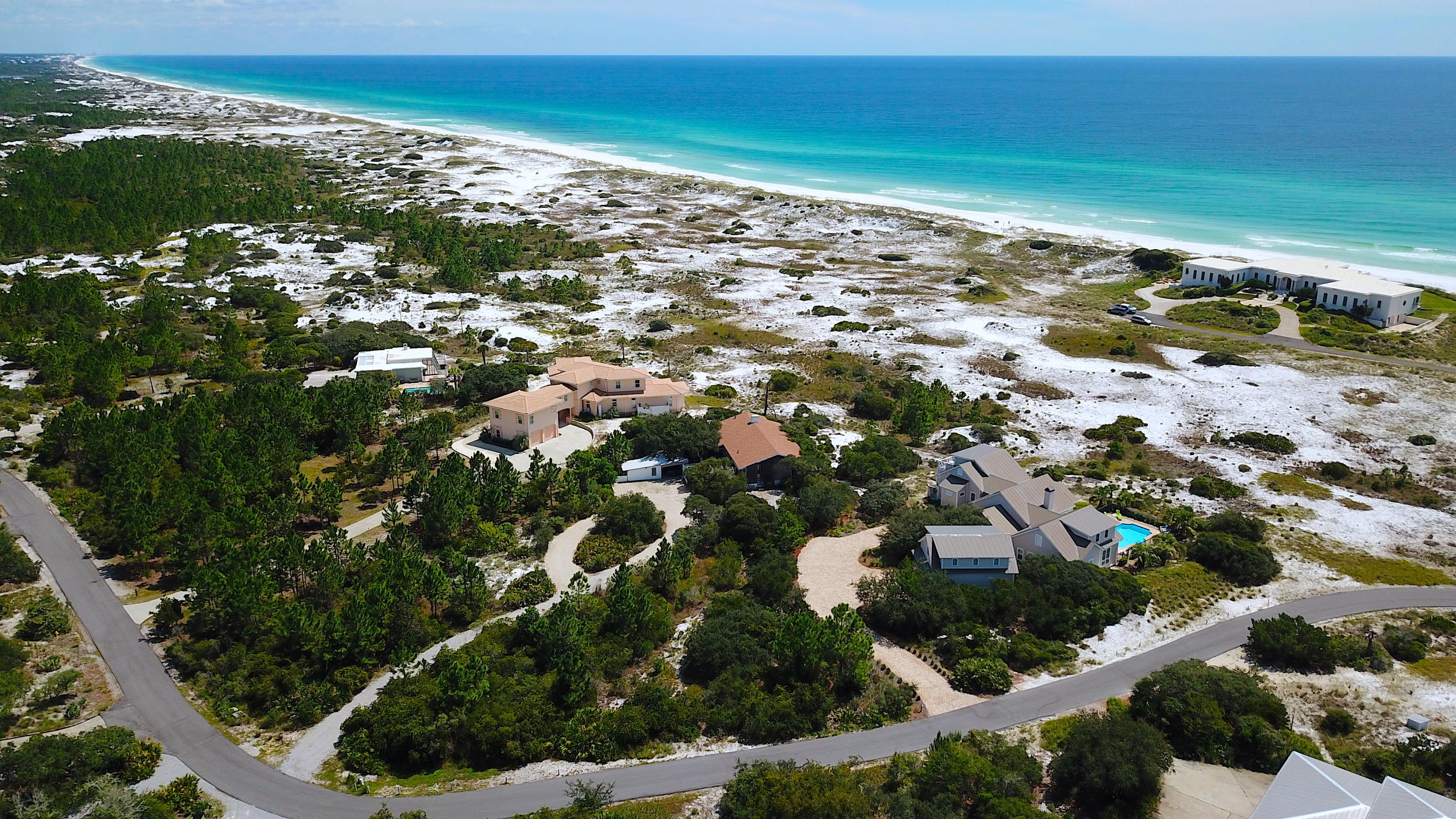 Four Mile Village is a place where nature can take precedence over the superficial and where those who appreciate nature in all her various moods and forms can find a haven. This private gated community expands across 300 acres of coastal paradise offering hiking trails, historical landmarks, a private coastal dune lake, and 2,200 feet of pristine white sand beach along the Gulf of Mexico. This approximately 1-acre lot is well-positioned to capture southern views and breezes from the Gulf, while enjoying the privacy and serenity of this low-density community. This mid-century home displays character throughout with a simplistic layout and design that remains timeless. There is ample room to expand the footprint of the existing structure or enjoy the property while you design a future homestead. Come be part of a special neighborhood that continues to cement itself as a hidden haven along our beautiful Florida coastline.
