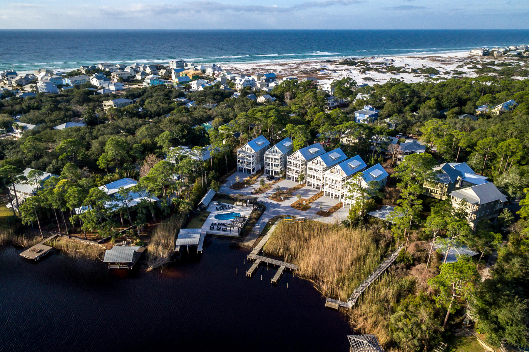 This beautiful 5 bedroom, 5-1/2 bath custom built home with a private boat slip is complete and a family or investors dream. Design by architect Geoff Chick and built by local builder Luke & Blue boasts 3658 SqFt of living space and spectacular views of one of the most beautiful coastal dune lakes. Each floor of this home provides impressive views of Western Lake all while overlooking the community swimming pool area. Come visit our MODEL HOME open daily and tour this exquisite home! Open concept living is truly represented in this home. Behold the lake views as you enter the 2nd floor into the inviting custom built kitchen. The solid wood cabinetry with dovetail joinery and cushioned close hardware, marble counter top, Wolf 36'' 6 burner all gas range and Sub-Zero 36'' built-in refrigerator are some of the features of the kitchen. The hospitable open living allows for dining and entertaining indoors and al fresco on one of the two covered porches. The master suite completes the 2nd floor living area with a custom built walk-in closet. The en suite bath showcases multiple shower heads, dual vanity sinks with quartz counter tops and a freestanding bathtub. Take the stairs or better yet, ride the elevator to the 3rd floor! This floor has an additional three bedrooms and laundry. The two western facing bedrooms also have en suite baths with custom cabinetry and quartz counter top. One of the bedrooms has a walk-in closet while the other has 2 separate closets allowing for additional storage space. Facing the waters of Western Lake is the 2nd master bedroom. Instant relaxation is the feel of this master bedroom. Views of the lake can be enjoyed while relaxing in your chamber or step outside onto the covered porch enjoying a glass of wine to end the day. The en suite bath is not to be missed in this gorgeous master suite. Custom cabinetry, multiple shower heads, double vanity sinks and more details that highlight luxury. The 4th floor is an absolute treat to those who enjoy natural light. This final level has a custom built bunk room with FOUR closets and a balcony allowing for natural light to encompass the room. Grab a cold drink at the wet bar on the way to relax in either the loft area or the open porch (finished with high level resistance Trex decking) to enjoy the beauty of coastal Florida living. 

This property is large enough to accommodate a private pool and/or an outdoor fire pit at the election of the buyer. However, addition of any private amenity will be priced separately from the list price of the property. 

Community features include: private gated community with 6 exclusive residences situated on 1.5 acres on Western Lake, community swimming pool fronting Western Lake with sundeck, outdoor kitchen, grill & bathrooms, private access to Western Lake including; boat dock with 6 slips (each owner has an assigned slip) & boat ramp, approximately 175 linear feet of frontage on Western Lake & a 5-minute walk to the white sand beaches of the Gulf of Mexico.