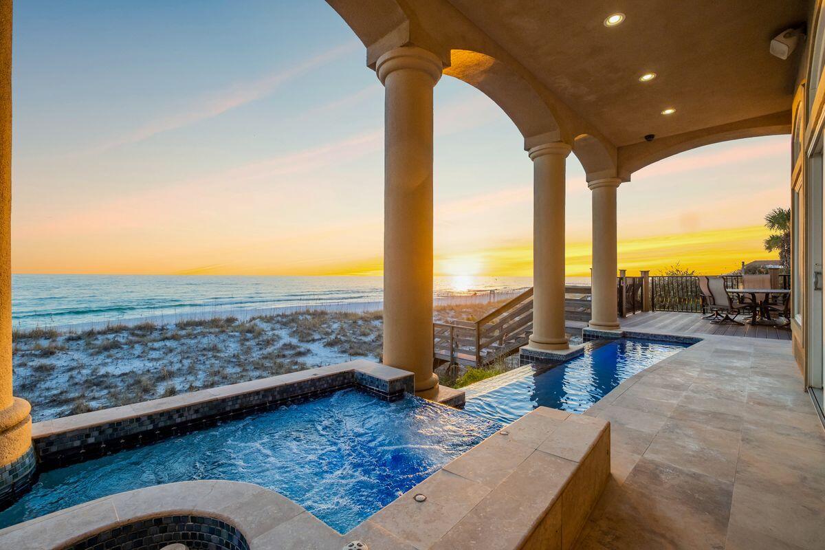 Sprawling mediterranean beach front retreat primely situated on the coveted west side of Destiny by the Sea presiding over 50' of private beach frontage and yielding an impressive amenity package including a gulf front infinity edge pool. This home has never been rented and has been pristinely maintained by the builder from it's inception for the original owner. Notable features include 6 sizable bedrooms, private elevator, first floor living, kitchen and dining, spacious primary suite with oversized walk-in closet, multiple laundry areas, in-home theater, and an impressive top floor deck with fourth story panoramic views over the Gulf of Mexico. This property would be an exceptional second home, primary or short term rental opportunity with annual projected rental income of $400,000-$450,000+. The first level is primarily focused on ample living space with prominent positioning to capture views of the waves breaking on the shoreline providing an impressive sense of arrival. The double height entryway and floor to ceiling glass windows allow for cascading natural lighting and open access to the spiral staircase that ascends four stories. The first level living, kitchen and dining area enjoy unparalleled views of the emerald green waters of the Gulf of Mexico as well as offer an open living concept complete with finely appointed finishes. The chef's kitchen features custom cabinetry and paneled luxury appliances including a gas range, subzero refrigerator, paneled refrigeration drawers as well as a hidden wall-in pantry. This home was designed for entertaining and is distinguished by its south facing covered porches on each level that allow for endless gulf views and practical outdoor living. The second level features a professionally designed movie theatre with stadium style seating and newly installed projector. The second level also hosts the gulf front primary suite which offers 180 degree gulf views including a gulf front ensuitesuite bath and oversized walk in closet complete with it's own washer/dryer stack. The third floor hosts four sizable bedrooms each with an adjoining bathroom including two spacious gulf front suites. The fourth story is accessible both by the spiral stairs and the private elevator and reveals pinnacle panoramic views over the Gulf of Mexico, both eastern and western facing to enjoy summer sunsets and exceptional vistas all year long. Destiny by the Sea is a guard gated retreat in the heart of Destin with excellent proximity to world class restaurants, shopping, boating, golf course and high-end retail including the Destin Commons which features a Whole Foods.