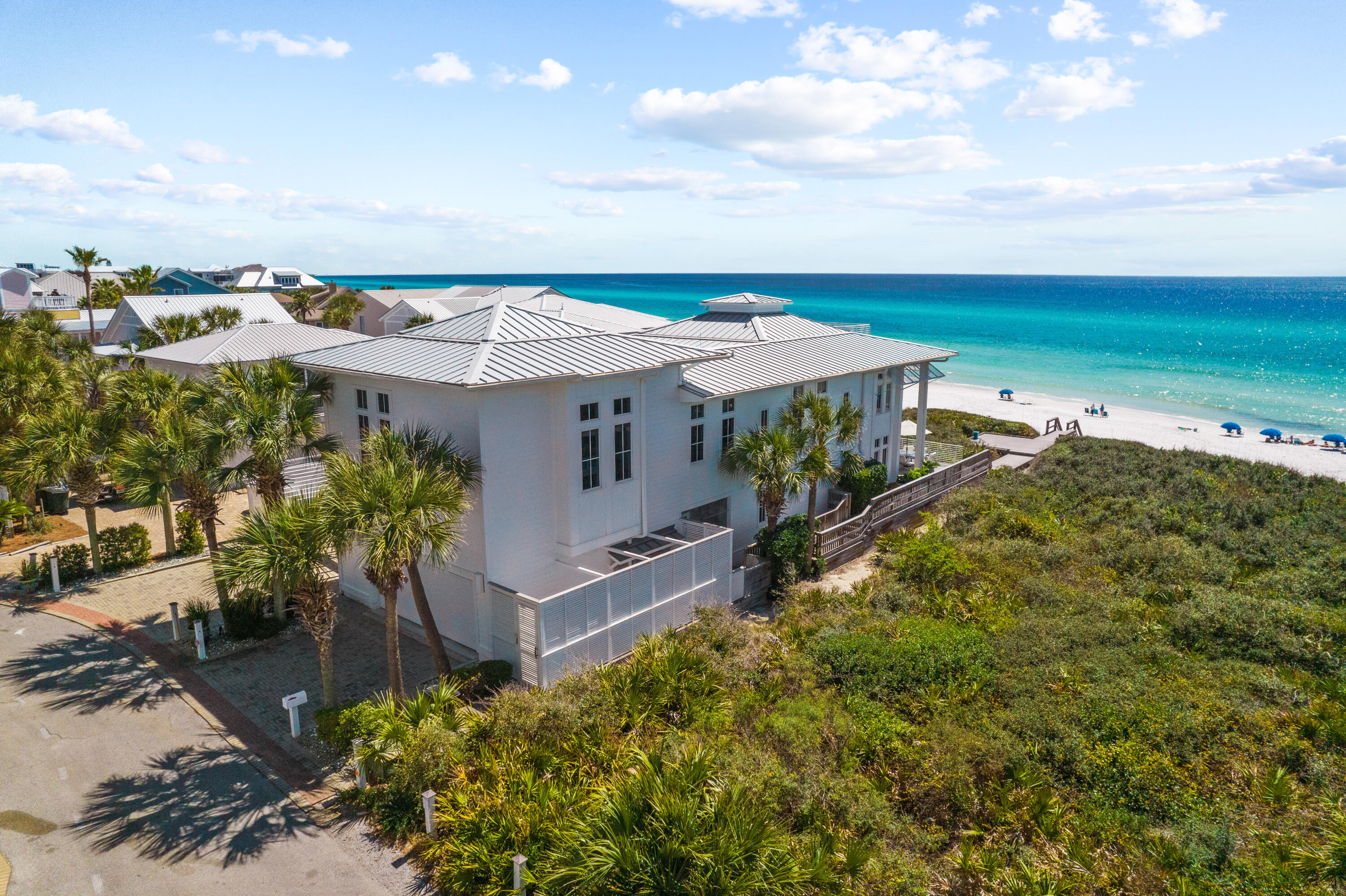 Located on the gulf in the gated community of Majestic Beach, this idyllic beach home sits atop an elevated dune with panoramic views of the emerald green waters of the gulf coast. A private courtyard leads to the entrance of this 5 bedroom home, with 5 full baths and 2 half baths. Views to the gulf are immediately reveled as you step inside this coastal retreat. The living, dining and kitchen areas are filled with natural light from windows reaching ceiling to floor facing the gulf. French doors lead to a porch for outside dining and to your private beach access to the sugar white sandy beach. The chef's kitchen features coffered ceilings, expansive island seating for eight, walk-in pantry, dual Wolf ovens and warming draws, Thermador gas cooktop, Subzero refrigerator with separate freezer. Wet bar, wine cooler and half bath conveniently located off dining area. Bunk room with 3 twin beds, half bath, laundry room  also on 1st level. The 2nd level master suite with amazing gulf views includes private porch, office, walk-in closet, master bath with double vanities, separate shower and whirlpool tub. The 2nd level also includes three additional bedrooms with en-suite baths, and a media room with sleeping loft. Ascend the 3rd level with wet bar, refrigerator, ample storage, and a porch to watch amazing sunrises and sunsets. Interior features include gas fireplace, custom Woodmode kitchen cabinets, maple floors, hand painted and glass tiles, elevator, touch panel blinds and lighting and central vacuum system. Additional features include hurricane glass/impact windows and doors, outside shower, partial basement for storage, whole house generator, Ipe wood decking, 2 car garage, additional onsite parking for 4 and community pool.