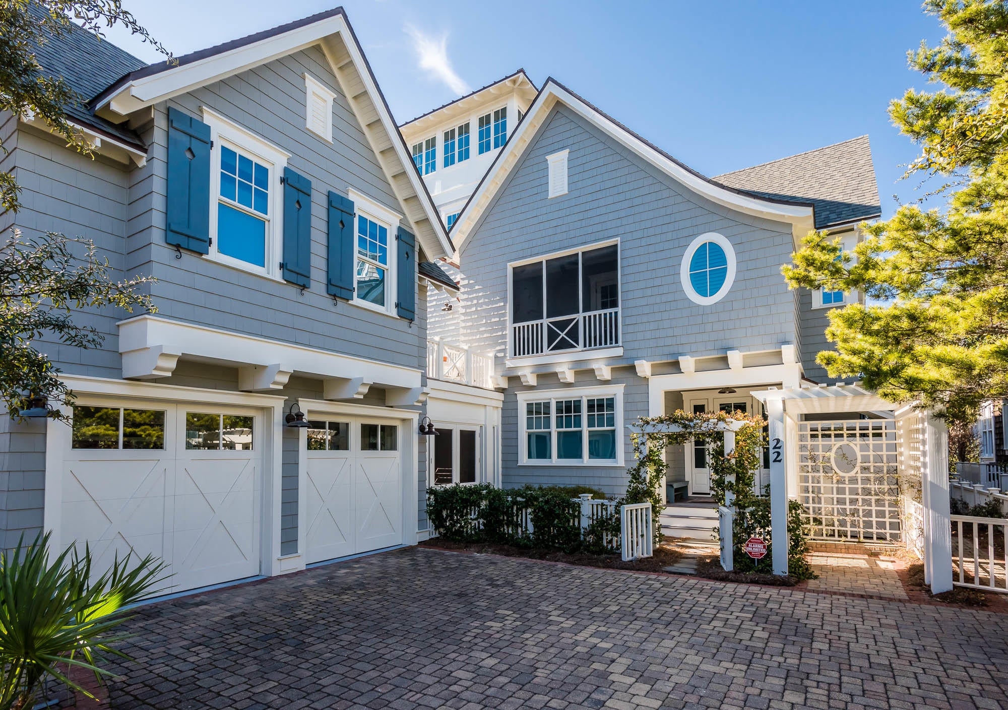 Distinguished by its wood cladding, blue Board and Batten shutters, and welcoming verandas, this classic yet informal beach retreat combines contemporary architectural influences with historic New England born aesthetic. Wooden pathways transport you through the picturesque community nestled among the rolling dunes of WaterSound Beach. The home's arbor adorned with flowering vines welcomes you to this 4,257 square foot estate which features a fun and functional reverse floor plan. The spacious 4 bedroom main house with a bonus bunk room offers an appointed carriage house and can be found in the heart of the private community. Soaring ceilings, wood floors and natural light abound, this home donned in ornate wainscoting and simple shiplap paneling creates a coveted and comfortable beach cottage escape for your family. The main floor living room features shiplap ceilings with beautiful beams running crosswise, and vertical wood paneled walls to accentuate the elevated interior. Two expansive guest suites and a double room with a detached bath can also be found on the main level of this home, as well as, a bonus bunk room for four with built in storage space. The heart of the home can be found on the second level, which features an open concept great room, a spacious coastal kitchen, and a dining room; which encompasses a dividing wall of picture windows that flood the space with natural light and adds a charming detail to the room. The open kitchen offers crisp white cabinets,carrara marble countertops, a center island and breakfast bar, apron sink, a 1950's vintage Northstar fridge, and a classic 1940's antique Wedgewood stove. The home's great room offers vaulted wood paneled ceilings with exposed beams, transom lights and access to a covered porch. Off of the expansive dining room with seating for eight, you can enjoy alfresco dining year round in the screened-in eating porch. Also on this level is a spacious master suite with an attached master bath, expansive walk-in closet and a private screened-in porch. Enjoy the added convenience of the home's elevator and attached two-car garage. The top floor of this home offers an expansive crow's nest featuring panoramic views of WaterSound and the emerald green hues of the Gulf of Mexico. The home offers a screened in front porch flanking the front door, a convenient landing pad connecting the main house and carriage house, laundry rooms on both levels of the home, a screened in patio connecting the main house and garage, and multiple window benches meant for enjoying a good book. This one of a kind WaterSound beach house is a MUST SEE!