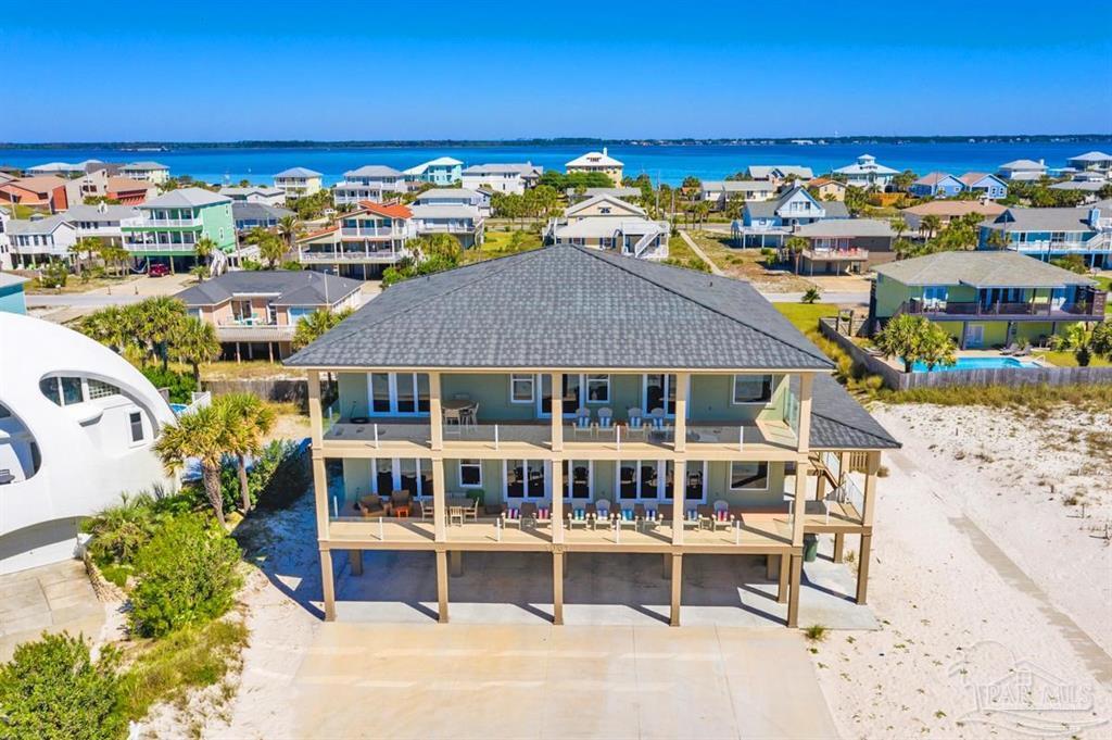 Following Seas'', 1007 Ariola is now available. Completed in 2017, this home was built to the highest standards with special attention paid to low maintenance finishes that enhance the ease and joy of owning this wonderful home. Finishes/features include ICF construction, double wide concrete entry steps, barrel tile metal roof, hurricane rated high impact glass windows and doors, Hardie board finished exterior ceilings and carport, pool equipment located inside storage away from salt air, and elevated concrete HVAC utility area. There is an abundance of space for family and friends with over 5,100 square feet of heated and cooled living, 1,542 square feet of double covered porches perfect for watching the Blue Angels airshow, 2,552 square feet of covered and finished carport perfect for gatherings, a large Viking fiberglass pool complete with a custom paver deck, and a poolside Tiki Bar with 2 locking barn doors servicing the pool and carport area. Each of the 8 bedrooms has a private bath and there is an additional ½ bath on the main level for common use. Currently this home is furnished to sleep up to 28 with 2 King rooms, 4 Double Queen rooms, and 2 Bunk rooms with custom built-in bunks that feature walk-up stairs. In addition to the huge main floor living area there is a second-floor great room with coffee bar, wine fridge and sink  creating an ideal space for upstairs guests. Kitchen is extra-large with plenty of space for large gatherings and features a 16 ft + kitchen island. Enjoy amazing Gulf views, easy Gulf access, and open spaces with a beach easement bordering the property.   This is a turn-key vacation rental opportunity and is being offered fully furnished and outfitted.  There is currently over $253,000 in rentals for 2021.  The Owners have enjoyed it and have donated several stays during 2021 so the actual rental potential is closer to $300,000 annually.