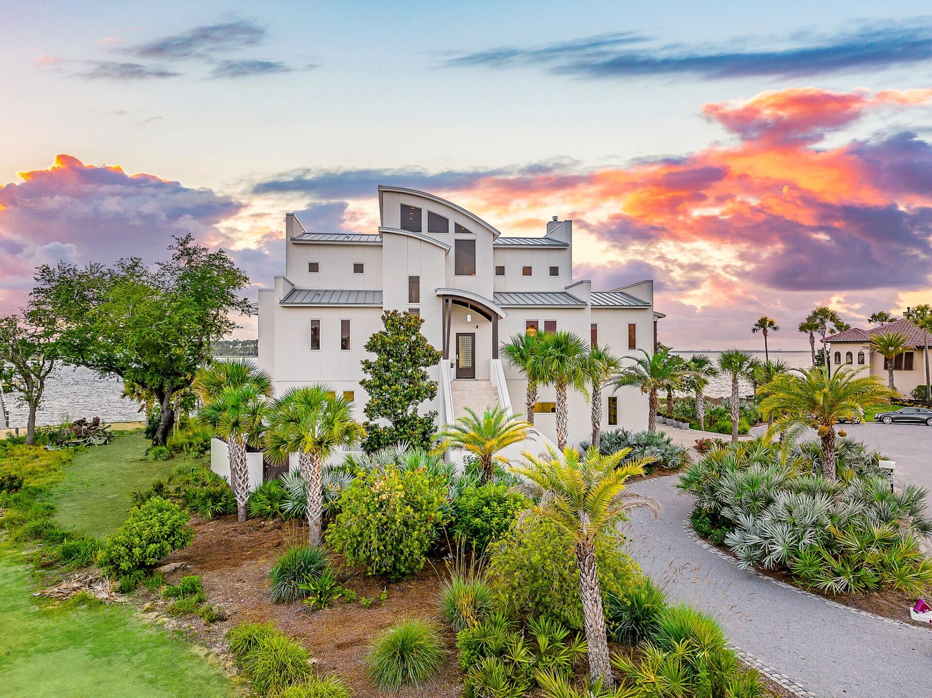 Discover unparalleled luxury on a private island in northwest Florida, where contemporary architecture meets serene tropical beauty. This extraordinary masterpiece was recently featured on HGTV House Hunters Amazing Water Homes in January 2025 and is even more stunning in person than on international TV! 

As you approach Northshore Islands, you're greeted by only a few homes and this home exudes privacy, exclusivity and remarkable architecture. Built by Rita Jones with the design team of Architect Michael Hunnicutt, and Katie Fisher Design, Interior Design, this exceptional three-story contemporary, modern estate spans over 5,000 square feet, offered fully furnished with NEW furnishings and offers breathtaking waterfront views from every room. Enjoy expansive outdoor living with bay-view covered porches on each level, perfect for soaking in the tranquility of the surroundings on the island. 

Imagine leaving your dock for Shell Island or heading out for a sunset cruise. Picture yourself with the kids by the pool while watching the sun sink into the horizon. This is one of the very few locations in Panama City, Florida that has been built based on the picturesque views and was designed to maximize views of the water from all angles. This private island is a truly a waterfront dream come true! 

For boating and fishing enthusiasts, the property features a private, recently renovated, 350' dock with deep water access to the Gulf of Mexico, which is just 10 nautical miles away with no idle speeds zone in between, offering endless opportunities for fishing and adventure. The dock also holds a 2021 Barletta Pontoon boat on lift and a NEW 40,000 LB boat lift, ALL of which will convey to the new owner to be able to enjoy the waterfront lifestyle from day one! Not looking for boating adventure? This home offers zero entry into the Bay which is perfect for kayaks, paddleboards and swimming as you watch the picturesque sunset set in the West each day. The island's natural landscaping and soothing bay sounds welcome you to this peaceful retreat, where indoor and outdoor spaces blend seamlessly with a saltwater pool and spa. 

Upon approach to the circular cobblestone paver driveway, you're greeted by sea breezes and a travertine marble tile entry and a foyer framed with a custom Mahogany wood door with artistic blown glass. Entering the main level, the stunning waterfront views stand out as you sit at 23' elevation and enjoy a great room that offers views of the island from all angles. The family room area is framed by custom millwork and a modern linear fireplace surrounded with marble and slate tile creates warmth in the space while framing a wall of full-glass French doors that lead out onto a covered patio overlooking both pool and Bay. From here you can take in gorgeous year-round sunsets as they sink into the horizon each evening. This level also features a light-filled dining room overlooking the natural landscape of the island and a powder room with Onyx walls and custom pedestal sink for guests, and a junior suite overlooking Bay and pool complete with full bath, walk in closet, and Juliet balcony. Luxurious polished travertine tile is consistent throughout the main floor in the great room for a seamless look. 

The open kitchen is fully-equipped and features a custom slab walnut cabinetry, 48'' Thermador Professional convection microwave oven, warming drawer, Viking range hood and full-size Electrolux refrigerator and freezer. A Caesarstone Quartz waterfall countertop island is a showpiece and the oversized island seats 4. The bar and new wine refrigerator are excellent for entertaining and just off the kitchen and adjacent to the 16'x10' walk-in pantry and laundry room with stunning granite countertops, custom cabinetry, washer and dryer and the most perfect views of the island!

The primary suite, just off the kitchen, is a haven of luxury, offering radiant heated Italian porcelain tile floors, a spa-like Grohe walk-in shower with 3 body jets and 2 hand showers, new freestanding tub overlooking the Bay, slab walnut cabinetry with Swarovski crystal knobs and direct access to a waterfront patio with a fireplace. This retreat also features a large 14'x9' closet in the primary suite featuring fully enclosed cabinetry.

The lower level outdoor summer kitchen is an entertainer's dream, overlooking the Bay and pool, is equipped with new luxury appliances, Caesarstone quartz countertops, and custom walnut cabinetry. The pool is framed with luxurious custom tile, Travertine decking and offers new equipment for easy maintenance. With an 18' deep covered patio, your entertaining dreams will become a reality in this world-class outdoor living area. Overlooking the Bay, your boat and the best sunsets that Panama City has to offer - you can't wait to call this one home.

The third level provides a 19"x16" loft living area with remarkable barreled tongue and groove ceiling, waterfront office filled with floor to ceiling glass and doors, and two en suite guest bedrooms, each with walk-in closets and recently renovated luxurious private en suite bathrooms with marble and custom tile finishes.

The lower level includes a 35"x24" 4-car tandem garage, 15"x10" workshop space, media-game room with full kitchenette, full bathroom and a walk-in wine room, ideal for entertaining being just off the outdoor summer kitchen and pool area.

The home's robust construction features cement-filled concrete block walls, hurricane-rated Anderson windows, 150-mph wind rated garage doors, safe room and a 1/2" tempered, frameless glass railing system for unobstructed Bay views. A built-in generator fully powers the second and third floors of the home and there are high-efficiency heat pumps for each floor providing comfort and convenience. A solid, standing seam aluminum roof was installed in 2019. The home has a 500-gallon underground propane tank and infrastructure on the island includes high speed internet, city water and sewer.

This exclusive waterfront home offers a rare opportunity to live the coastal life you've always desired.