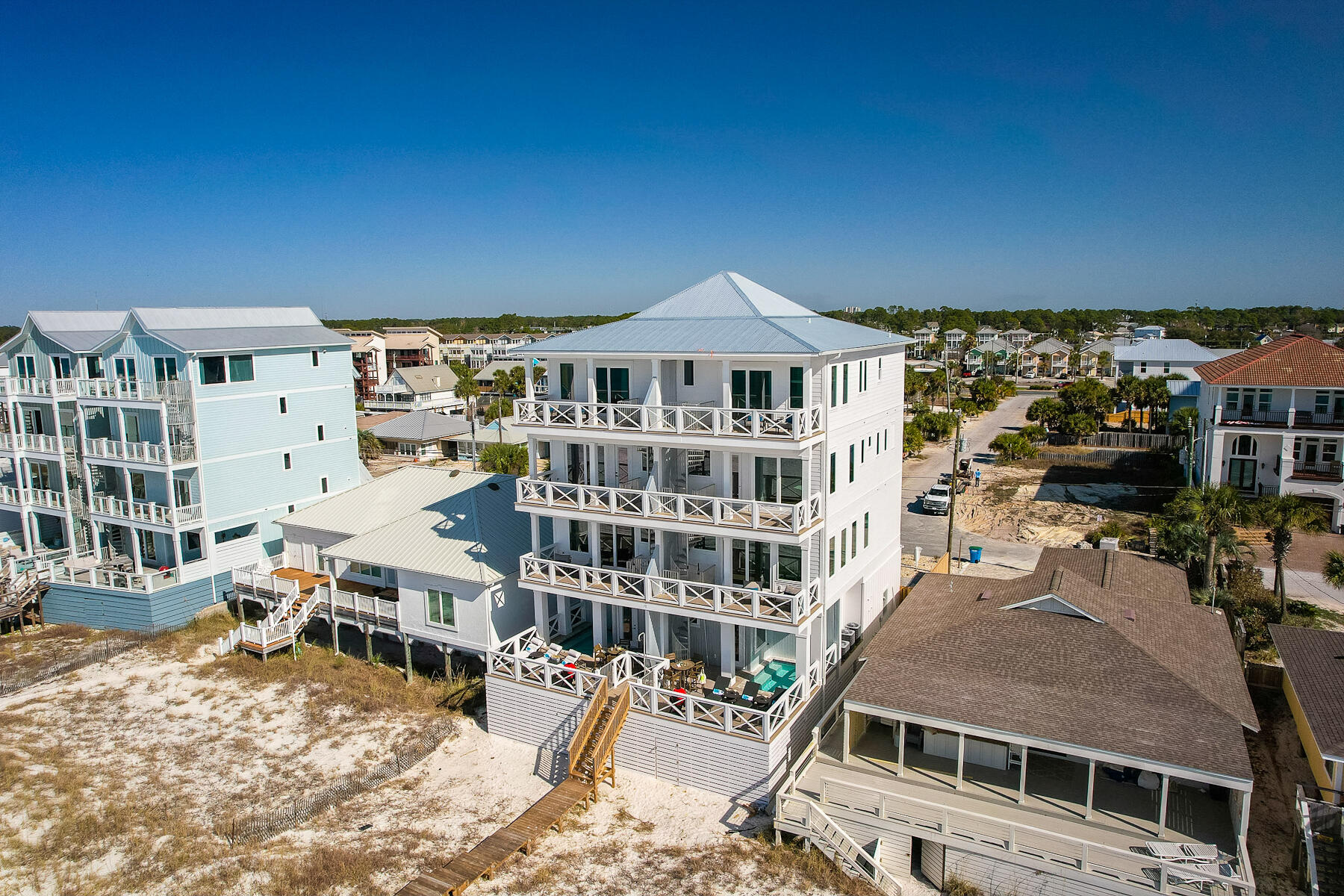 Featured on HGTV this stunning luxury beachfront home is located on the sugary white sands of the Gulf of Mexico in Panama City Beach. This newer constructed 5 bedroom, 5.5 bath duplex comes fully furnished and can sleep up to 19 guests making it an excellent investment property. As you enter the 1st level you will find a spacious bunk room with full bathroom in the hall. Stop by the wet bar to grab a cocktail on your way out to the private heated pool with direct beach access from the beach walkover. The second floor seamlessly blends living and dining areas creating the perfect space for entertaining. The gourmet kitchen features custom cabinetry, premium stainless-steel appliances, tile backsplash and beautiful quartz countertops. Enjoy panoramic views of the Gulf of Mexico from the balcony off the living room. The third floor has two guest bedrooms, each has an ensuite bathroom with custom cabinetry, quartz countertops, and designer tile with frameless shower doors. The fourth floor has a spacious guest bedroom that has custom-built queen over king bunk beds. The ensuite bathroom is complete with double vanity, quartz countertops, frameless shower stall, and designer lighting and mirrors. The oversized primary bedroom has its own private balcony with unobstructed views of the beach to the East and the West. The master bath comes complete with a walk-in shower, freestanding soaking tub, quartz countertop with dual vanity, and custom cabinets. Additional features in this gorgeous home include hurricane impact windows and doors, built elevator-ready, upgraded lighting fixtures and pendants, tankless hot water heaters, and each floor has a deck that provides spectacular views of the beach.