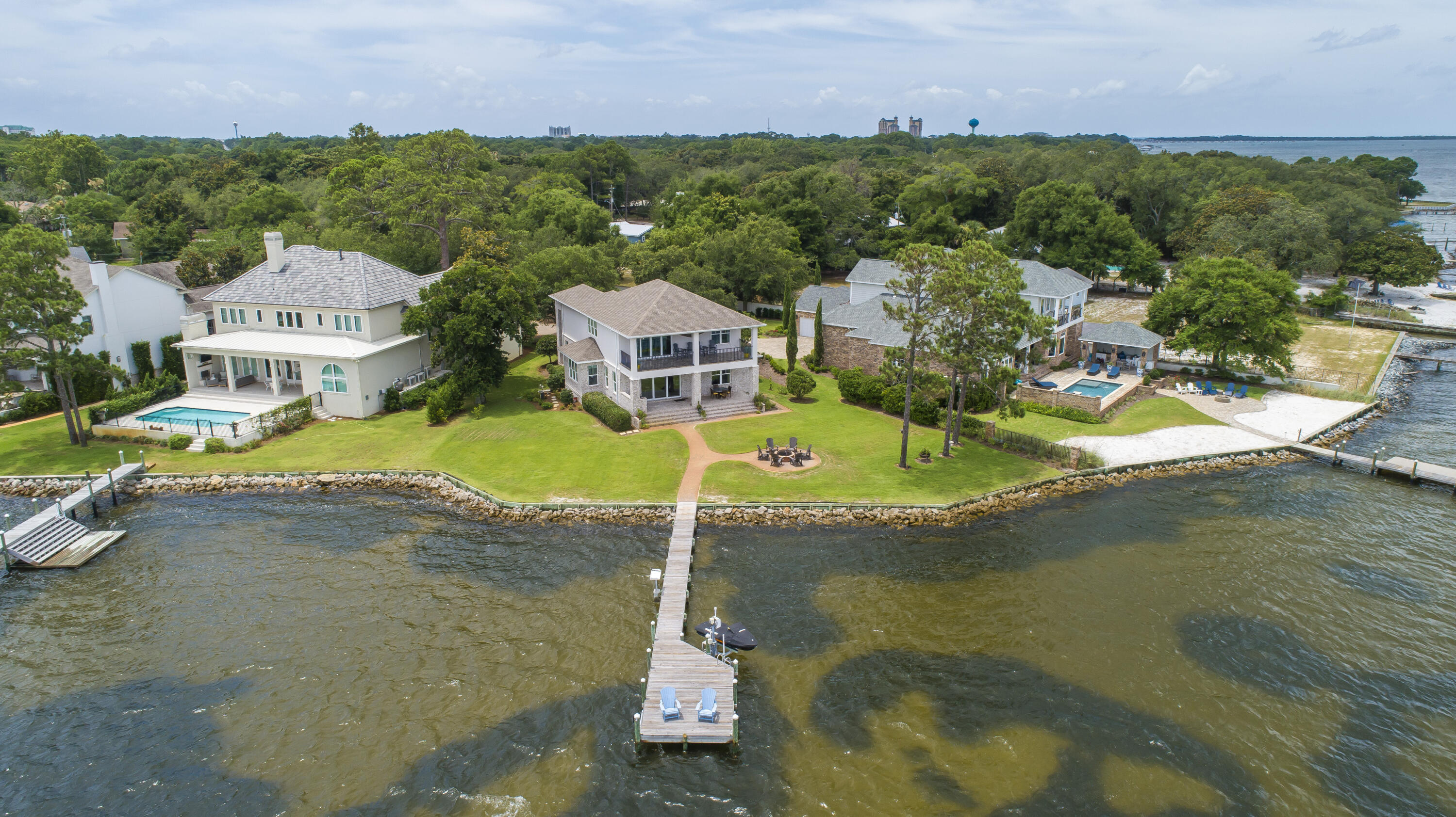 Rare Bayfront opportunity, newer construction built in 2016 In gated community of Peacock's Point. Come take advantage of endless sunsets looking due West from your large covered porch with outdoor Kitchen and  firepit.  159' of Bayfront with dock and seawall in place, includes a wave runner lift. Step inside to enjoy the Hardwood floors and gourmet kitchen with a large island and stainless wolf appliances. Recessed lighting 8' interior doors and built in speakers highlight the living space along with a separate dining area. the second floor boasts a large entertainment area with a bar and balcony. Exterior of home is combination
of Brick and Stucco 2 ACs and a Generac generator.