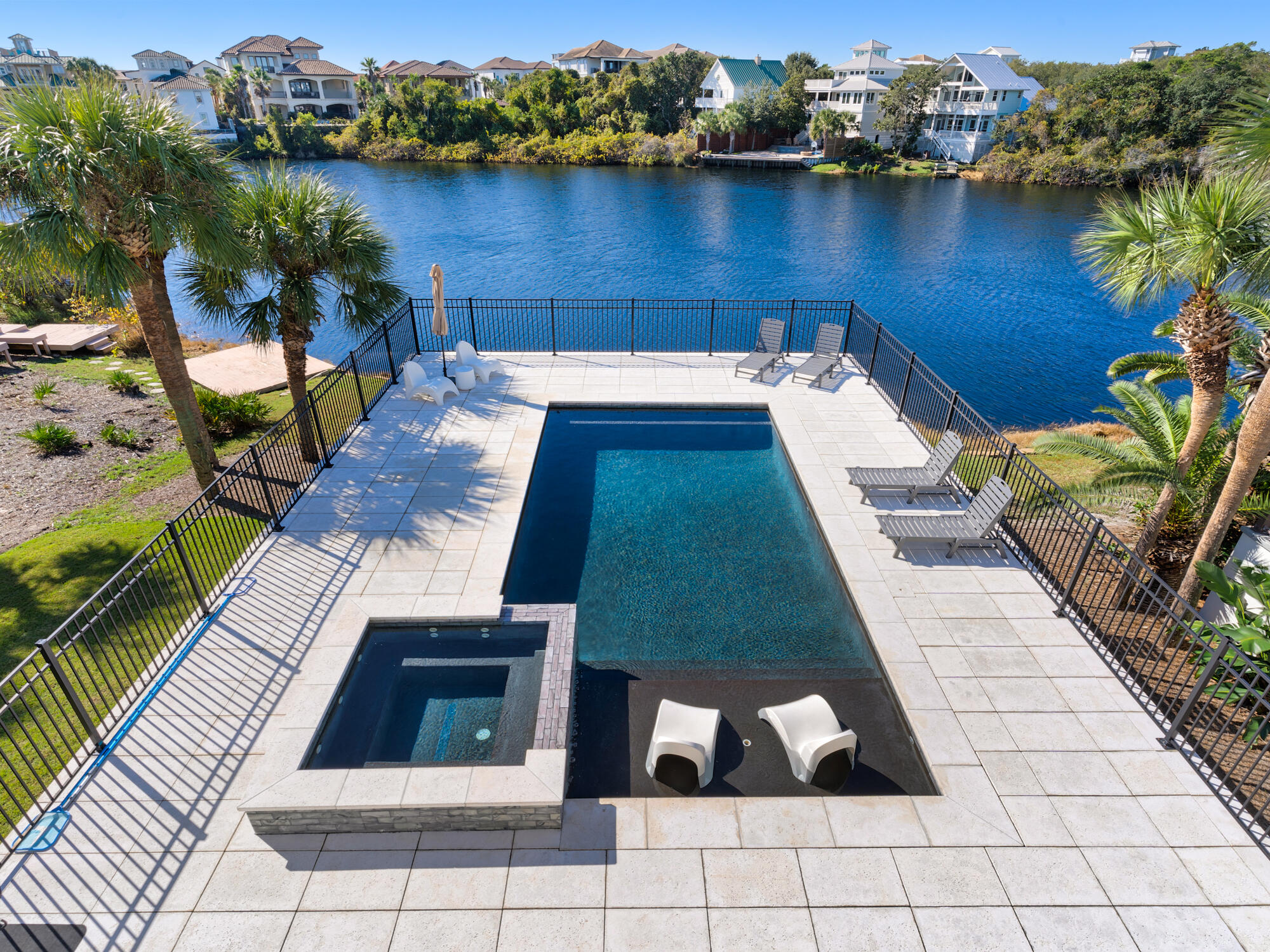 This stunning, fully renovated retreat has been transformed into a one of a kind gem.  Offering breathtaking water views and unparalleled quality throughout. This three-story masterpiece showcases meticulous craftsmanship and attention to detail.  The homes remodel features new electrical systems, including outlets, switches, lighting, fans, and plumbing fixtures, all carefully selected to complement the sophisticated interior design. Exceptional white oak wood flooring runs throughout, with custom metal railings on both the stairs and balconies adding to the high-end finish. The kitchen is equipped with top-of-the-line Wolf and Sub-Zero appliances, centered around the 10-foot island with quartz waterfall edges. Rental income with owner use $150,000 and projections of $180,000! Modern linear gas fireplace is the centerpiece for the spacious main living. The luxurious bathrooms are designed with exquisite tile work, custom vanities, and frameless glass doors. Every interior wall is adorned with premium white shiplap, while the ceilings, both inside and out, feature beautifully stained tongue-and-groove wood.  The third level retreat is just that with a beverage center, bedroom, full bath and large den leading onto the covered viewing deck where you will be with nature overlooking the pool, lake and Gulf of Mexico. The tankless water heater ensures an endless supply of hot water to all four bathrooms. The addition of the gunite pool and eight-person spa incorporate the latest technology, allowing remote control of features like ambient LED lighting and heating. The pool, designed for both relaxation and entertainment, includes a tanning ledge and ample space for swimming. A fenced pool deck features large white rock pavers. The exterior of the home, recently clad in hard coat stucco, and all-new hurricane-rated impact windows and doors. Every window, door, and balcony has been professionally waterproofed and sealed, ensuring protection against the elements. The tile roof and garage doors have been replaced in 2021 for added safety. Situated on a quiet cul-de-sac in the highly desirable gated community of Destiny West, this lakefront property offers access to a community clubhouse, pool, tennis courts, and gym. Enjoy panoramic views of Sunset Lake and the Gulf of Mexico from all living areas and balconies. Just a short walk to the stunning beaches of the Emerald Coast.