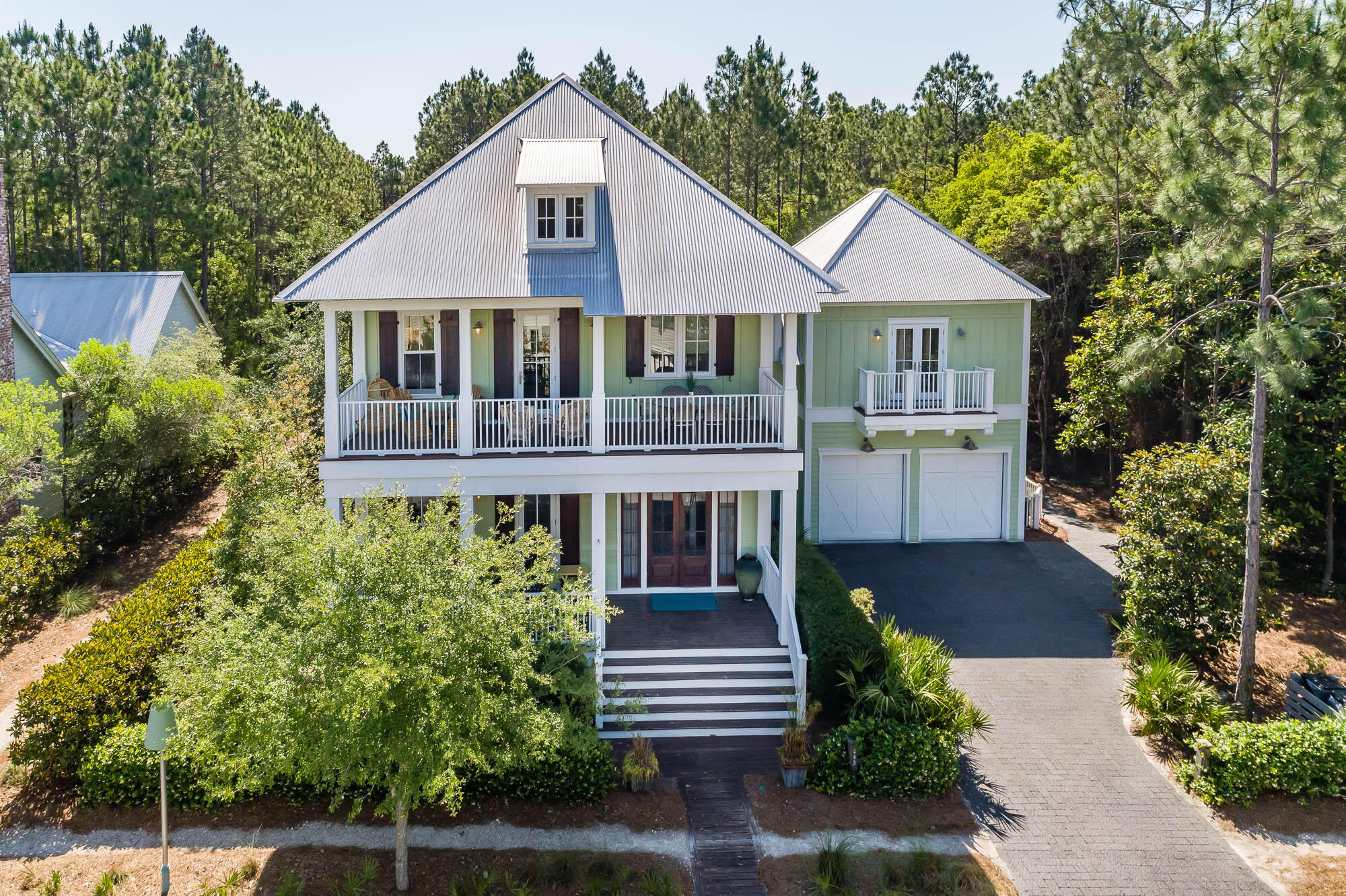 This Previous Parade of Homes Grand Prize winning home is one-of-a-kind in WaterColor. Featuring 5,184 sq ft under roof and 3953 sq ft heated and cooled. From the unparalleled lot surrounded by wooded open space to the large back yard complete with huge trees, the back yard is fully fenced with a large paver area. There is an in-ground black bottom pool with integrated jacuzzi (featuring a waterfall into the main pool, Outdoor Chicago Brick Isokern Fireplace, Outdoor shower and professional built in gas grill. The exterior features 6 covered decks totaling over 1275 sq ft. There is an oversized attached two car garage with additional storage space. The garage connects to the main home and allows for easy access to the laundry room and kitchen. The first floor features many spectacular finishes from the grand gas lamp on the front porch to the impact rated mahogany double front door, opening to the grand foyer with antique Chicago brick walls and antique white oak floors throughout the home. The first floor has a large guest bedroom with full bath in white marble, barn doors and access to the 1st floor deck. The Kitchen features extensive white custom wood cabinets, tin ceilings, a large walk-in pantry and wine storage area, Full Professional Grade Thermodor Appliance package with a 48'' Refrigerator, 48'' Gas Range and hood, pot filler, Two Dishwashers, 36'' farm sink, 12' marble island, Built-in Coffee Maker, Microwave and Warming Drawer. The living and dining are very large and feature 11' coffered ceilings with tonque and groove wood walls, access to large rear porch overlooking the yard and pool, a 4' gas firplace with seashell tabby and chicago brick accents and large built-ins for televisions, books and electronics. There is a large laundry room with Bosch washer and dryer, built in cabinets and large laundry sink, there is also a laundry chute from the master closet allowing clothes to be easily sent to the laundry. The second floor features 4 oversized bedrooms and 4 full baths, 3 of which are full 5 piece master type bathrooms with extensive white marble and clawfoot tubs. The front bedroom is oversized with a a full marble 5 piece bath, clawfoot tub and large private deck, there is a large hallway and full built in desk and office area. The ''Kids'' bedroom features a full marble bath and custom built Double/Twin Teak Ship bunk beds. The master bedroom features Chicago Brick accents, raised ceiling, private large deck that overlooks pool and backyard and a large spa like 5 piece master bath featuring floor to ceiling marble, soaking tub, make-up area, private shower with multiple heads and a large walk-in closet. The 2nd Master over the garage is accessed from a bridge that features a built in reading area and ''winter closet''. The 2nd Master features vaulted ceilings a huge walk in closet and private deck that overlooks the pool. The bathroom is another 5 piece bath with extensive marble, clawfoot tub and separate shower, and a 2nd deck off of the bathroom. For the full time or part time resident, this might be the best location in all of WaterColor with easy access to Publix and 395, and all of the WaterColor amenities, yet on a very private street.  The WaterColor community includes both condos and residential homes and an award-winning beach side resort located above the dunes of the beautiful Gulf of Mexico beaches and offers 3 pools and a poolside restaurant. Camp Watercolor offers a lazy river plus two additional pools and a poolside cafe. The community is designed to have a small-town feel and is perfect for exploring on foot or by bike. Quaint streets and pathways connect homes to the community's parks, lush green spaces and shops. The community includes access to a boathouse with paddle boards, kayaks and fishing equipment, an outdoor amphitheater, a lakeside pool, a bike barn and more. Residents also have access to Watercolor's state-of-the-art tennis center, including a stadium court surrounded by a grass stepped terrace and native landscaping, five Har-Tru HydroCourt clay tennis courts and a pro shop with tennis gear. Private lessons, group clinics and other activities are available throughout the year. This home will not last long!   Home did $208,000 in rental income in 2021 with 110 days of owner usage and is on pace to surpass that number this year.