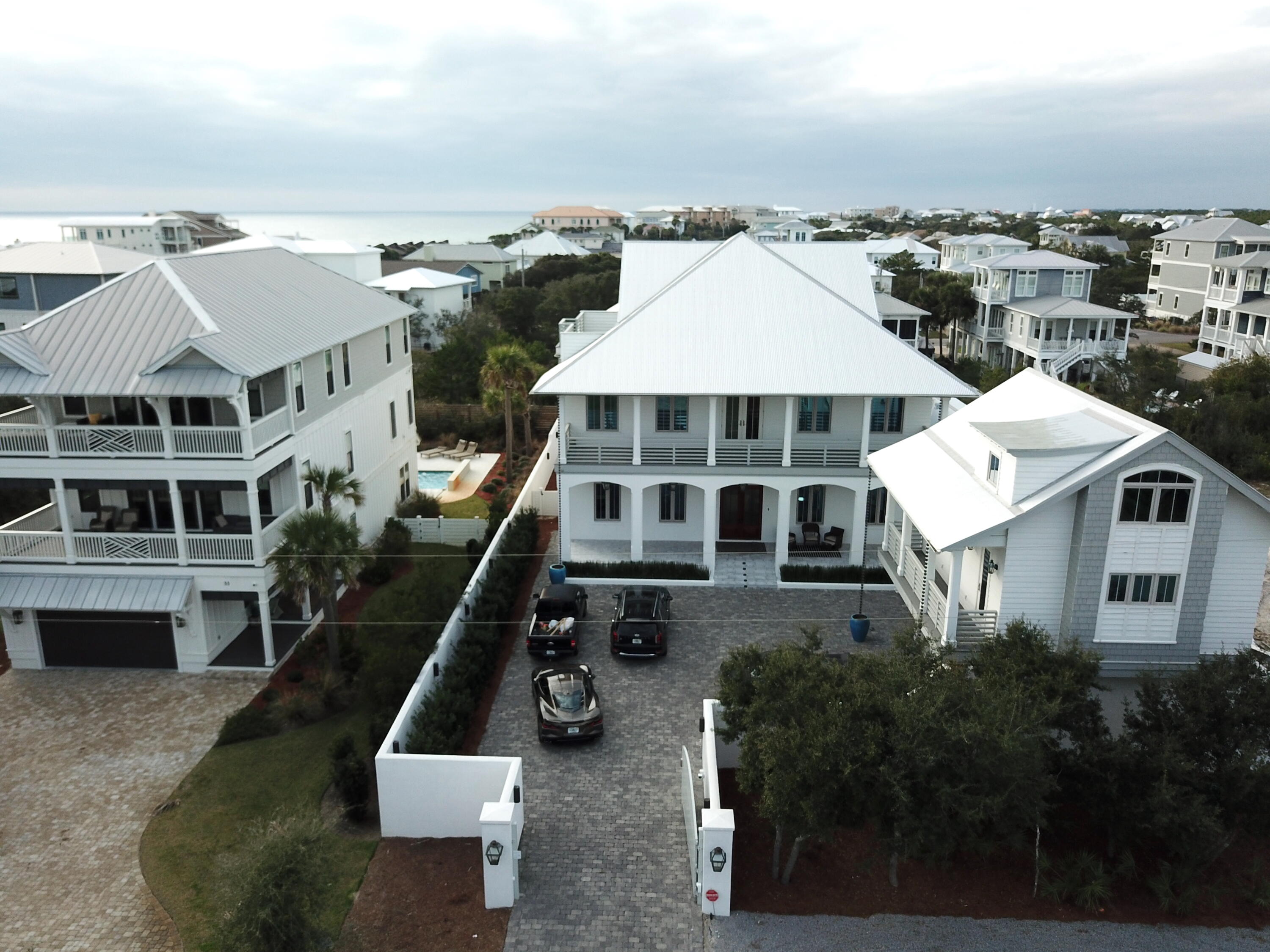 Stunning Caribbean style home with an outdoor pool, subzero and wolf appliance cook center next to an outdoor fireplace surrounded by a 6 foot stucco privacy fence creating the perfect environment for outdoor entertaining.  Home is located 4 houses up from the deeded beach access to the gulf.  The main house has 2 master bedrooms +1 bd loaded with amenities like bathroom heated marble floors wood ceilings, large walk in closets, rain shower faucets, and fireplace. Boasts a large living room, hardwood floors throughout,  kitchen with large cook island enjoying high end subzero refrigerators and wolf appliances. Large laundry room  and 2 1/2 baths on the first floor. The second floor has an additional 3 bedrooms, 3 and 1/2 baths. Relax and enjoy a movie in the movie theater and  work out in the larg the large gym enjoying 12 foot floor to ceiling glass.  The third floor hosts a large game room 12 foot ceilings and opens up to a roof top porch where you can sit and enjoy the unobstructed gulf views. The adjacent carriage house sits above an oversized 2.5 car garage and has a large living space with full kitchen that features all stainless steel appliances.  The main living area is adorned with stunning vaulted wood beams which open to 1 full bedroom and bath.  The third floor features a large bedroom and full bath.  The home is owner occupied and is being offered fully furnished.  There are some exceptions, please review the exceptions list in the documents section of the MLS listing. The layout for this home affords excellent rental opportunity, perfect for investment, second home or primary residence. Prime location on the East end of 30A, close to Camp Creek Golf Course, Alys Beach, Rosemary Beach and more. The beach access for Brenda Ln is just across the street to the South.