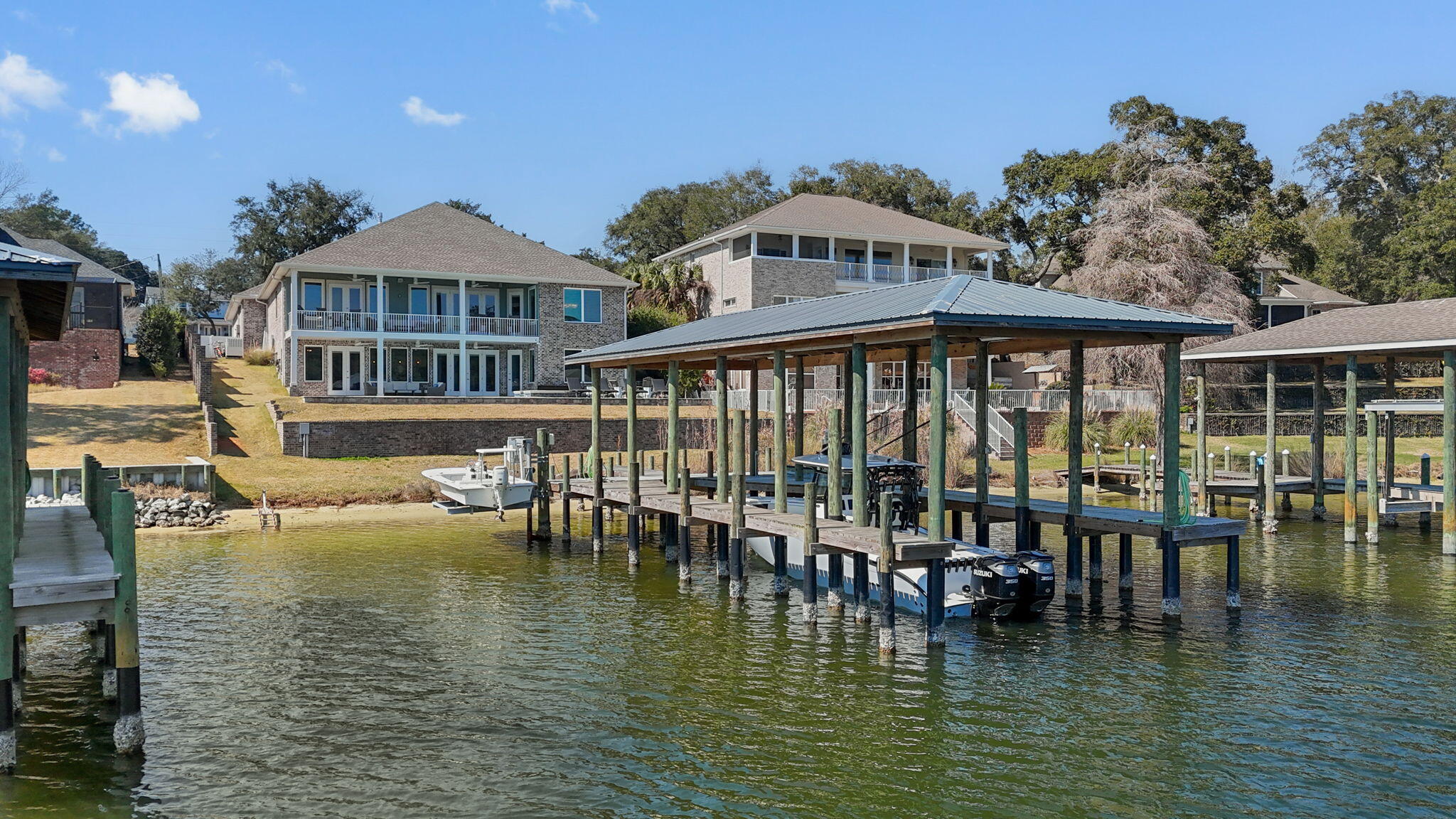 Please see the Video in the photos section and the Features List in the documents section for everything this incredible home has to offer.  Spectacular  Waterfront property with protected deep water boat slip on Poquito Bayou.  If you have ever dreamed of living on the water, this could be your chance.  This is a 6 bed/5 bath, 5000+ sq. ft. home, with an oversized 4 car garage and sits on almost 1/2 acre.  Open and bright with incredible views as soon as you walk in the front door.  On the main level you will find beamed accents on the ceiling in the foyer and living room which has a beautiful quartz stone gas fireplace, large windows and double doors that walk out to the covered, upper patio area.  The gourmet kitchen has quartz countertops, a large center island with cooktop, a breakfast bar and tons of cabinet space.  The Master Bedroom also walks out to the upper patio; the master bath has a huge walk-in closet, built-in electric fireplace, large soaking tub and stand up shower with beautiful tilework on each.  There are 3 more bedrooms on the main level along with a jack n' jill bath and a full bath so every bedroom has their own bathroom access.  The downstairs has been completed to have an entire separate living area, to include a full kitchen with a breakfast bar and also walks out to a lower level covered patio area; the views are every bit as impressive.  There are two additional bedrooms; one being a second Master Suite that also walks-out to the patio, another full bathroom, an office area that is a hurricane safe room and even a gym room.  There is plenty of space in this home to use as a mother-in-law suite or just for your guests to come and enjoy the beautiful area.  Off the lower back patio is the pool with a built-in hot tub and a fire pit; from there it's a quick walk down to the large, covered boat slip where you are likely to see the dolphin playing on occasion.