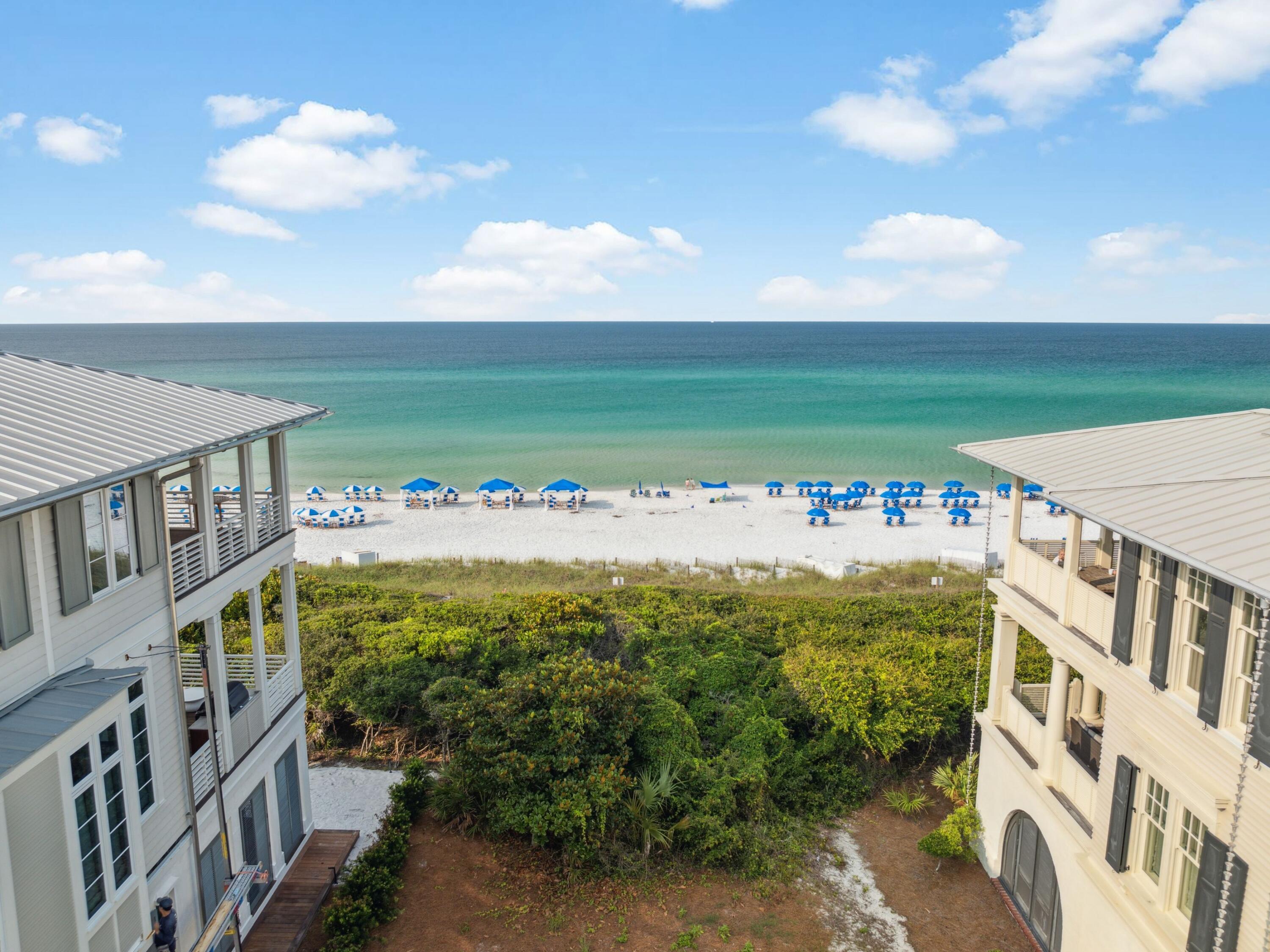 One of the last remaining Gulf-front lots in Seaside, Florida, this exceptional property offers a rare opportunity to create a bespoke coastal estate in one of 30A's most iconic communities. Approved architectural plans convey with the sale, showcasing a thoughtfully designed residence spanning over 5,800 square feet. The proposed design features a three-story main dwelling and a two-story guest suite above the garage, connected by a covered walkway. Highlights include three spacious Gulf-facing porches, a rooftop terrace, a private pool, and beautifully landscaped outdoor spaces. This is a lot listing with architecturally approved plans. The images shown are renderings representing the proposed home design for the lot; construction has not yet begun. Final exterior and interior renderings are forthcoming.

Inside, the plans call for a total of eight bedrooms, including a luxurious third-floor primary suite with private balcony access and panoramic Gulf views. The main house features open-concept living and dining areas, a chef's kitchen, a spiral staircase, elevator access to all levels, and carefully curated architectural details throughout. The guest suite offers separate living quarters, ideal for hosting friends or extended family. Durable all-concrete construction and V-crimp metal roofing ensure both strength and longevity.

Located just steps from the Town Center, this property is walking distance to Seaside's renowned dining, shopping, and cultural experiences. Owners enjoy access to community amenities including pools, tennis and pickleball courts, and a fitness center. Whether you're envisioning a full-time residence, a vacation home, or an investment property, this offering is unmatched in location, design, and lifestyle potential.