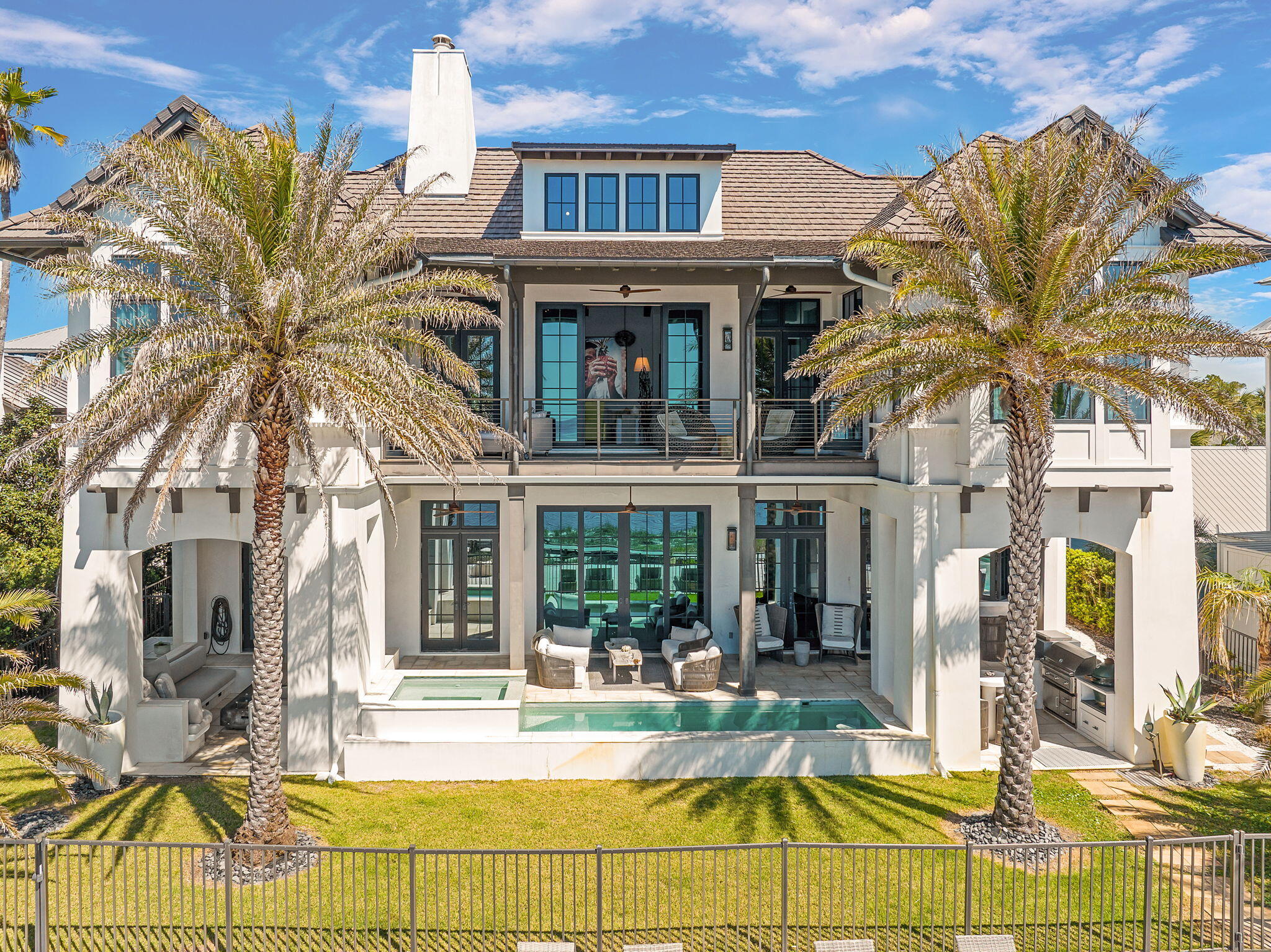 291 Garfield St., located in the iconic beach town of Grayton Beach is a true masterpiece. The custom home was expertly designed by renowned architect, Tom Christ and brought to life by an exceptional team of designers. Every element of this residence was intentionally curated, blending elegant finishes with a relaxed coastal feel that perfectly embodies luxury beach living. This custom home exudes the epitome of what a luxury beach home should be, but yet the design creates an overall feeling of relaxation.  The private drive leads to a spacious parking court and impressive facade creating a true sense of arrival. As you step into the great room, your eyes twitch back and forth from trying to take in the unmatched views of the water with absorbing the interior beauty of the home. Light and reflections dance over the venetian plaster walls and ceilings. Expansive sliding glass doors blur the line between indoors and out, drawing in the sea breeze and creating an open-air coastal retreat with a Caribbean feel. 
A quick glance to the left and you are staring at a custom chilled wine wall; a showcase for exotic wines and champagnes.  The custom kitchen anchors the east end of the home boasting a custom La Canche range, custom cabinets and a sliding window opening the kitchen up to the outdoor cooking and dining area. Tadelakt countertops, an ancient Moroccan blend of concrete and plaster provide ample space for cooking, dining and entertaining. The home is an entertainers dream. The main floor is completed by a guest suite with a private entrance, a large pantry/washroom and a full sized powder bath. The powder bath has both an indoor and outdoor shower; perfect for rinsing off after long days at the beach or dips in the pool.
Upstairs you are yet again wowed by not only the incredible views of the beach and gulf but also by the spacious living area you are standing in. The room showcases soaring vaulted and beamed ceilings anchored by an oversized fireplace. Another set of sliding doors opens up to the large lounging porch overlooking one of 30A's treasures; Grayton Beach. The master suite offers an elevated sense of serenity with its own vaulted ceilings, water views, and spa-inspired en suite bath. Two additional guest suites branch off the living area on this level. The guest lounge and suite is a unique design feature not seen in other homes. This wing serves as yet another place to congregate and entertain around the custom bar and sitting area, while also providing additional sleeping accommodations. The bathroom in this wing is a design standout. 
The home is a work of art, but functionally it was built like a fortress.  Concrete block construction rests atop a number of deeply embedded concrete pilings thus ensuring long term strength and stability. 
Outdoor living here is key with multiple sitting areas providing areas to both relax or entertain; all set against the backdrop of Grayton Beach. If you want to get your feet in the sand or dip your toes in the Gulf waters, take a few steps and there you are. Looking for an exercise option? Grab a paddle board and paddle around Western Lake, but be on the lookout for Bald Eagles, Herons, Blue Crabs or various species of fish.

When it is time to leave the confines of your personal luxury resort, you are steps away from "downtown" Grayton Beach. The world renowned Red Bar offers fresh seafood and live music nearly every day of the week. Chiringos, a fresh upscale 30A take on the beachside open air dive is a favorite for locals and visitors alike. Local favorites like Black Bear Bakery and Borago are just up the road. A few artist galleries and music venues are all within a short distance keeping the Grayton tradition of being a haven for those who create art and music alive.

From the home to the location, 291 Garfield is truly unmatched.