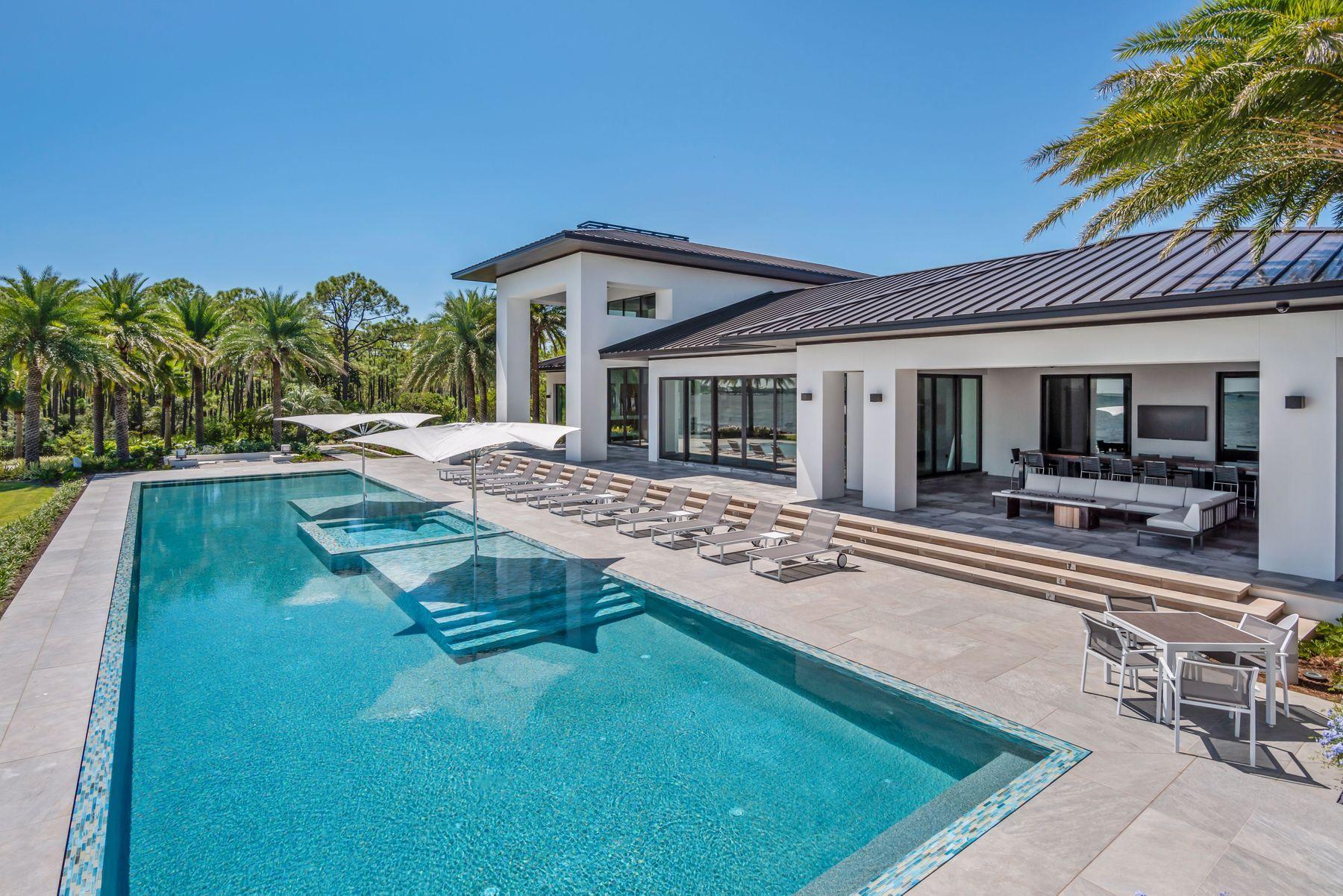 Progressively designed, and meticulously placed upon one of the single most premier parcels in Destin, Florida, this estate exemplifies waterfront luxury to the modern consumer. This 7,269 square foot George Small designed contemporary encapsulates crisp, modern styling both inside and out. Boasting a private dock, 88-foot perimeter overflow pool, 278 feet of water frontage, and a covered summer kitchen area, this one-of-a-kind property offers an ownership experience like none other. Upon entering this 2.53 acre estate, the custom laid Tecura Designs concrete paver driveway escorts visitors toward the oversized garage, and custom built pivot hinged steel French doors. An open layout accents the single story design, creating a fascinatingly livable footprint accented by the epitome of luxurious fixtures and furnishings. Boasting the largest residential built in media center, as well as dual glass sided fireplace, the living space flows gently into the Sub-Zero outfitted kitchen, artistically outfitted with a 15-foot four-inch thick quartzite topped center island. A second seating area gifts residents with additional views of the breathtaking Choctawhatchee Bay through floor to ceiling windows, flowing natural light throughout the property. The owner's master suite is a work of art thanks in part to a multi-point rainforest inspired shower, private laundry space, and bay-front views. Three additional bedrooms, an office space, as well as a detached entertainment room provide endless space and luxury throughout the home. Additional features include a whole home generator, Control4 smart home system and LED lighting throughout.