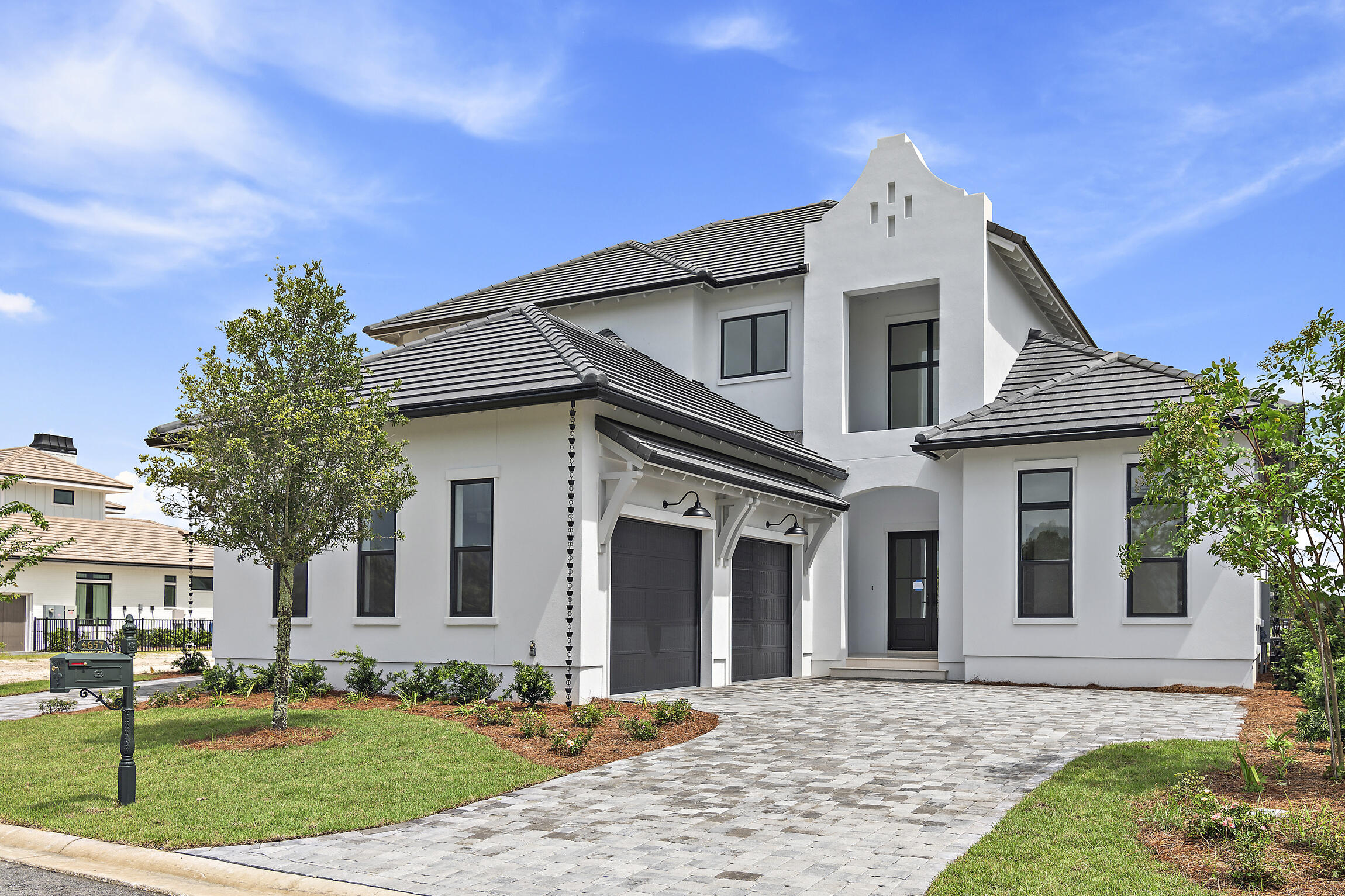 Experience the ultimate in luxury living at Tradewinds, a stunning new community in Regatta Bay featuring 54 homesites with a blend of West Indies and Dutch architectural styles. This magnificent brand-new home is designed for modern indulgence, boasting over 4200 sq. ft. of heated and cooled space, 4 bedrooms, 4.5 baths, a spacious study w/ closet, fully equipped summer kitchen and a 3-car garage. This masterpiece of a home showcases nothing but the best, from a custom wine room, painted wood beams, 12-foot ceilings, custom all wood full overlay cabinets and an indoor and an outdoor fireplace! Get ready to be inspired! Feel opulence living at its finest on the first floor, where an open floor plan combines a great room, gourmet kitchen, generous Butler's pantry, dining room, wine room, large study, and an exquisite master suite. The 2nd floor offers a collection of three guest suites, each with its own private bath, a gathering room and access to a grand balcony that boasts stunning views of the pool and spa area. Transform your living experience with this incredible home, designed to perfection by Boswell Builders. Boasting top-of-the-line materials and advanced features like Hurricane Impact Rated windows and doors, R-19 insulation in exterior walls, efficient electric heat pump-14 seer, and a concrete tile roof, this home offers uncompromising comfort and durability. Enjoy the finest finishes, including quartz counter tops, designer picked bath, kitchen & and lighting selections, all tailored to create a truly exceptional living space.